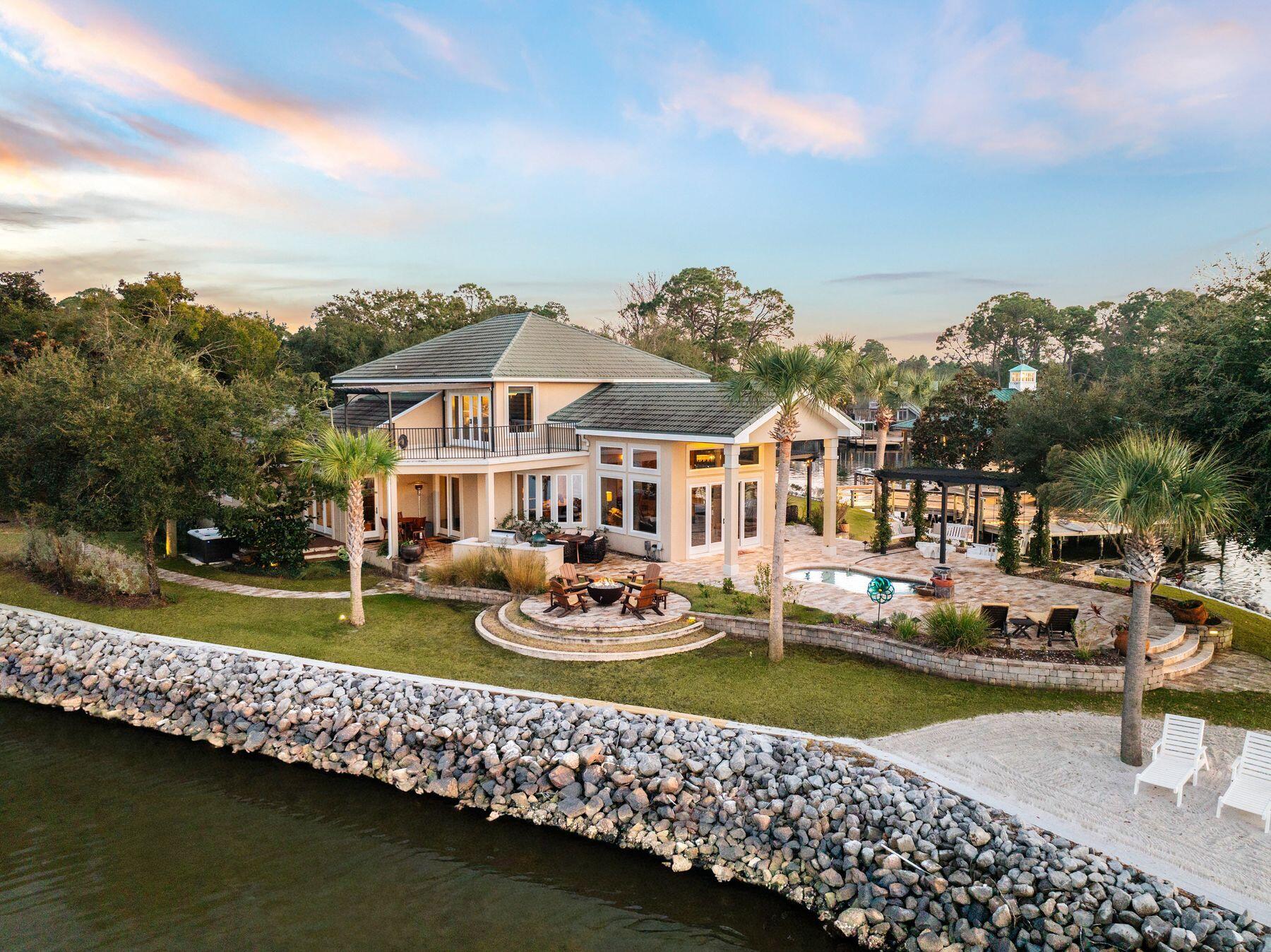 Commanding one of the most extraordinary waterfront positions along the Emerald Coast, Santa Rosa Point occupies its own private peninsula with approximately 500 feet of wraparound frontage on Choctawhatchee Bay. Set on more than an acre of secluded, meticulously landscaped grounds, the estate is surrounded by water on three sides, offering a rare sense of privacy and natural beauty that feels removed yet remains remarkably connected. This is one of just a few deepwater locations on the bay, making it ideal for boating and water enthusiasts. Mornings begin with soft eastern light and dolphins gliding through the bay, while evenings bring sweeping sunsets as herons, osprey, and pelicans return home.
The grounds are richly landscaped with mature tropical plantings and an abundance of palm trees that enhance the property's coastal setting. Along the shoreline, a private manmade white sandy beach provides a rare and inviting waterfront retreat, perfect for relaxing or enjoying the calm bay waters.

Designed for both refined entertaining and effortless daily living, the residence features expansive interior spaces oriented toward uninterrupted water views. The main living areas and primary suite sit just steps from the shoreline, allowing the bay to shape everyday life. The owner's retreat serves as a private sanctuary, featuring a spa-inspired bath with a steam shower and body sprayers, generous walk-in closets with secure storage, and direct access to outdoor living areas overlooking the water.

Solid hardwood flooring in the primary living spaces is complemented by travertine accents and carefully selected low-glare lighting, creating a warm and refined ambiance throughout. The kitchen balances elegance and functionality with custom cabinetry, a Wolf range and oven, and a Sub-Zero refrigerator freezer, supported by an additional full-sized refrigerator in the laundry room.

Five bedrooms are thoughtfully arranged for privacy and flexibility, including two suites on the main level and additional bedrooms with Jack-and-Jill and ensuite-style baths. A dedicated office or workout room and an elevated deck provide inspiring bay views for work, wellness, or quiet retreat.

Abundant storage is found throughout the home, enhanced by custom cabinetry and slat-wall systems in the garage. Four insulated garage bays--one configured as a relaxed man cave--offer ample room for vehicles and recreational gear.

Built with resilience as a priority, the residence features metal stud construction, thick stucco-covered concrete walls, metal trusses, a metal roof, and hurricane-rated windows. A geothermal HVAC system with zoned climate control has been recently upgraded and remains under warranty. A pressure-regulated hot water circulation system ensures rapid delivery throughout the home, while a recently installed whole-house 30kW generator ensures reliable backup power and added peace of mind

Outdoor living rivals that of a private resort with a pool, hot tub, three outdoor showers, an outdoor fireplace and fire pit, expansive patios and balconies, trellis-covered swings, and a shaded daybed retreat. Automated landscape lighting, irrigation, Bluetooth-enabled outdoor speakers, a solar-powered gated entry, and a comprehensive security system provide comfort and peace of mind. Tucked within the wooded portion of the property is a charming kids' "treehouse" style cabana, creating a whimsical hideaway and unique gathering space.

For boating enthusiasts, the estate is anchored by an exceptional dock measuring approximately 58 by 38 feet, equipped with multiple lifts including one rated for up to 20,000 pounds, additional lifts for personal watercraft, and expansive decking designed for both functionality and enjoyment. A separate dock pier at the end of the peninsula provides an additional elevated fishing location, complementing the large boathouse deck and offering several ideal vantage points for casting into the bay. The dock system also includes a swim platform, fish-cleaning station, lighting package, boat power connections, and storage for kayaks and paddleboards, with direct access to both the bay and offshore fishing.

A recreational package is also available for purchase, offering a turnkey coastal lifestyle and including a Pursuit 326 Offshore boat, Yamaha 210 FSH jet boat, Sea-Doo Wake personal watercraft, kayaks, paddleboards, and golf clubs, allowing new owners to immediately enjoy the full range of waterfront and outdoor recreation this exceptional property provides.

The white-sand beaches of Scenic Highway 30A are fabulous and just five minutes away.  But tucked at the end of the road within a small, secluded enclave, Santa Rosa Point offers an escape with more safety, security and privacy for your family, as well as closer proximity to shopping, dining, and entertainment.  It's the best of both worlds!

Meticulously maintained and singular in its setting, this private peninsula estate stands as a true legacy property.