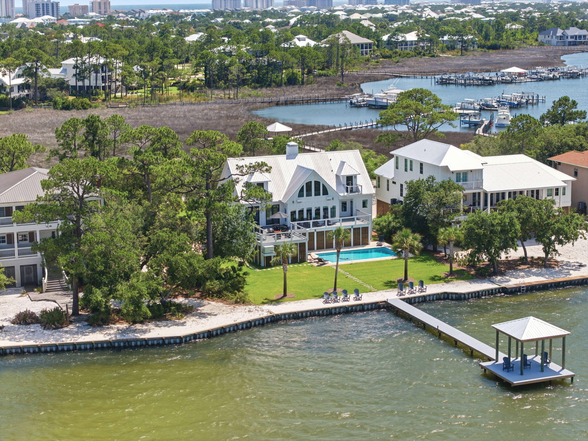 Create your best days with sunsets, nature, & island living on amazing Ono Island! This recently updated waterfront residence captures views of Intracoastal Waterway, Perdido Bay, Arnica Bay, & Bayou St. John, offers exceptional boating access, & relaxed coastal lifestyle that makes Ono Island one of the Gulf Coast's most sought-after communities. Spanning 3,016 square feet, this 3-bedroom, 3.5-bath home showcases thoughtful design & quality finishes throughout. Inside, you'll find beautiful updated glossy quartz tile with modern waterfront style, a Culinary delight with incredible views in the beautifully updated kitchen with custom cabinetry & stainless-steel appliances including burner gas range, quartz, a sophisticated wet bar, beautifully appointed bathrooms, & a wood-burning fireplace that creates a welcoming gathering space. Expansive windows frame the water from multiple rooms, allowing the natural beauty of the bayou to become part of everyday living. Outdoor spaces are designed to take full advantage of the waterfront setting. Spend afternoons by the heated saltwater pool, entertain guests on the composite decking, or relax on the entertainment dock while enjoying the wildlife, nature and the sights and sounds of this exclusive location on Ono Island. The property includes a deeded boat slip with a 16,000-pound lift in Ono Island Harbour, providing access to some of the area's best fishing, cruising, & waterfront destinations. Other features include hurricane-impact windows,  fortified roof, Generac generator, tankless gas water heater, whole-home WiFi automation, irrigation, lush landscaping, & state-of-the-art entertainment system. Upstairs HVAC system replaced in 2026. Life on Ono Island is centered around the water, & this property embraces it beautifully. Whether heading out for a day on the boat, gathering with friends poolside, or ending the evening with sunset views, this is the place to experience the island lifestyle!