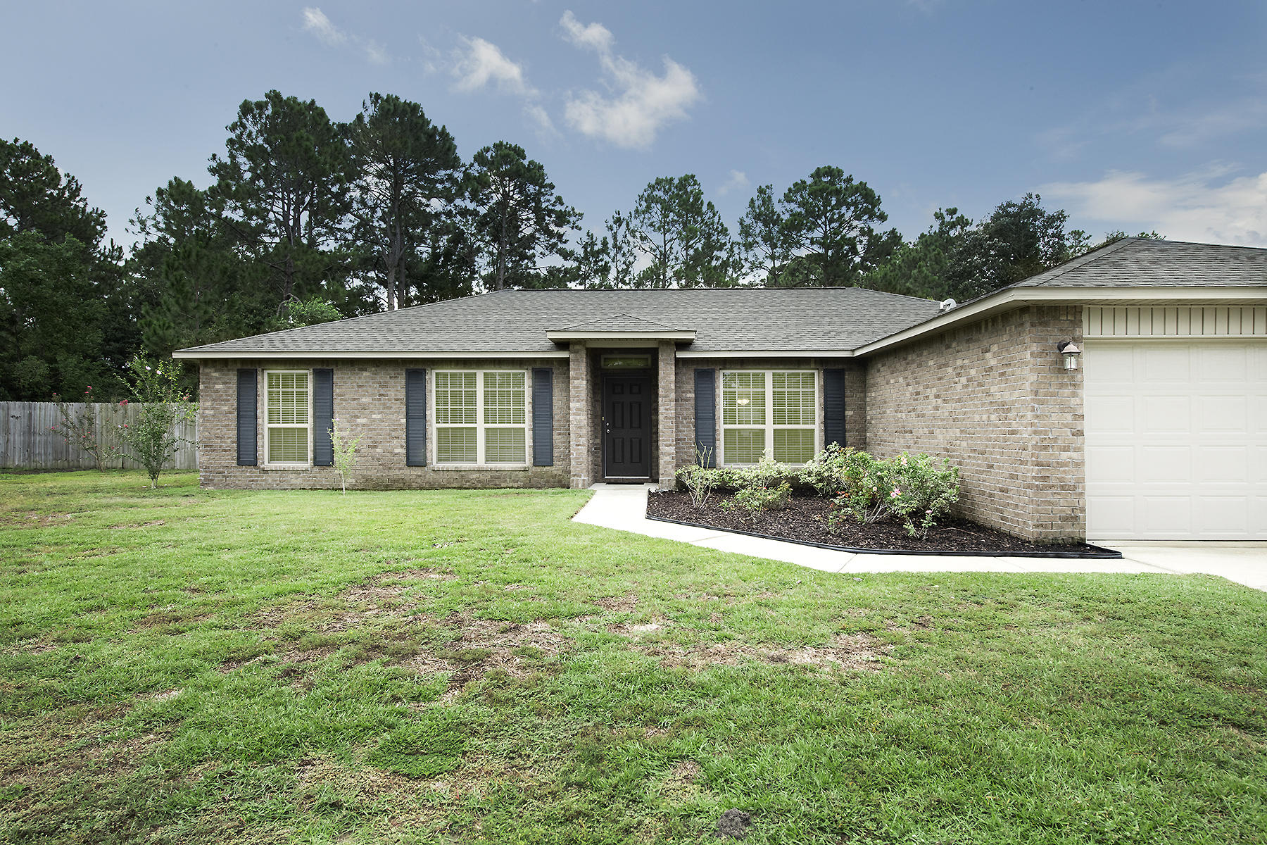 Welcome home to this beautiful ALL brick home in the heart of Navarre. Offering a split floor plan with 4 bedrooms & 2 bathrooms. Home has a nice size kitchen with granite counters, hop up bar, under cabinet lighting, beautiful black stainless steel appliances, large pantry & center island. Sellers added new laminate wood flooring in the entry way, dining, family room & hallways. This home is on an almost half acre lot with an over sized covered back porch perfect for entertaining. Plenty of room to add a pool. Nice landscaping, fully fenced in backyard, with shed & plenty of trees for added privacy. The neighborhood has sidewalks, & is an easy commute to bases and beaches. If you have been looking for a home in East Navarre you want to be sure to add this one to your must see list
