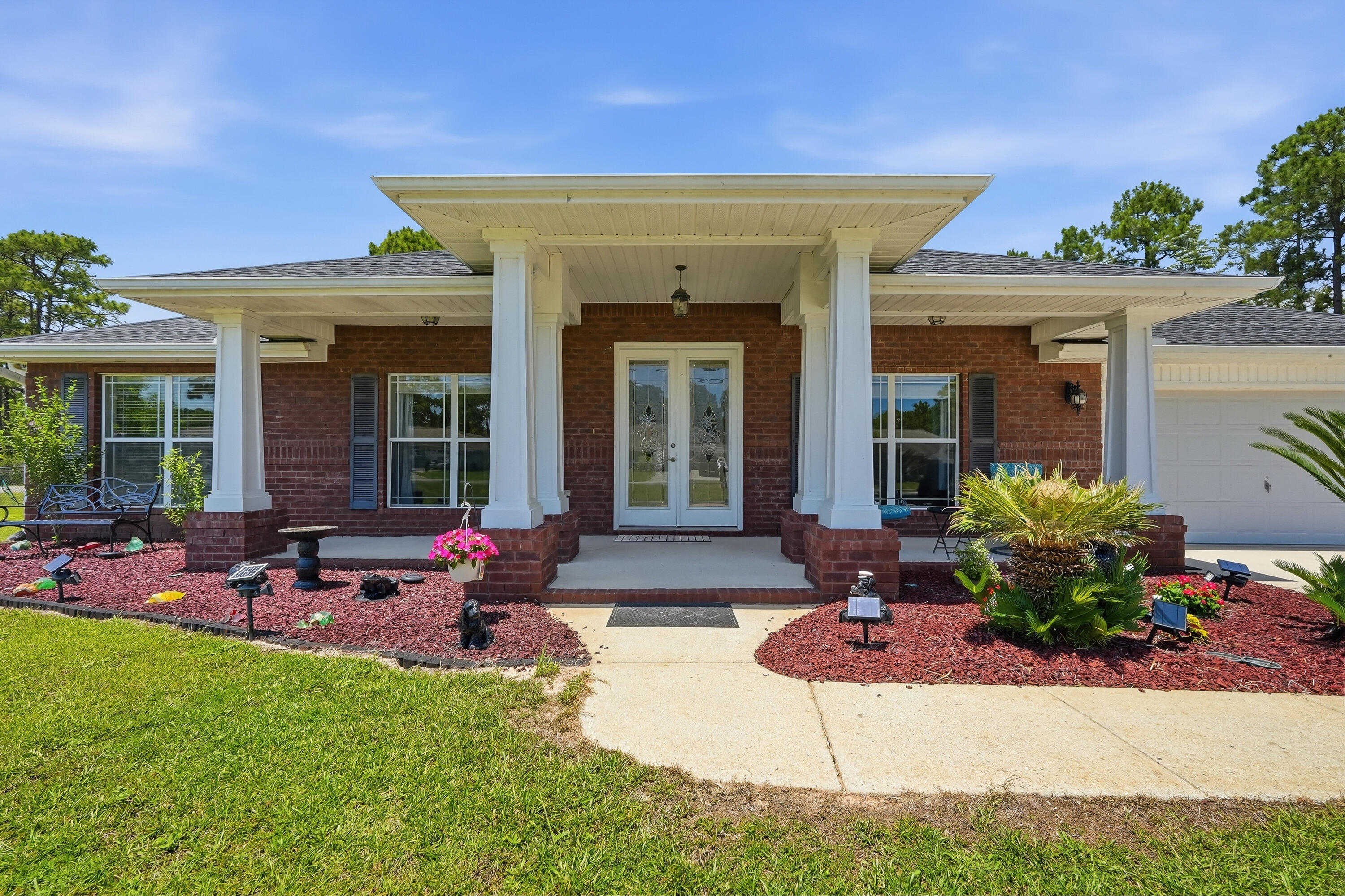 Welcome to the perfect blend of space, comfort, and functionality in this stunning 4-bedroom, 3-bath custom home offering an impressive 3,288 square feet of thoughtfully designed living space. Situated on a beautifully landscaped .70-acre corner lot, this property delivers the privacy, storage, and flexibility today's buyers are searching for. Step through the elegant glass front door and into an expansive open-concept floor plan featuring 20-inch tile flooring throughout the main living areas, soaring spaces for entertaining, and a warm gas fireplace that anchors the oversized family room. The heart of the home is the exceptional chef's kitchen showcasing rich Cavalier mahogany cabinetry, granite countertops, stainless steel appliances,designer drop lighting, and an enormous island complete with abundant drawers, storage, and convenient electrical outlets. A spacious walk-in pantry and sunny breakfast area with a charming bay window make this kitchen as practical as it is beautiful. The thoughtfully designed split-bedroom layout offers privacy for everyone. Two secondary bedrooms share a Jack-and-Jill bath, while a secluded guest suite enjoys access to a nearby full bath, making it ideal for visitors or multi-generational living. The luxurious owner's retreat is a true sanctuary featuring wood-grain tile flooring, dual walk-in closets, separate vanities, a relaxing Jacuzzi tub, and a spacious walk-in shower. Neutral shades of gray and beige create a timeless backdrop through Neutral shades of gray and beige create a timeless backdrop throughout the home, while the additional full bath showcases coastal blue accents that bring a touch of beach-inspired charm. Two separate doors lead to the screened lanai, creating the perfect indoor-outdoor flow for enjoying morning coffee or evening gatherings while overlooking the private wooded backdrop. Outside, the possibilities are endless. The fully fenced backyard includes a side-gate entrance, ample room for an RV, boat, or recreational vehicles, a large storage shed, expansive patio area, and additional driveway leading to a covered carport. Whether you're entertaining friends, storing your toys, or simply enjoying the peaceful surroundings from the welcoming front porch, this property offers the space and freedom rarely found in today's market. Upgrades in Construction: HOT/Cold outside shower; 2 x 6 instead of 2 x 4 beams, Energy package R19 insulation in walls; E-glass energy efficient windows; In addition to this amazing home, you get to enjoy all of the amenities that Holley By The Sea has to offer - including a boat ramp, 8 clay tennis courts, a community event hall, 3 different pools, exercise room, and more! A home of this size, quality, and versatility is truly a rare find, offering luxury, privacy, and room to live the lifestyle you've always wanted.