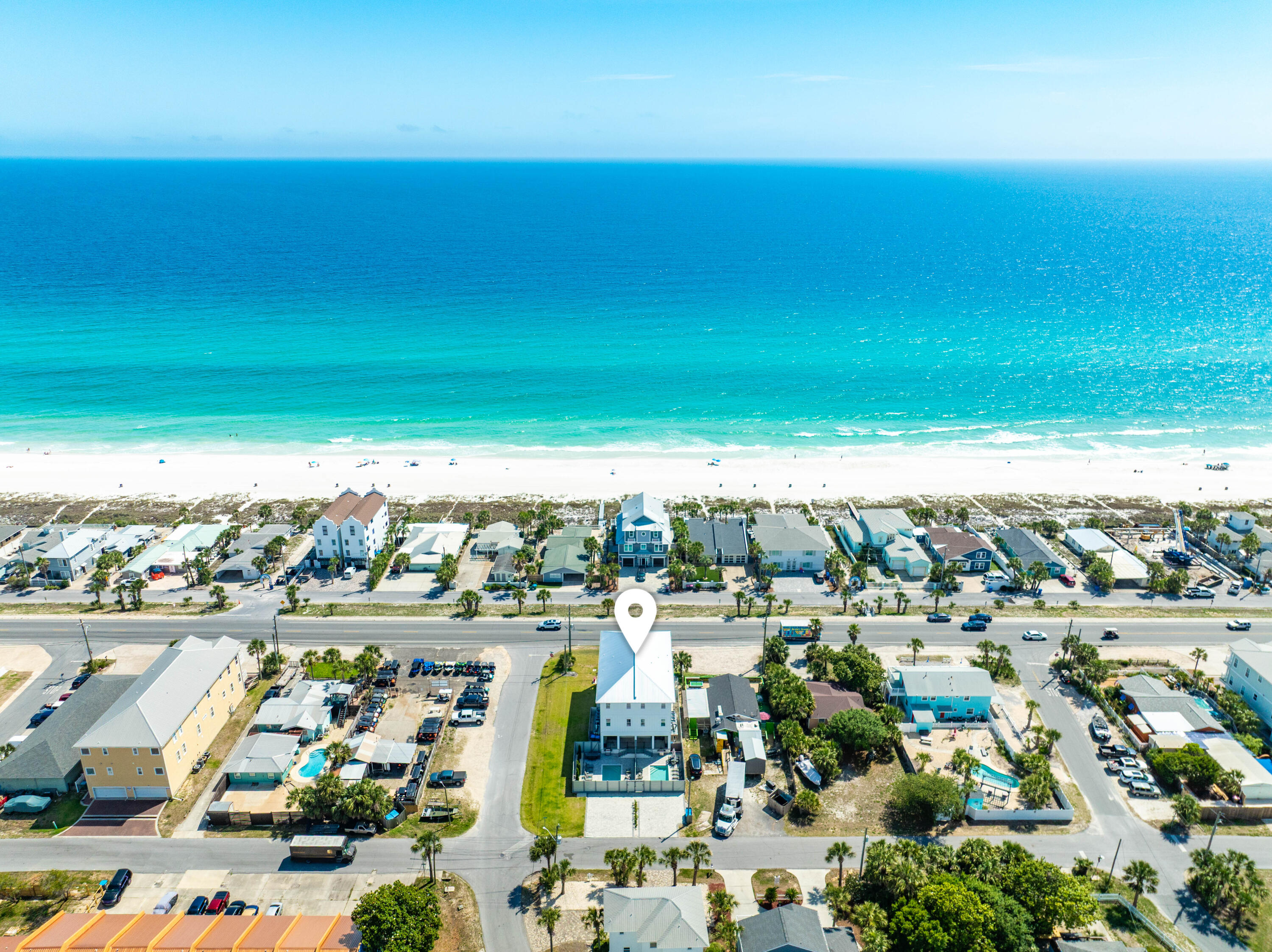 A newly built coastal townhome on Front Beach Road in Panama City Beach -- one of only two attached residences -- offered fully furnished and turnkey, living like a private home with its own entrance, its own fenced pool, and dedicated paver parking. The home sits directly across Front Beach Road from the sugar-white sand and emerald water of the Gulf, with two public beach accesses just a short walk away. Open Gulf views unfold from the main living level and the top-floor primary suite, while a private elevator quietly connects all three floors.
At the heart of the home, a designer kitchen is appointed with white shaker cabinetry, a quartz waterfall peninsula, premium stainless appliances, and a statement tile backsplash, opening to a generous dining space and a Gulf-view balcony framed for sunset. A level below, a dedicated game room -- pool table, air hockey, foosball, and a wet bar -- flows to the backyard, where a private pool and paver sun deck are paired with an outdoor kitchen and grill.
The third-floor primary is a retreat unto itself: a king suite opening to its own Gulf-view balcony, with a spa-inspired bath in marble-look tile, a dual vanity, and a walk-in closet. Additional bedrooms on every level -- several with two beds, plus a children's bunk room -- graciously accommodate large gatherings.
Minutes to M.B. Miller Pier, Pier Park, and Topgolf -- an exceptional primary home, second residence, or Gulf-view investment in Panama City Beach.
 Designed across three floors with nine-foot ceilings and wide-plank wood-look flooring, the plan places a full level of living between the entry and the bedrooms above.
The ground floor is the social hub: the recreation room is served by a full bath and opens directly to the fenced backyard, while a guest bedroom with ensuite bath, a generous home office, and a second laundry room complete the level.
The mid-level holds the open kitchen, dining, and living, with two additional bedrooms and a powder bath set apart for guests.
The top floor is devoted to the primary suite, joined by two further bedrooms, a full laundry room, and a wet bar just outside the suite.
Poolside, lounge seating and alfresco dining round out the fenced deck, and dedicated parking accommodates four vehicles.
