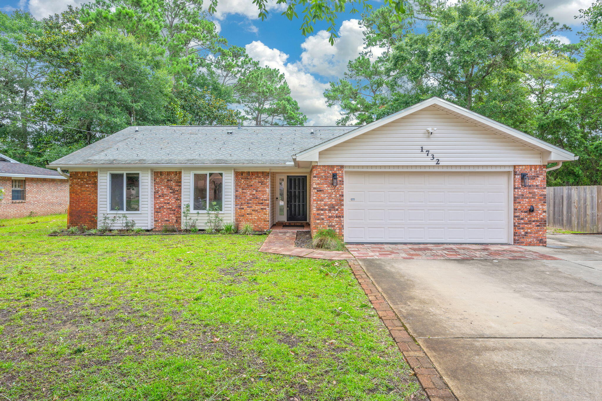 Welcome to this spacious brick ranch, offering the perfect combination of low-maintenance living, convenience to all area bases, and a layout designed for entertaining. Inside, you are greeted by a sunken great room highlighted by a brick gas fireplace, recessed lighting, and crown molding that flows throughout the home. This home features zero carpet, instead boasting tile flooring throughout every room for ease of upkeep. The heart of the home is the open-concept kitchen equipped with granite slab countertops, custom cabinetry, a built-in desk area, and a large central island that is as functional as it is beautiful. You'll love the premium stainless steel appliance package, including a gas range, microwave, and refrigerator, all anchored by a deep porcelain farmhouse sink. Retreat to the private and generously sized master suite, featuring double-door hallway access. The master bathroom features a large walk in shower with stunning glass-block windows for maximum natural light, and an expansive walk-in closet with built-in organization. Step out back into your own private, fully fenced outdoor oasis. Relax in the shade of the screened porch or the covered patio, both overlooking a gorgeous swimming pool installed new in 2019. The expansive yard also features two detached yard buildings providing abundant extra storage. With a brand-new hot water heater (2023), a freshly painted interior, and a location that keeps you close to local amenities, this move-in-ready gem offers incredible potential and an unmatched lifestyle. Seller will replace the roof prior to closing with an acceptable offer.