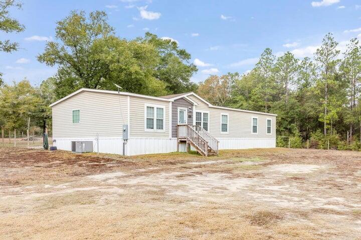 2 Acres! Spacious manufactured home on a quiet country road. Features 2 large living rooms, large kitchen, all appliances stay. Primary suite has it's own master bath and closet.