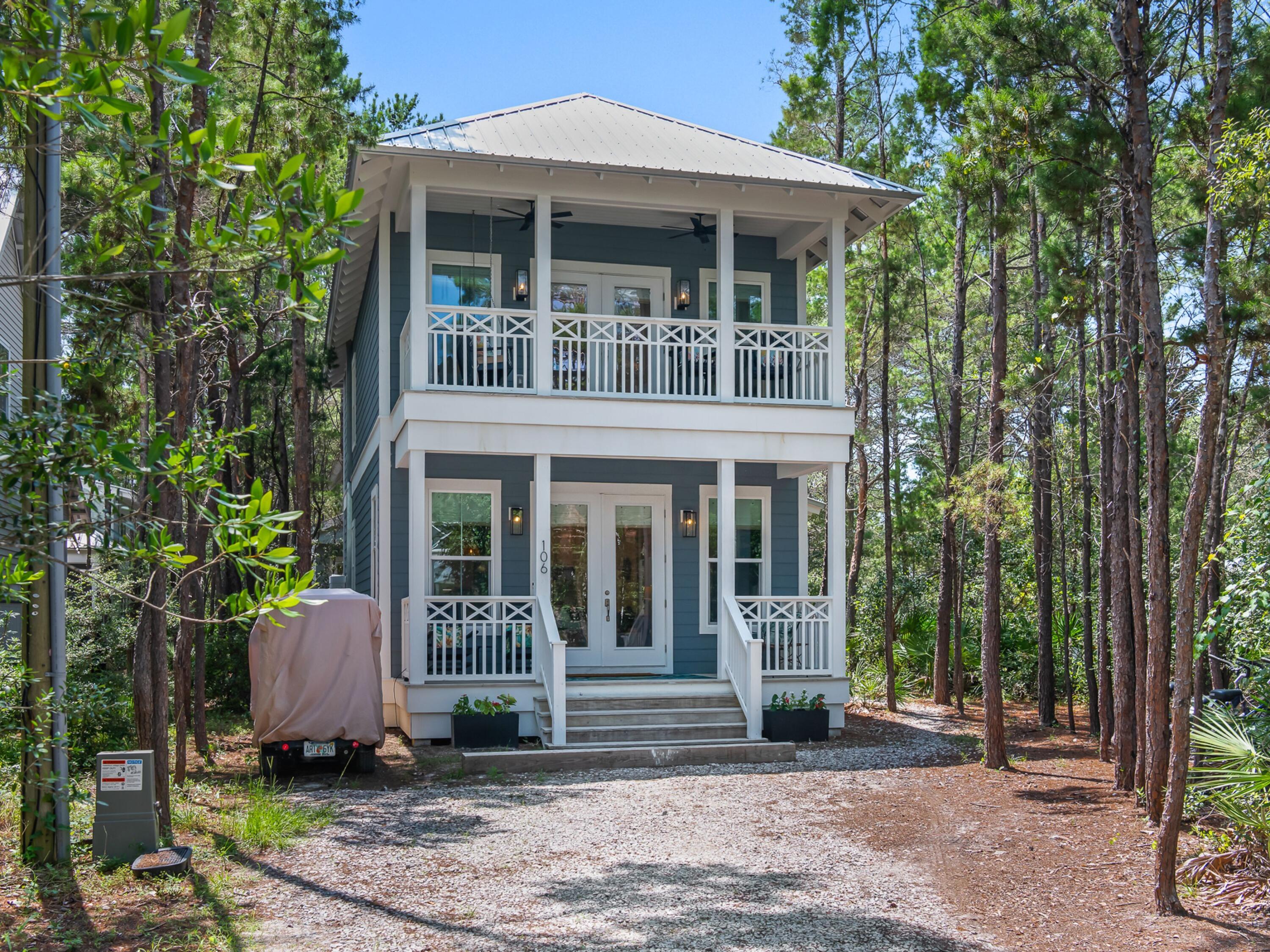 Custom designed and built by the owner, this 2022 coastal cottage sits south of 30A in the desirable Eastern Lake neighborhood, just a short distance from the beach access. Set on a corner lot bordered by adjacent greenspace, the home offers privacy galore on a quiet, wooded street close to the beach. The two-story Hardie board home features two bedrooms plus a custom built-in bunk room and 2.5 baths, with hardwood floors throughout and an open main level connecting the kitchen, dining, and living areas.

The kitchen showcases quartz countertops, a gas range, stainless appliances, and a center island with seating, finished with woven shades and rattan pendant lighting. A floating wood-and-steel staircase anchors the living space, while stacked covered porches front and back extend the living outdoors. The primary suite includes grasscloth walls and a private balcony, and the guest bedrooms offer their own porch access. Outside, a fenced yard with mature landscaping and a garden arbor adds to the home's charm and seclusion.

A short stroll to the beach access, this turnkey home is an ideal second home or investment property in one of 30A's most established beach communities. Currently a strong-performing rental, it's truly move-in ready. Walk to the beach within 4 to 6 minutes!