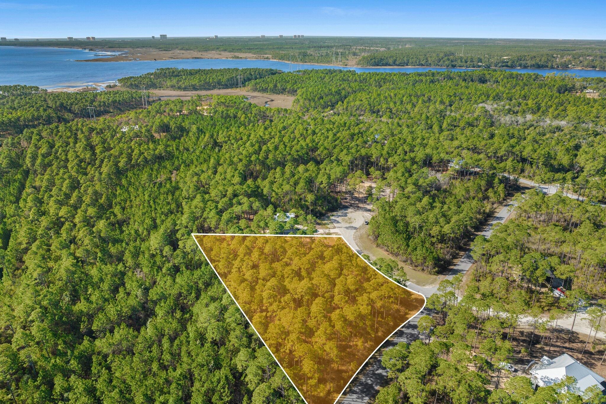 1.37-Acre Premium Homesite in RiverCamps - Build Your Dream Home! Discover the perfect canvas for your custom home on this expansive 1.37-acre corner lot in the exclusive RiverCamps at Crooked Creek community in Panama City Beach. Bring your vision to life or save time and money by taking advantage of already completed architectural plans from the Seller! This private residential community and wildlife sanctuary is truly one-of-a-kind and was designed with nature and water lovers in mind.