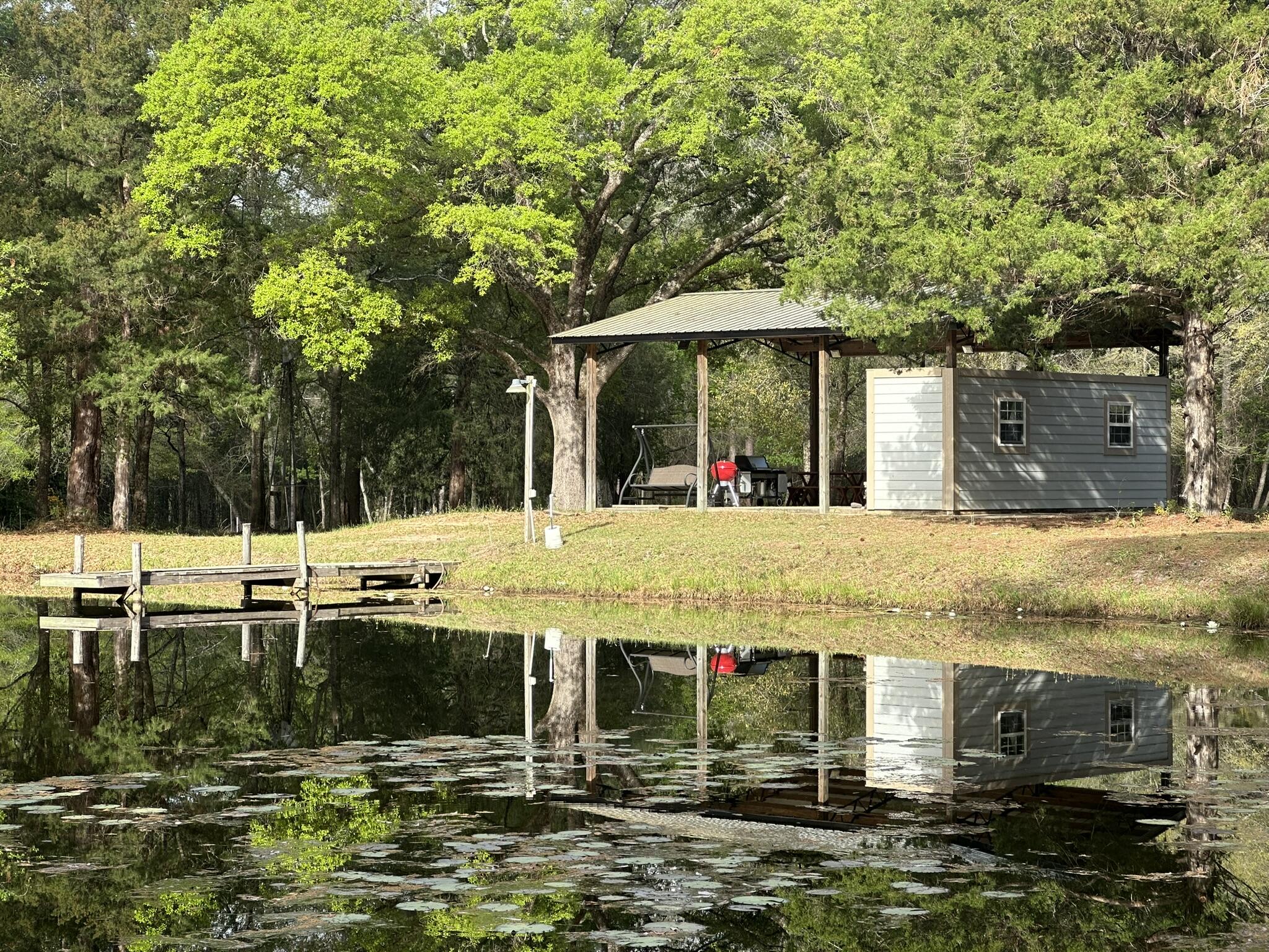 A rare opportunity to create a true showpiece estate, this property is positioned for a high-value homesite with exceptional long-term potential. Three private ponds create a striking waterfront setting stocked with pet fish galore, delivering both visual appeal and recreational use. Existing power and water, along with a pole barn and pavilion, provide immediate functionality and support future expansion. A Pavillion allows for immediate use while planning a larger residence or RV. The layout supports flexibility, including the potential for a minor land division. Positioned in a growing area with shopping, airports, Eglin AFB, and Gulf Coast beaches within reach, this property offers presence, versatility, and lasting value. Agents must be present for showings.