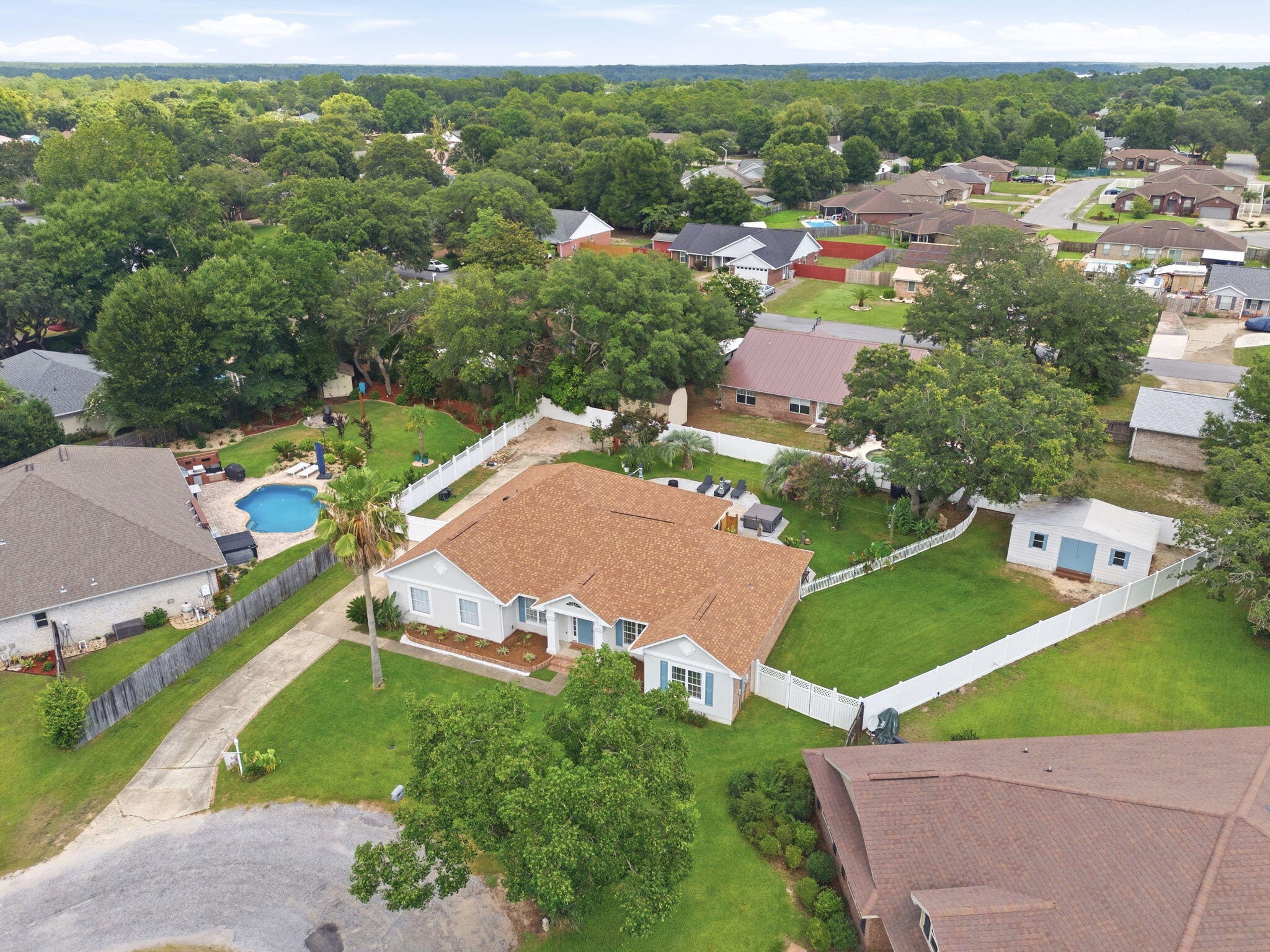 Welcome to one of Navarre's most sought-after neighborhoods--Tom King Estates. Known for its winding streets, towering oak trees, shaded sidewalks, and welcoming atmosphere, this is the community everyone talks about. Whether you enjoy morning walks with the dogs, evening bike rides, or simply being surrounded by nature, you'll quickly understand why homes here are so highly desired.

Nestled on a quiet cul-de-sac, this beautifully redesigned pool home has been thoughtfully updated inside and out while offering a floor plan that is rarely found. One of its standout features is a true private mother-in-law suite complete with its own kitchen, living room, bedroom, and direct access to the backyard and pool. Whether you're accommodating multigenerational living, caring for a loved one, hosting long-term guests, or creating a private roommate arrangement, this flexible space offers endless possibilities.

The main living area features a desirable split-bedroom design, providing privacy for everyone in the home. Recent improvements throughout include updated flooring, lighting, hardware, and numerous modern finishes that create a fresh, move-in-ready feel. Step outside and discover your own private retreat. The beautifully landscaped backyard showcases a fiberglass swimming pool, outdoor shower, lush irrigation, mature landscaping, fruit trees, and plenty of room to relax or entertain. Need space for your hobbies and toys? You'll appreciate the oversized workshop along with generous parking for multiple boats, RVs, trailers, or additional vehicles.

Additional highlights include a 2020 roof, hurricane protection that may help reduce insurance costs, a septic system that was pumped and inspected last year, and a new water heater scheduled for installation before closing. The HVAC system is believed to have been replaced around 2019; buyers are encouraged to verify all information during their inspections.

Best of all, this property is located outside of a flood zone, so flood insurance is not required, and there is no HOA--giving you the freedom to truly enjoy your property.

As an added bonus, homeowners have the opportunity to obtain bay access through the neighboring Robledal community with a one-time membership fee, offering convenient access to one of Navarre's most treasured natural resources.

This home has been professionally cleaned and is truly move-in ready. Please help protect the brand-new flooring by wearing the complimentary shoe covers provided at the front door.

Pool homes in Tom King Estates rarely become available--especially those offering this level of flexibility, privacy, and outdoor living. If you've been waiting for the perfect place to call home, this may be the one you've been searching for.