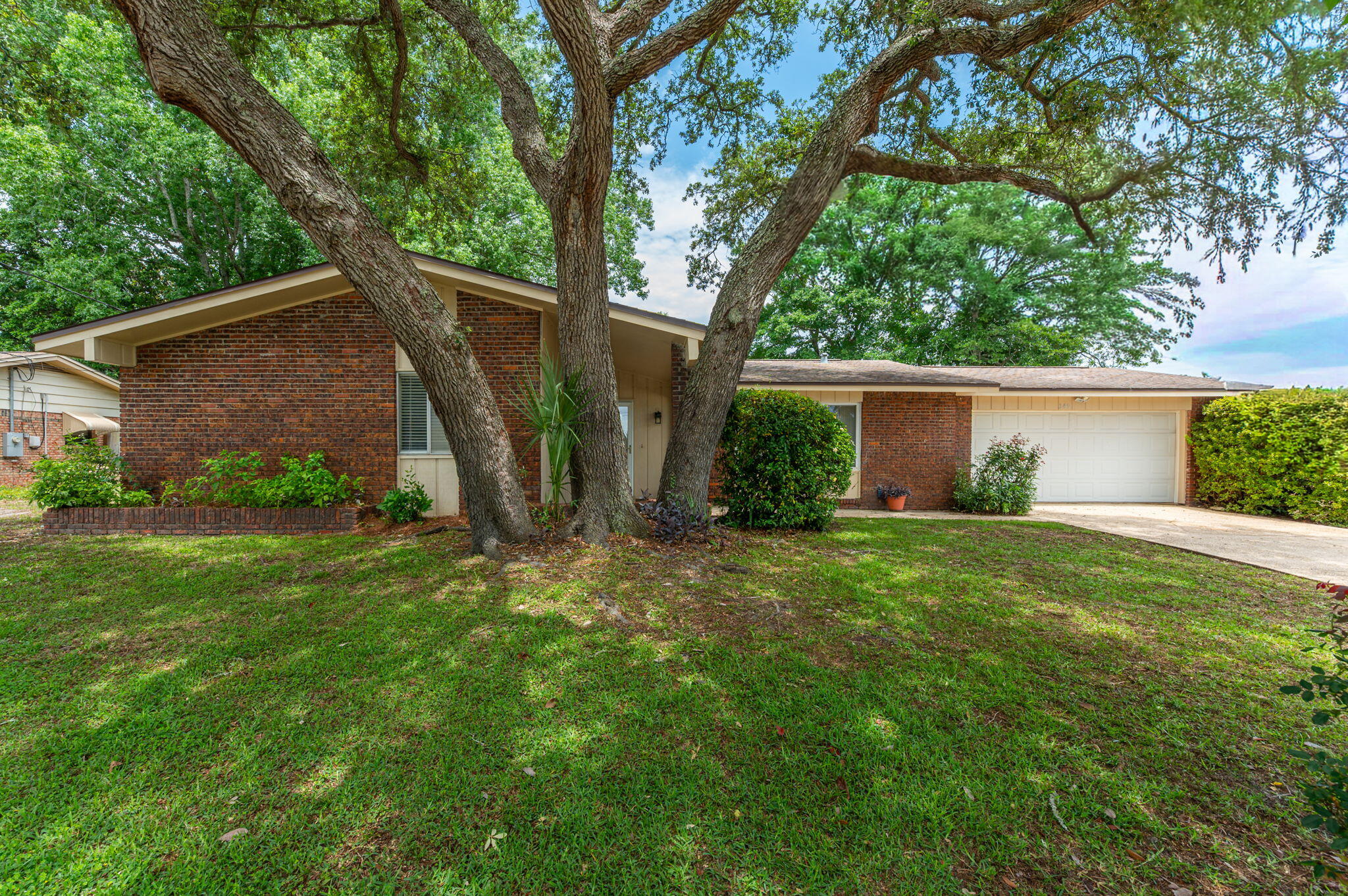Showings start Saturday.
Located in the center of Fort Walton beach and close to both Hurlburt and Eglin, this move-in-ready home checks all the home-search boxes. You will enjoy sidewalk-lined streets, and quick access to the beach and bay! Inside, the open floor plan is designed for living. Renovated  kitchen features tons of counter space, breakfast bar, a gas stove, abundant drawers and storage, a built-in pantry storage and charging area, and upgraded details like a pull-out trash drawer. The flexible layout includes two separate living spaces and a built-in office area. Upgraded tile floors in all living and wet areas, and new carpet adds coziness to the bedrooms. All bedrooms feature ceiling fans. Private backyard retreat with a covered porch, extended concrete patio, privacy fencing, mature trees, and a sprinkler system. Additional highlights include a large two-car garage, gas water heater and brick exterior. HVAC was installed 2017 and Water heater was installed 2021.  Seller will replace roof with acceptable offer.