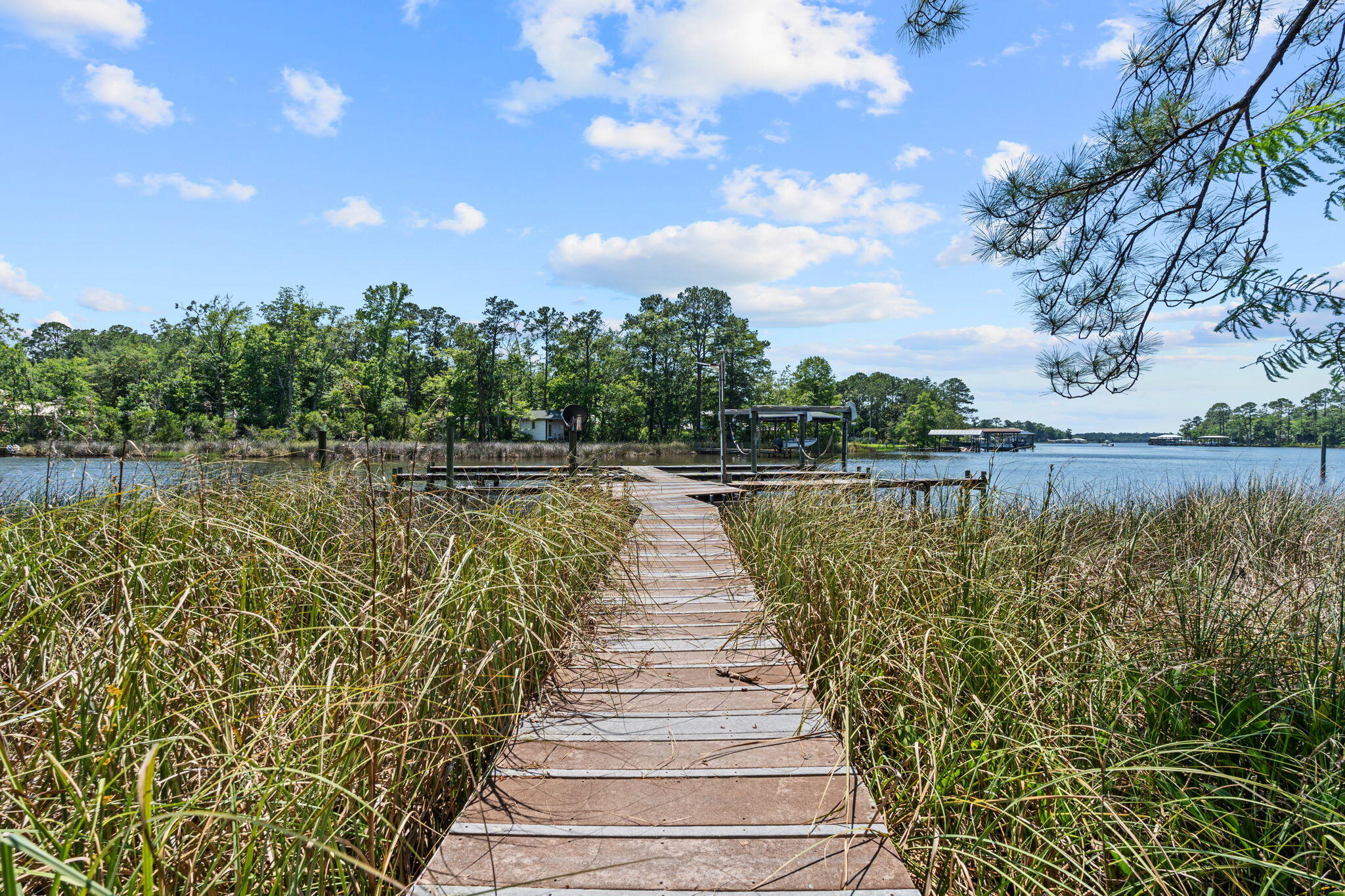 Waterfront living meets functionality and freedom at this exceptional property on Mallet Bayou Road in Freeport. Situated on beautiful Mallet Bayou with approximately 100 feet of water frontage, this property offers direct access to boating, fishing, kayaking, and enjoying the natural beauty of the bayou right from your backyard, with convenient access to Choctawhatchee Bay and the Intracoastal Waterway.

Designed for both comfort and versatility, the property features a private dock with four slips and a boat lift capable of lifting up to 3,000 lbs, making it ideal for boating and waterfront recreation. A spacious screened porch overlooks the water and provides the perfect setting for outdoor dining, entertaining, or simply taking in the peaceful views.

The home includes a wood-burning fireplace, double pane windows, foam insulation in the attic, and durable Hardie board siding. A new metal roof installed in 2024 adds long-term value and peace of mind.

In addition to the attached 2-car garage, the property offers extensive additional storage and workspace options including a detached garage/workshop, RV pole barn, carport, greenhouse, and mower shed. With no HOA and unrestricted use, the property provides flexibility for a variety of uses.

Conveniently located near Freeport amenities, marinas, dining, and the beaches of South Walton, this waterfront property combines coastal access, usable space, and practical improvements in a unique bayou-front setting.