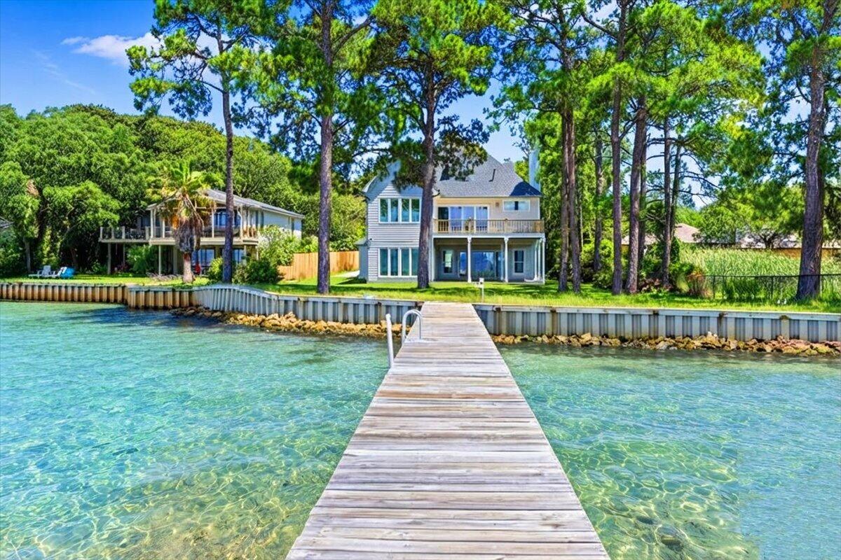 Welcome to one of Destin's most unique waterfront estates. Situated on nearly an acre with approximately 88 feet of frontage on Choctawhatchee Bay, this fully renovated 6-bedroom, 5-bath estate offers luxury, privacy, and breathtaking waterfront views.

Tucked behind a private gated entrance and surrounded by mature trees, the property feels like a secluded retreat while remaining just minutes from Destin's beaches, dining, shopping, and entertainment. Offering 4,859 square feet of living space, the home features a waterfront primary suite with a private balcony overlooking the bay, five additional bedrooms, and spacious indoor and outdoor living areas designed for entertaining.

Outside, enjoy an expansive two-level deck, private dock, and approximately 88 feet of bay frontage. Spend your days boating to Crab Island, waterfront dining along Destin Harbor, fishing from your dock, or simply relaxing as the sun sets over the bay.

A detached three-car garage provides ample room for vehicles, golf carts, and water toys, while the nearly one-acre homesite offers a rare sense of privacy. With no HOA, this exceptional bayfront property delivers the space, freedom, and waterfront lifestyle that make living on the Emerald Coast so special.
