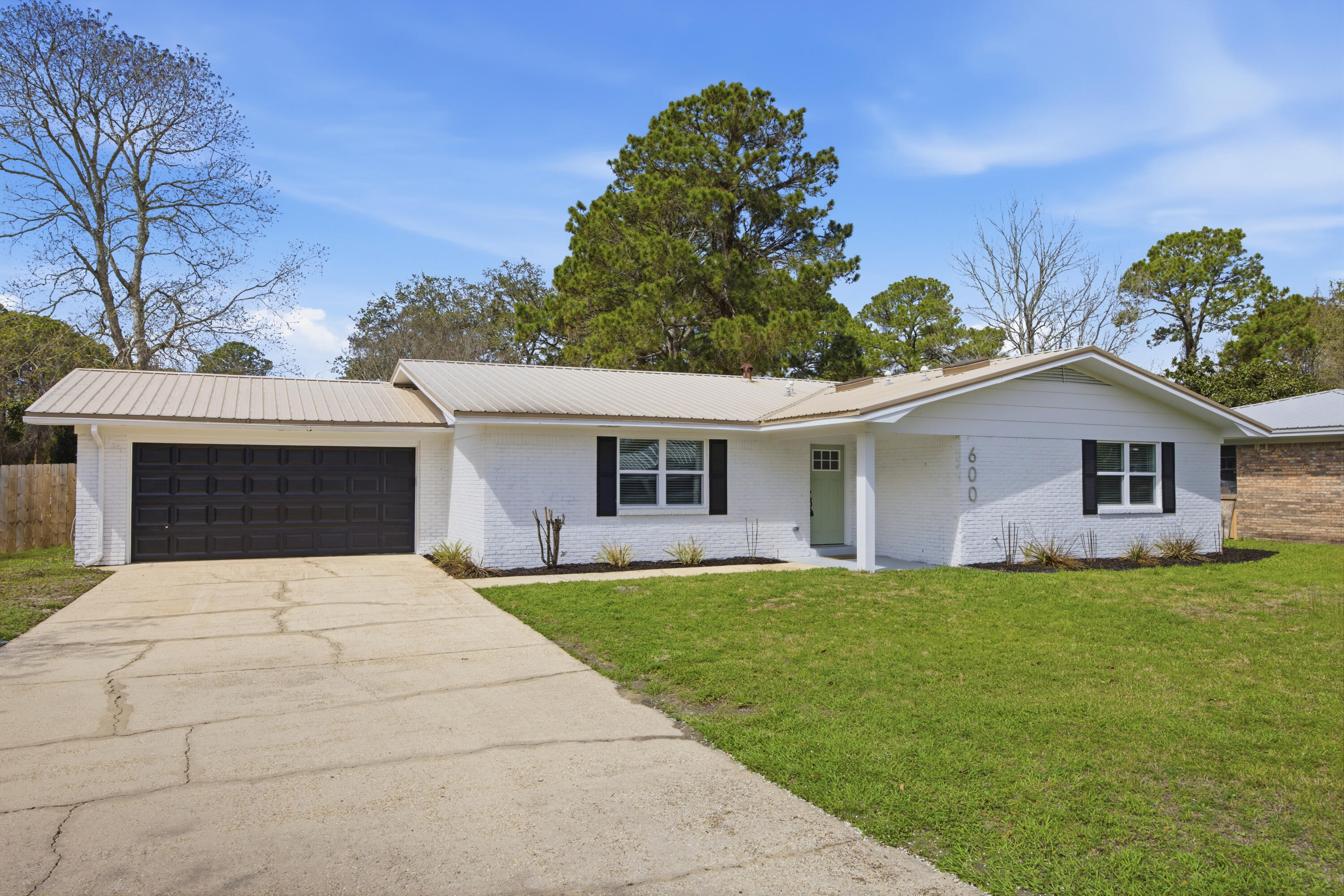 Discover modern comfort at 600 Burgundy Lane in Fort Walton Beach, where thoughtful updates and stylish finishes come together on a spacious corner lot. Inside, the home features a neutral designer color palette, luxury LVP flooring throughout, and an open-concept layout ideal for both relaxing and entertaining.

The updated kitchen serves as the heart of the home with quartz countertops, stainless steel appliances, designer lighting fixtures, and seamless flow into the living and dining areas. The living room is highlighted by a charming wood-burning fireplace, creating a warm focal point for the space.
Stylish upgrades continue throughout the home with updated bathrooms featuring tile finishes, wood vanities, and modern fixtures. Decorative, upgraded lighting add character, while new int erior paint and updated doors provide a fresh, polished look. The home also offers abundant storage with multiple closets throughout.

Step outside to enjoy the covered back porch, perfect for relaxing or hosting gatherings, along with a large powered storage shed that adds functionality and extra storage space.

Conveniently located just minutes from shopping and dining along Beal Parkway, this home is approximately 10 minutes from the white-sand beaches of Okaloosa Island and offers an easy commute to both Eglin Air Force Base and Hurlburt Field. Combining thoughtful upgrades, modern style, and a prime location, this property offers the ideal blend of comfort and convenience along the Emerald Coast.