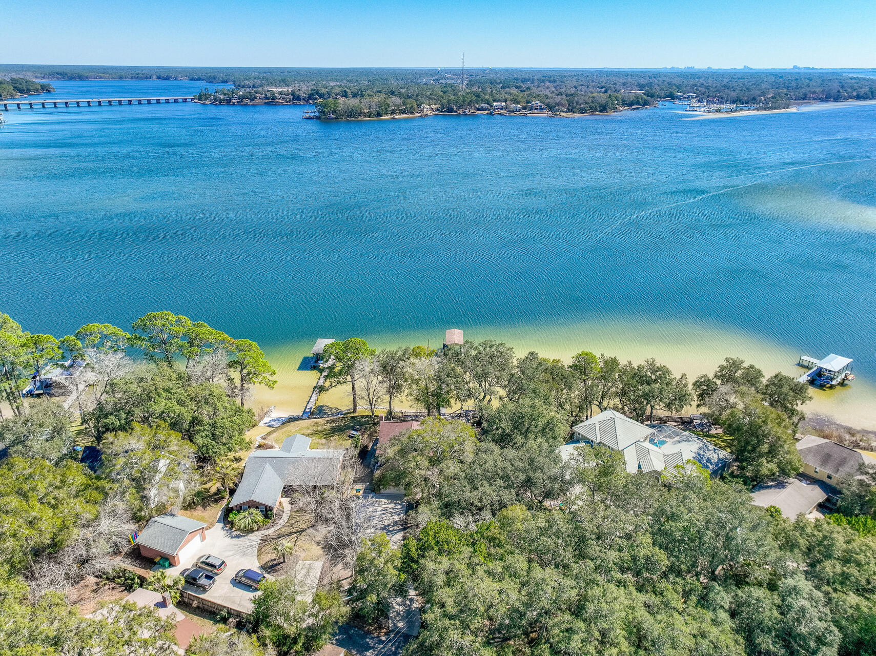 CAREFREE waterfront living on a protected deep-water lot with 166' on Rocky Bayou!! This charming home is located on a private .68-acre lot on Rocky Bayou with panoramic views across the bayou from the Rocky Bayou bridge out towards Choctawhatchee Bay. Along with a HUGE yard, this home also comes with a double seawall as well as a dock with both a boathouse and a sailboat slip. The home was renovated in 2015 with the addition of a large kitchen, family room, dining room, office and master suite downstairs that offer captivating water views that take your breath away!! The kitchen is a chefs dream with an abundance of custom cabinets, beautiful granite counter tops, stainless appliances, a walk-in pantry and a large island breakfast bar. The kitchen is open to the family room accented with gorgeous wood ceiling beams that complement the hardwood floors and beautiful granite fireplace. The dining room is open to both the family room and kitchen and can accommodate oversized furniture. Just down the hall, you will find an office with double pocket doors for privacy. Adjacent to that is the master suite offering amazing bayou views and pampering you with a luxurious bath featuring 2 vanities, a jetted tub, a walk-in shower and a walk-in closet. Both the master bedroom and family room have doors to the screened porch where you will spend countless hours enjoying the gorgeous sunrise in the morning, the gentle bayou breeze in the afternoon and the spectacular moonrise at night! Upstairs you will find another large master suite overlooking the bayou with two walk in closets and a private bath. There is also a convenient loft area as well as two additional bedrooms and another full bath. One of the upstairs bedrooms was expanded and offers a large sitting area as well as a walk-in closet.

Enjoy life on the bayou by enjoying the views from the back deck, sitting around the firepit, having a bar-b-q on the paver patio or sipping a cup of coffee on the screened porch while watching the sun rise. The dock offers a kayak platform as well as a covered boathouse and a boat slip for a sailboat. The property is protected by a seawall with rip-rap and a retaining wall as well. This is the "trifecta" of waterfront properties...1. Protected DEEP water, 2. AMAZING views and 3. NO FLOOD INSURANCE required because of the elevation of the lot!

Practical notes: roof (2013 reroof, 2015 addition roof, 2023 master bedroom roof), HVAC systems (2024 upstairs, 2019 & 2015 downstairs), tankless water heater (2025),

Welcome home and enjoy carefree waterfront living ''sittin' on the dock of the bay watchin' the tide roll away..
