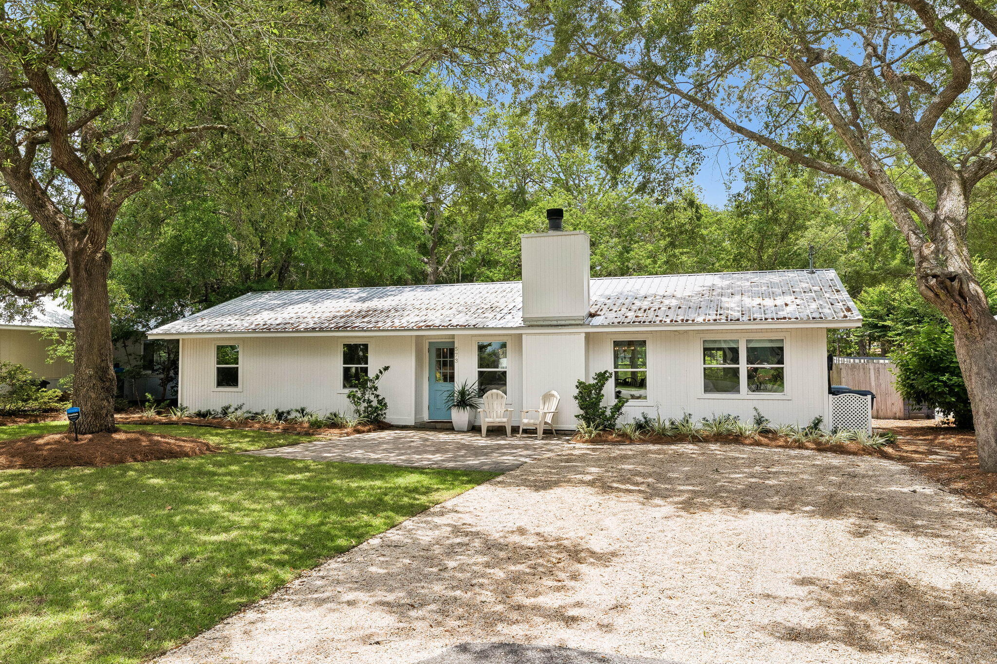 Tucked into the Daughettes neighborhood of Point Washington, this renovated four-bedroom, home sits on a rare quarter-acre lot framed by mature oaks draped in Spanish moss. Quarter-acre parcels are genuinely hard to come by in this part of Santa Rosa Beach, and this one delivers the kind of space, privacy, and old-Florida character that newer communities simply cannot replicate.
The interior has been thoughtfully reimagined. The main living area features shiplap walls, wood ceilings, and a stone fireplace painted in soft white, anchoring a space that feels light, layered, and easy to live in. The kitchen is the showpiece: a generous island with seating for four, quartz countertops, a porcelain farmhouse sink, brass hardware, stainless appliances, open wood shelving, and a tile backsplash that runs to the ceiling. A bright breakfast nook with a built-in window seat sits just off the kitchen, with a dedicated dining area opening to the main living space.
The primary bedroom features a vaulted, wood-paneled ceiling that gives the room an airy, cottage-like feel. A flexible bonus room rounds out the floor plan and works equally well as a home office, playroom, or guest space.
Outside, the backyard is the kind of space families look for and rarely find. A fully fenced yard with a wide green lawn opens to a fire pit area tucked under the oak canopy, with a paver patio extending off the back of the home. There is room here for kids to run, dogs to roam, and evenings around the fire. Location is the rest of the story. Daughettes is a quiet, old-Florida neighborhood surrounded by Point Washington State Forest, with forest access just off West Point Washington Road and miles of trails at your doorstep. For boaters, Tom's Landing Boathouse and Marina sits just down Ricker Ave, the only marina in South Walton County, offering covered and lifted slips with direct access to Choctawhatchee Bay. Grayton Beach and the sugar-white sand of the Gulf are roughly ten minutes south, with Seaside and the shops and restaurants of Scenic 30A close behind.
Renovated, private, and positioned in one of Point Washington's most insulated pockets, 573 Ricker Ave is the rare combination of a move-in-ready home and irreplaceable location.