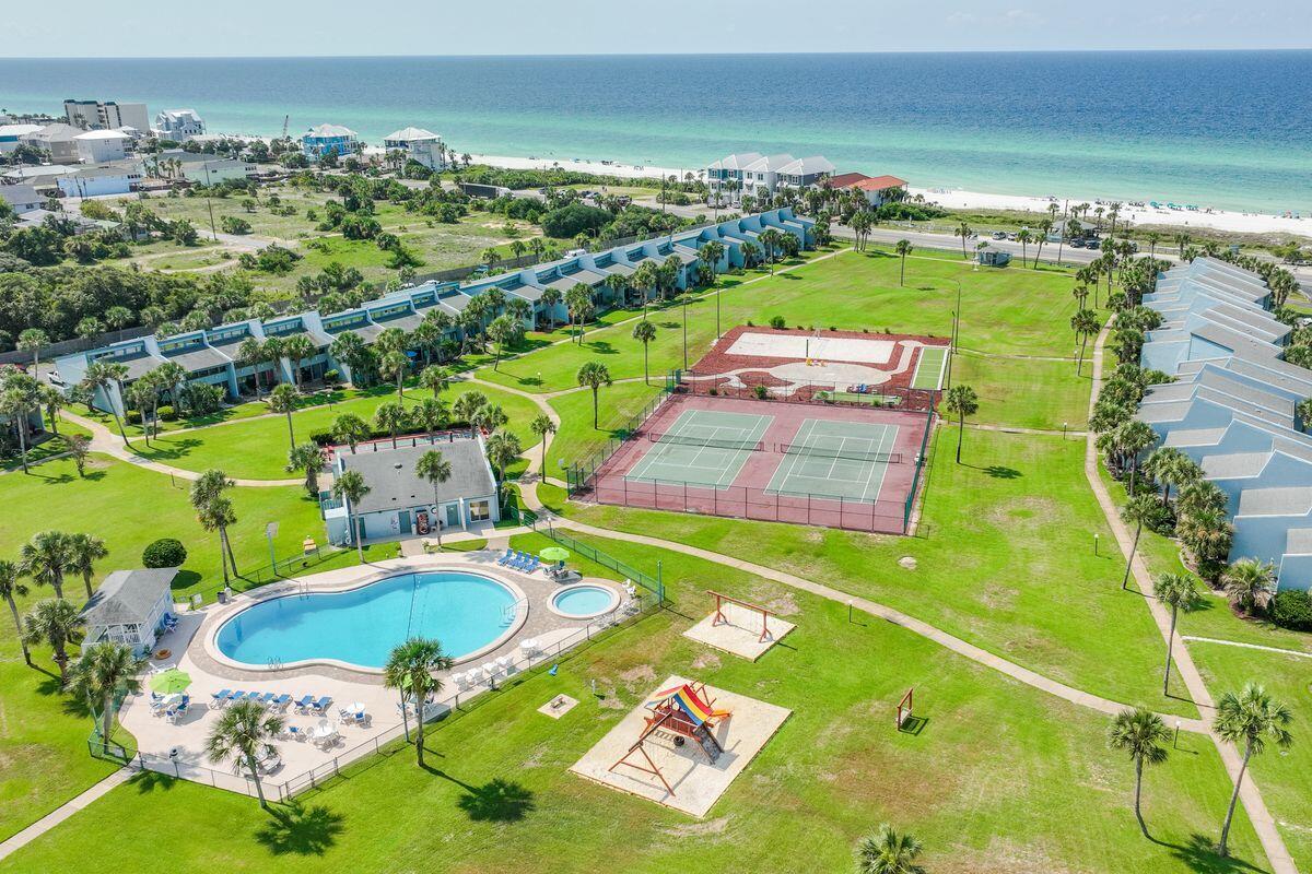 This two-story townhome/condo is located in the sought-after Sunnyside Beach & Tennis Resort- offering unmatched proximity to the soft sands and shimmering waters, delivering unparalleled shoreline and sunset vistas from its patio and common areas. The coastal decor encapsulates the beach experience from the very moment you step inside. This two-bedroom unit doesn't just cater to the aesthetics, it understands the nuances of  vacation living with updated appliances, granite counters, bathrooms, HVAC, and hardwood floors on the 2nd level, unit 48 is rental ready. The Sunnyside Resort offers immediate access to 350' of private beach, only heightening its allure. Moreover, with a very reasonable HOA fee, this gem makes for an excellent avenue for rental income or as a cherished second home. Beyond the unit, Sunnyside Resort promises a holistic experience. Acres of green envelope the communal lagoon pool and spa, ensuring moments of relaxation. For those with a zest for action, tennis and volleyball courts await. Children find their haven in the playground, and beach lovers will appreciate the secure and quick access to the private beach via an underground tunnel. Sunnyside Beach and Tennis Resort distinguishes itself from the customary high rises that span Panama City Beach. Spreading over 18 lush acres, this retreat is an oasis where guests, regardless of age, can traverse from sandy beaches to tennis courts, from a glistening pool to a delightful playground. Every unit promises unparalleled privacy with two dedicated parking spaces leading right to the doorstep. Unit 48 isn't just a residence; it's an experience in a community that's highly coveted and seldom available in the market. And as an added perk, if the new owner has a boat or RV, it can be stored in the back of the community for an additional monthly fee. This truly is coastal living at its finest.