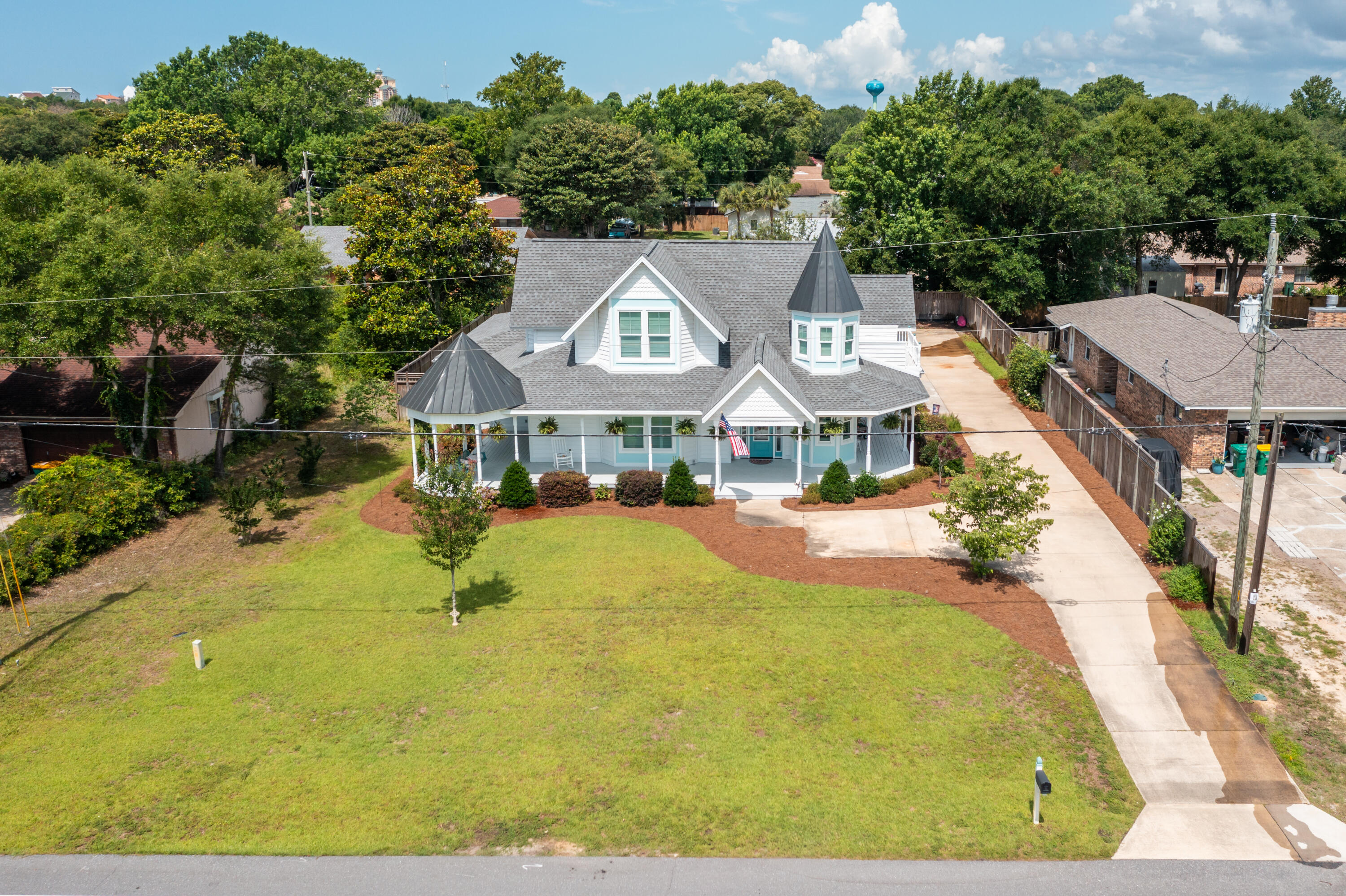 Experience the charm and character of this exceptional Victorian-inspired residence, masterfully built by acclaimed local builder David Meyer. Showcasing timeless architecture, a distinctive turret, and an inviting wrap-around porch, this home blends classic elegance with modern comfort in a highly desirable location near the Emerald Coast's renowned beaches, shopping, and dining.  Inside, the thoughtfully designed floor plan offers seamless flow between the living, dining, and kitchen areas, creating the perfect setting for entertaining and everyday living. A cozy fireplace anchors the main living space, while the chef's kitchen impresses with quartz countertops, stainless steel appliances, a gas cooktop, custom cabinetry, and stylish designer finishes.  The formal dining room is truly unforgettable, highlighted by a stunning domed ceiling featuring hand-painted cloud details that add a touch of artistry and sophistication. The spacious first-floor primary suite serves as a private retreat, complete with a sitting area, spa-inspired bath, dual vanities, an oversized walk-in closet, and a relaxing soaking tub.  Upstairs, you'll find three additional bedrooms along with the home's signature turret room--a magical space ideal as a reading nook, home office, or creative retreat.  One of only five beautifully crafted Victorian-style homes on the street by the same respected builder, this property offers a rare opportunity to own a truly distinctive residence. Enjoy convenient access to world-class fishing, sugar-white beaches, premier shopping, excellent dining, and all that the Emerald Coast lifestyle has to offer.