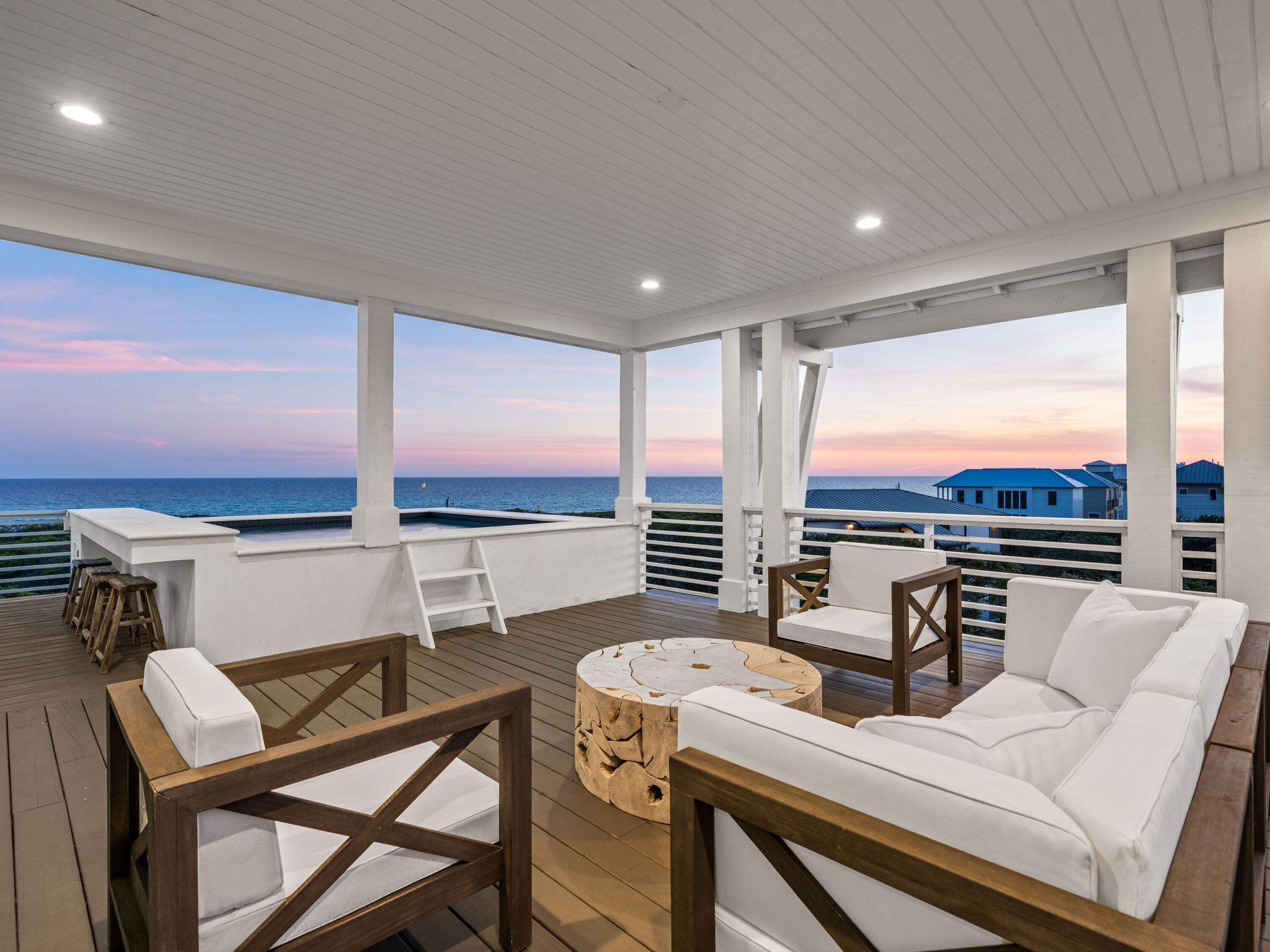 A rare opportunity just steps from the Gulf, this four-level custom home in the community of Mala Beach represents a standard of construction with features rarely seen on the Emerald Coast. Built as a personal home, every material and finish was hand curated -- and it is evident throughout the residence. Spanning an immaculate 6,018 square feet with an elevator servicing all levels, there are four spacious primary suites with king beds and  two bunk rooms.  The first floor sets the coastal tone with a large open living area with Peacock paver floors and floor-to-ceiling Jeldwen windows allowing in a multitude of light.  A dining area, marble wet bar with sink and refrigerator, powder bath, laundry and connected garage which is currently being used as a game room complete this level. The second floor hosts two of the four primary suites, both with an all-marble bathroom featuring a freestanding soaking tub, rain head shower, and floating vanities, along with private balcony access. Also on this level are the two generously sized bunk rooms, each sleeping five guests across three singles and one full sized lower bunk, and each with a dedicated bathroom with large walk-in shower. The third floor delivers two additional king primary suites, both with direct balcony access and Gulf views. The bathrooms are equally impressive with freestanding tubs, oversized marble showers with ceiling-mounted rain heads, and dual floating vanities with Carrara marble countertops. Every bedroom in this home has been finished with the same uncompromising attention to detail; the only difficult decision will be choosing which one to claim. The fourth floor is the crown jewel of the home. A dramatic vaulted ceiling opens over a fully integrated living, dining, and kitchen space. The chef's kitchen anchors the room with a handcrafted La Cornue range that draws attention the moment you walk in, a paneled SubZero refrigerator, Italian-made cabinetry and honed Carrara marble countertops. The powder room on this level is finished in hand-made Moroccan Zellige tile. Euro Wall sliding doors open the entire living space to the magnificent rooftop deck complete with heated pool. In total, the home offers over 1,000 square feet of outdoor living space across all levels. Designed to embrace its stunning surroundings, the floor plan seamlessly flows from indoor to outdoor spaces, offering views of the majestic Gulf waters and the picturesque white beaches. This remarkable retreat is a must-see for the discerning buyer seeking the ultimate blend of serenity, style, and coastal charm. Mala Beach is a seven-home Gulf-front community in Inlet Beach, just steps from one of Walton County's best beach accesses and minutes from Alys Beach, Rosemary Beach, 30Avenue and all of the shopping and dining venues.