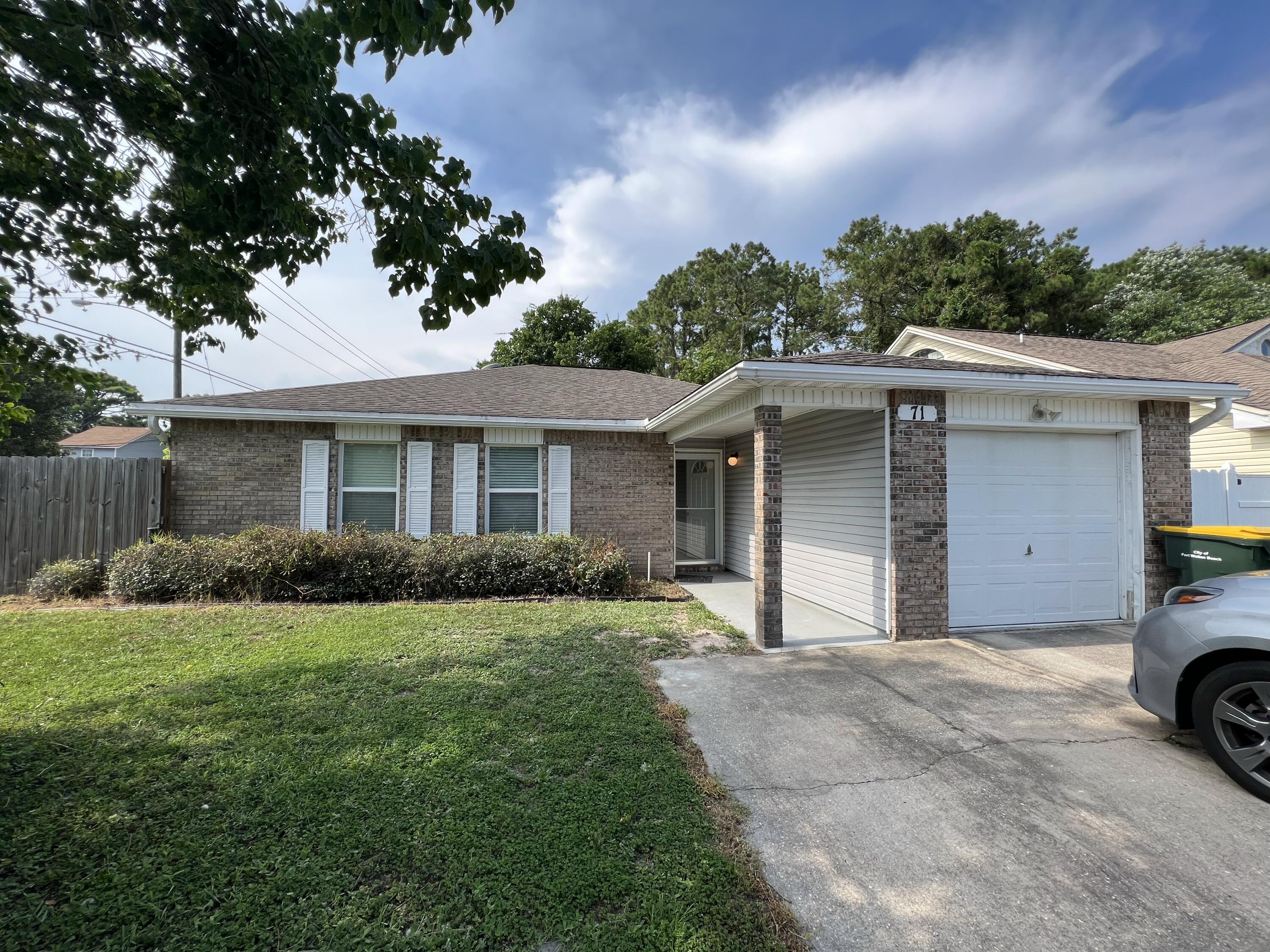 Lovely 3-bedroom, 2-bath home with a 1-car garage on a corner lot in a convenient location between Eglin Air Force Base, Hurlburt Field, and the 7th Special Forces Group, with shopping, restaurants, schools, and the beautiful Emerald Coast beaches just minutes away. This move-in-ready home features an open floor plan with vaulted ceilings, neutral paint colors, and designer tile flooring throughout--no carpet! The spacious living room flows into the dining area and L-shaped kitchen, which offers granite countertops, wood cabinets, black appliances, garbage disposal, two pantries, and abundant counter space. Both bathrooms also have granite countertops. The generous primary suite includes a walk-in closet, sit-down vanity, and a beautifully tiled walk-in shower with a glass door. A brand-new roof (current photos show the previous roof), energy-efficient 140-mph-rated vinyl replacement windows, hurricane shutters, insulated bathroom walls for added privacy and a whole-house attic fan, all contribute to exceptionally low utility bills according to the current tenants. The private, low-maintenance backyard features an impressive 40' x 20' concrete patio enclosed by a newer privacy fence, plus a separate fenced grassy side yard for pets or play. The home backs to a large water company-owned parcel, providing added privacy with no residential neighbors directly behind. Small pets may be considered with owner approval; however, no large dogs due to the limited grassy yard area.