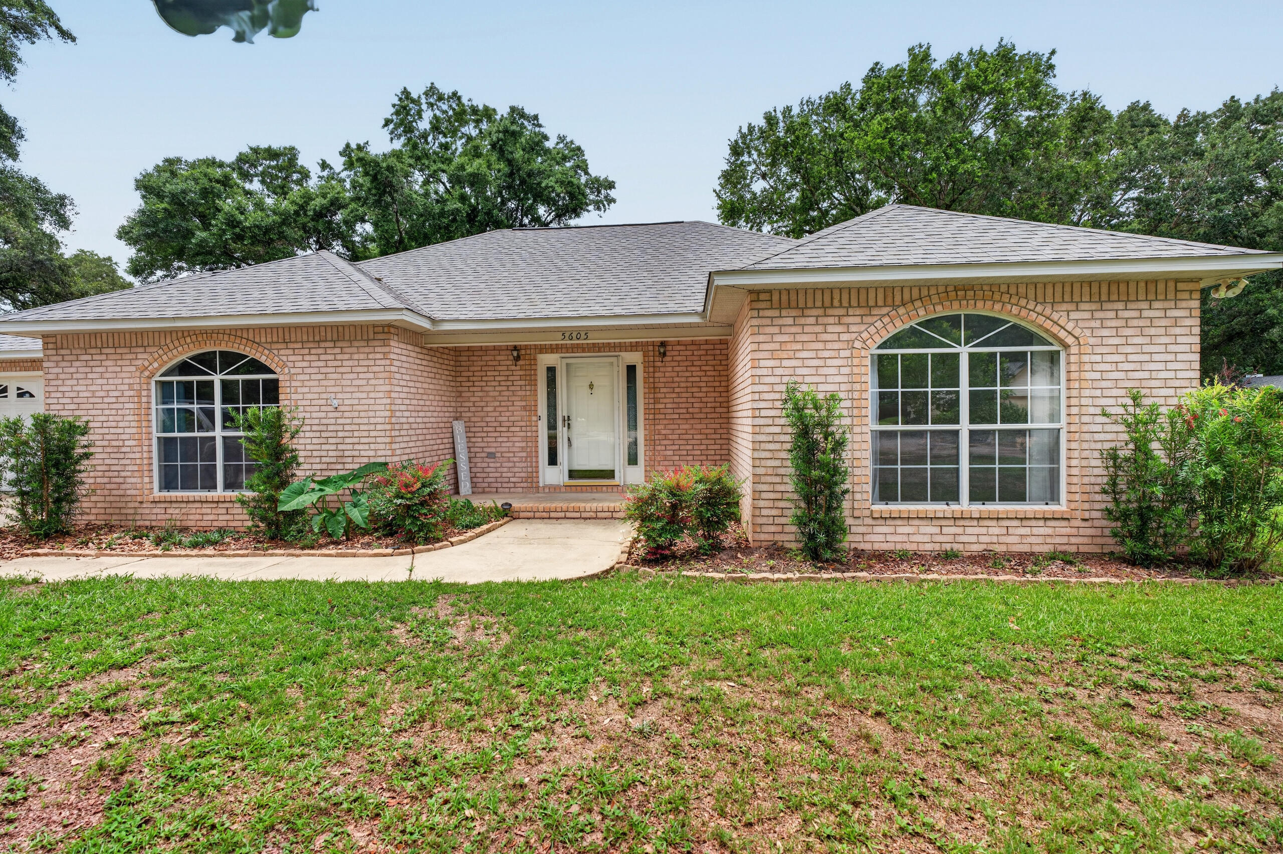 Welcome home to this beautifully maintained all-brick home nestled on a quiet cul-de-sac in one of Pace's most desirable locations. Offering nearly 2,000 square feet of living space, this 3-bedroom, 2-bath home features a spacious split-bedroom floor plan designed for both comfort and functionality.
Step inside to discover neutral flooring, soaring vaulted ceilings, abundant natural light, and an inviting great room centered around a cozy tile fireplace. Architectural details such as decorative wall sconces and plant ledges add character throughout the home. The open-concept layout flows seamlessly into the breakfast area, complete with a built-in desk and glass-front cabinetry--perfect for a home workspace or additional storage.
The well-appointed kitchen offers ample counter space, abundant cabinetry, a breakfast bar, vaulted ceiling, and newer microwave and dishwasher, making meal preparation and entertaining a breeze.
The private primary suite is a true retreat, featuring a spacious bedroom, oversized walk-in closet, built-in storage, a relaxing garden tub, and a separate walk-in shower. Two additional bedrooms and a full bath are thoughtfully positioned on the opposite side of the home for added privacy.
Outside, enjoy year-round relaxation on the oversized deck overlooking a beautifully wooded backyard with mature hardwood trees, a privacy fence, and a convenient outbuilding for extra storage. 
 Conveniently located near Five Points, shopping, dining, schools, and everyday amenities, this home combines a peaceful neighborhood setting with easy access to everything Pace has to offer.
Don't miss this opportunity to own a move-in-ready home in a highly sought-after location.