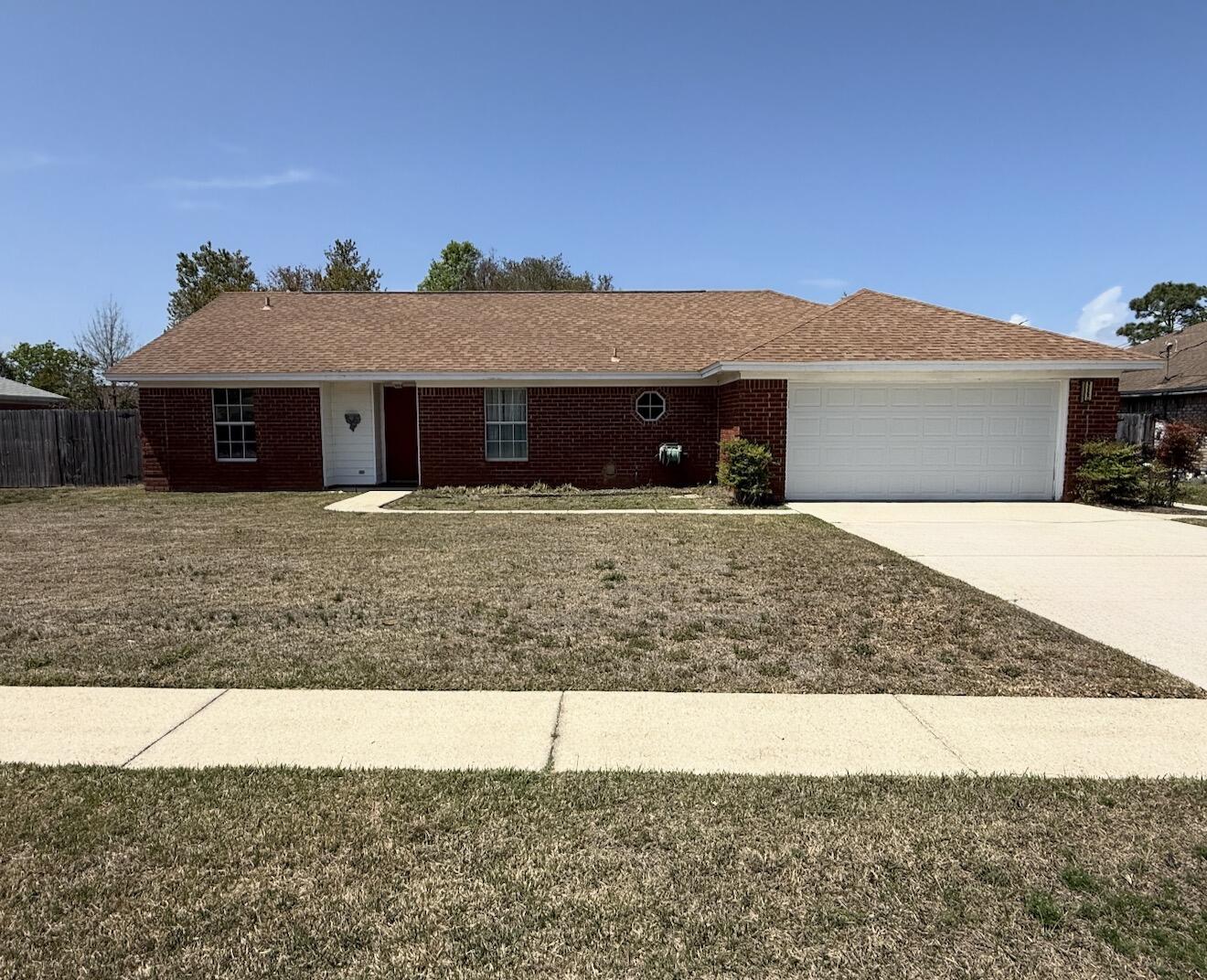 PRIME LOCATION! Ideally situated just 4 miles from the white sands of Navarre Beach and close to military bases, shopping, and dining!  This 1,656 sq. ft. brick home offers incredible value. The bright, open living area with wood flooring flows into the eat-in kitchen featuring a pantry and glass-top range. The Eat-In Kitchen has original cabinets and countertops that are clean and functional.  The primary suite boasts double vanities and an oversized tiled shower. One guest bedroom is nicely sized and the second is an impressive 24 feet long with built-in shelving and direct access to the large, screened porch - perfect for enjoying Florida's weather!  The Guest Bath has a newer vanity and the shower/tub is in excellent condition.  Outside, the privacy-fenced backyard is lush - filled with beautiful azaleas & complete with a lawn pump/sprinkler system and a sturdy storage building on a concrete foundation. Notable updates include a 2021 Rheem HVAC and a 2007 roof in excellent condition. This home is being sold AS-IS and is priced to allow for your personal cosmetic updates (flooring/wallpaper), though it is fully livable in its current state. VA buyers are welcome however, any lender-required repairs will be a buyer's expense. Don't miss this opportunity to own a charming coastal home at an affordable price--see it today!