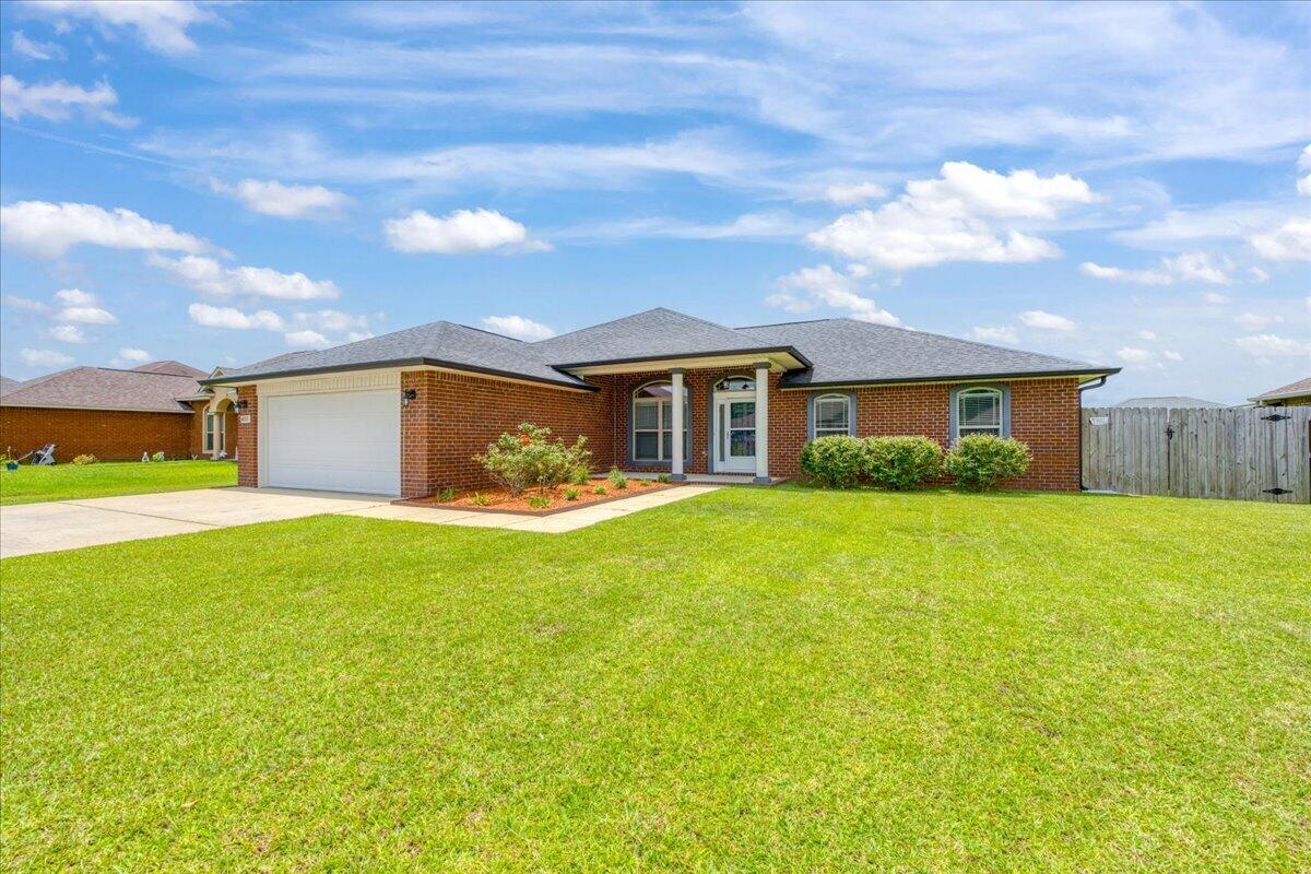 Built in 2017 and located in the well-maintained Holley-Cliff Estates community, this brick 4-bedroom home offers the benefit of no HOA while providing convenient access to shopping, schools, NAS Whiting Field, and NAS Pensacola! Inside, the open living room features vaulted ceilings, a fireplace, and abundant natural light, creating a spacious gathering area. The kitchen is thoughtfully designed with custom maple cabinetry, granite countertops, stainless steel appliances, a large pantry, and multiple dining options including a breakfast bar, bay-window breakfast nook, and formal dining area! The split-bedroom floor plan provides privacy for the primary suite, which features a tray ceiling and a spacious ensuite bathroom complete with a granite double vanity, garden tub, separate shower, private water closet, two walk-in closets, and linen storage. Three additional bedrooms are located on a separate hallway and feature hard-surface flooring with no carpet. A shared guest bathroom, dedicated laundry room, and two-car garage add to the home's functionality. Step outside to a covered patio overlooking the fully fenced backyard. The outdoor space includes a sprinkler system and a 10' x 20' storage shed, providing plenty of room for equipment, hobbies, or additional storage. Move-in ready and exceptionally maintained, this home combines quality finishes, practical living spaces, and a desirable Milton location and neighborhood!