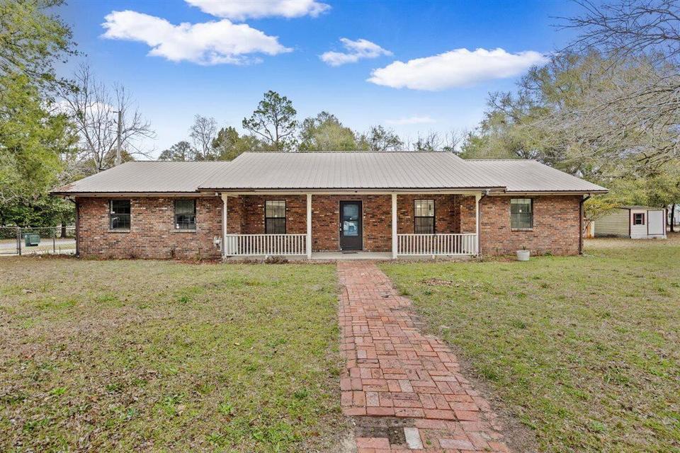 This solid brick 3-bedroom, 2-bath home offers a 2-car garage and sits on a mostly cleared lot with mature trees, providing space and privacy while still being close to town. Inside you'll find fresh interior paint and new LVP flooring in the living room, laundry room, and bedrooms. The kitchen and dining area feature tile flooring, and the home offers a comfortable, functional layout throughout. Tile flooring in bathrooms, floor to ceiling decorative tiled shower in master bathroom & hall bathroom has tiled walls around tub. The property includes two storage sheds. Conveniently located near FedEx distribution centers, I-10 & Hwy 90. Close to local springs--perfect for cooling off during the summer months. No pets, trampolines, swimming pools and no vaping/smoking inside the home.