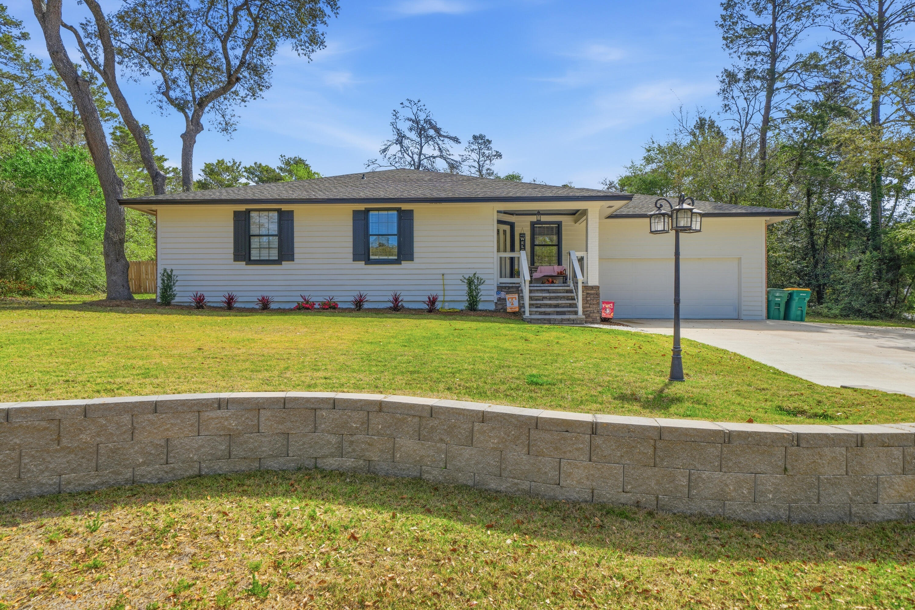 Beautifully updated home in the desirable Bluewater Bay subdivision - updates galore and move in ready! Situated on an almost 1/2 acre corner lot with freshly trimmed trees, this three sided brick home has been completely repainted on the exterior and features a 1 year old roof and a brand new front porch. The driveway has been fully rebuilt, extended, and widened to include additional side parking - perfect for your boat or all the fun Florida toys. The spacious backyard offers plenty of room for a future pool and features a large covered porch. To top it off - brand new landscaping, hello curb appeal!  The garage is a major highlight with tall ceilings, fresh paint, new stairs, and an expanded storage room. It also features a $7,000 hi-lift insulated garage door that's Wi-Fi compatible. Inside, it's just as impressive - including new lighting, ceiling fans, all new switches and outlets, plus new smoke and CO2 detectors. Popcorn ceilings have been removed in the main common space areas. The master bath has been thoughtfully redone, and the kitchen offers a functional, open layout with ample cabinetry and stainless steel appliances - perfect for entertaining. With $50K+ in renovations (and likely more), this home is turn key and ready for its next owner in the heart of one of Niceville's most popular communities. Don't miss your opportunity!
