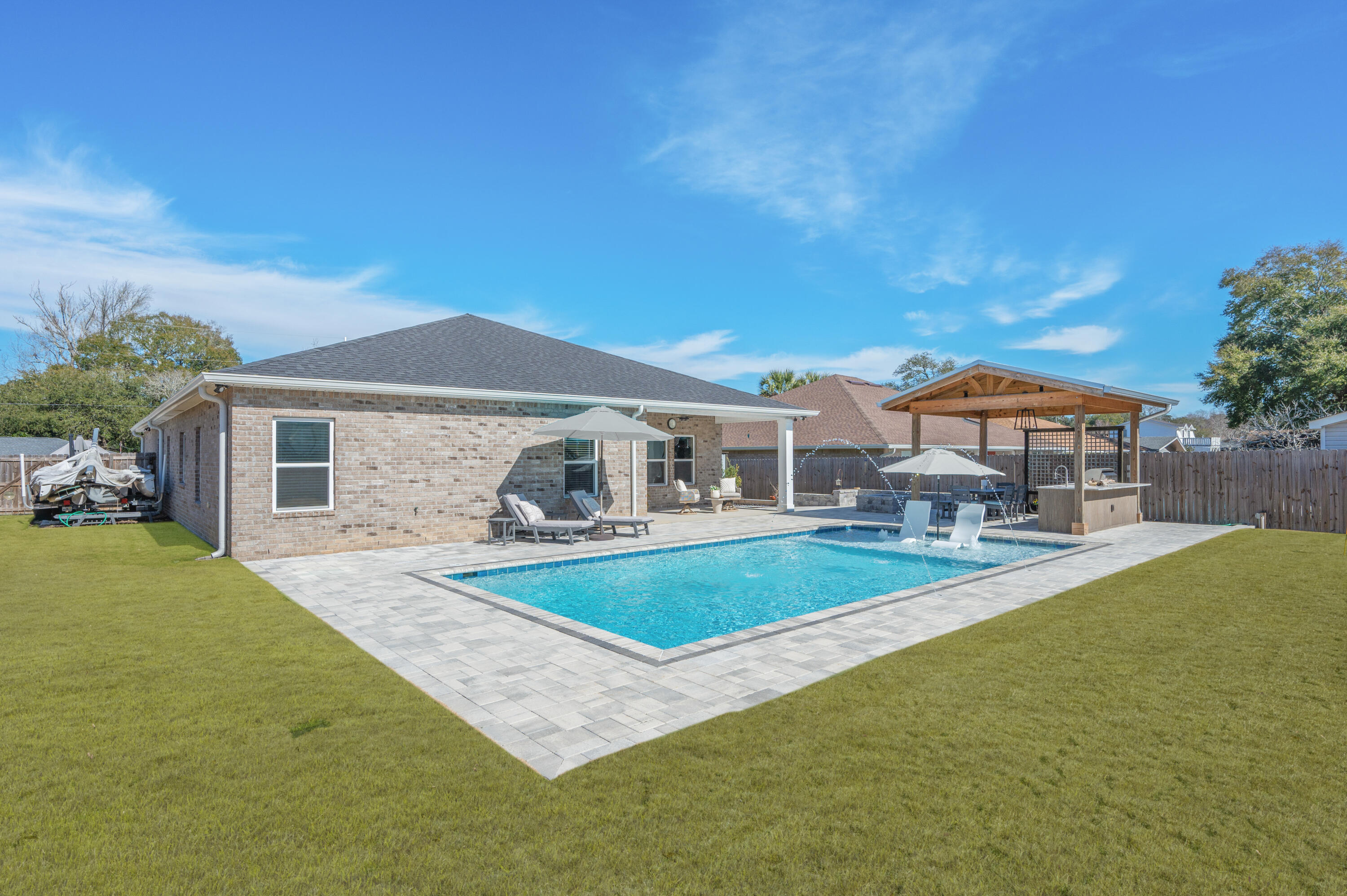 Boat Lovers, Take Note! Don't miss your opportunity to own this stunning 2023 home nestled in the highly sought-after Poquito Bayou neighborhood, just minutes from the community boat launch. Designed with outdoor enthusiasts in mind, this property features an oversized driveway perfectly suited for boat and jet ski parking—making waterfront adventures effortless.
Offering 2,520 square feet of thoughtfully designed living space, this home showcases elegant finishes and fixtures throughout. The open-concept living, dining, and kitchen area creates the perfect backdrop for entertaining, anchored by an oversized kitchen island, soft-close cabinetry, stone countertops, and stainless steel appliances. Seamlessly transition outdoors to a custom paver patio, resort-style pool with built-in sundeck, and an incredible stand-alone outdoor kitchen complete with stainless steel gas appliancesideal for hosting unforgettable summer gatherings. Extra thoughtful additions such as the outdoor shower, raised garden pets and pet tortoise garden run, truly make this home special. There is even room to park a small boat inside the backyard gate. 
Enjoy endless evenings lounging poolside, dining al fresco with friends and family, or cultivating your green thumb with built-in garden beds along the side of the homeall while preserving ample green space for backyard games and festivities.
Inside, the home feels open and airy with 5 bedrooms, 3 bathrooms, and a dedicated office located off the primary suite. The split floor plan offers privacy, with an exclusive primary wing accented by oversized barn doors. Retreat to your private sanctuary featuring a spa-like ensuite with a soaking garden tub, glass-enclosed shower, private water closet, dual vanities, and a spacious custom walk-in closet with built-in cabinetry and shelving.
Built in 2023 and thoughtfully improved since, all major systems and appliances are new or newerproviding peace of mind for years to come. Additional features include tile throughout main living areas and bathrooms, carpeted bedrooms, and high-end finishes throughout.
Ideally located within walking distance to the neighborhood boat launch and playground, just a short drive to the white sandy beaches of Okaloosa Island, minutes from Eglin AFB, and only 15-20 minutes to Hurlburt Fieldthis home truly offers the perfect balance of work, play, and coastal living.
Welcome home to your own slice of Florida paradise.