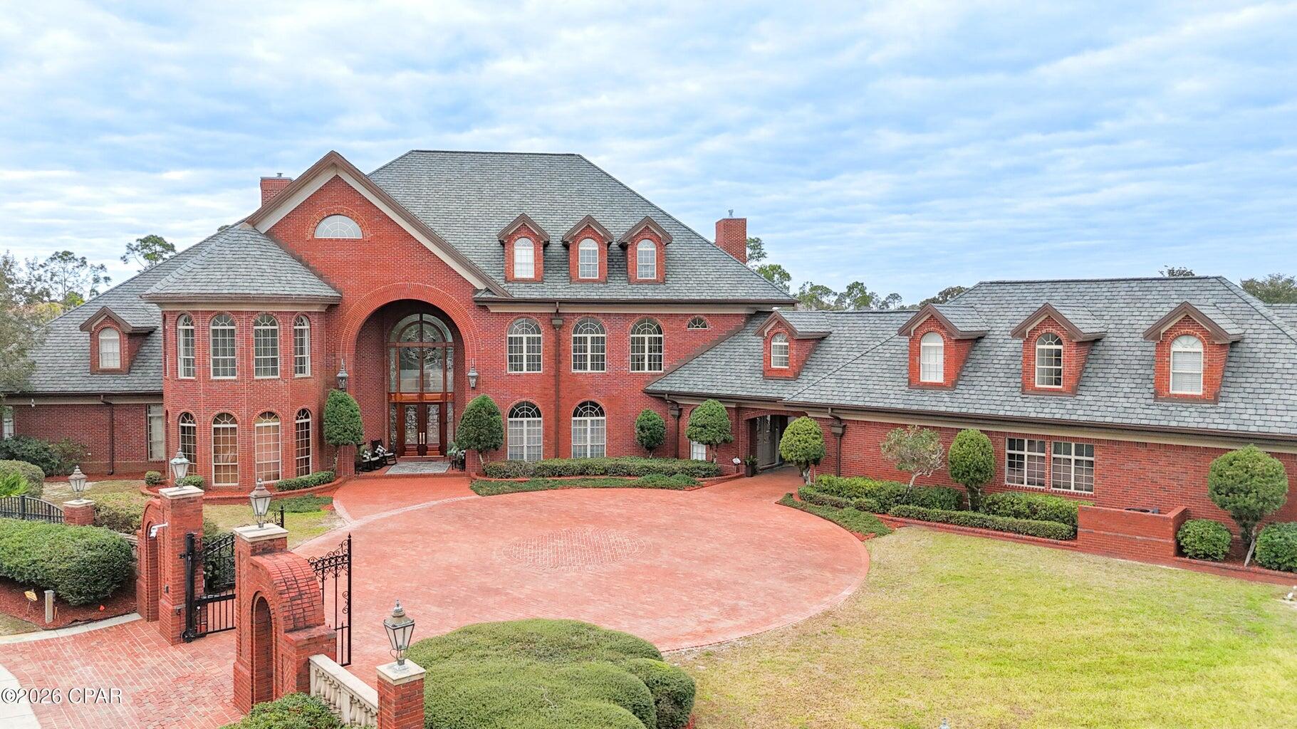 3703 Preserve Bay Blvd | Estate Living in The Preserve Located within the prestigious gated community of The Preserve, this extraordinary 12,200 sq. ft. estate sits on approximately 1.6 acres and offers a rare opportunity to own one of Bay County's most remarkable homes. Combining impressive architectural scale with timeless craftsmanship, this property was designed for both elegant living and exceptional entertaining. From the moment you arrive through the gated brick entrance and circular drive, the home makes a lasting impression.  The grand brick façade, dramatic arched entryway, and classic dormer windows create a striking presence that reflects the quality and attention to detail found throughout the property. Inside, the home showcases Italian marble, Brazilian mahogany hardwood flooring, and premium granite and marble finishes that add warmth and sophistication throughout the living spaces. Soaring 11-foot coffered ceilings and 8-foot interior doors create an atmosphere of openness and light, while lead crystal chandeliers and detailed woodwork provide a timeless elegance. Designed with both comfort and recreation in mind, the property offers an impressive collection of amenities that support an active lifestyle. The grounds feature private tennis, basketball, and volleyball courts, along with a fitness room, ballet/yoga studio, and an expansive game room. For entertainment, the home also includes a custom media and music room located within the third-story dormer, where you can enjoy beautiful views toward the bay while hosting family and friends. The outdoor spaces create a true resort-style setting, centered around an oversized saltwater pool and spa surrounded by beautifully maintained grounds that provide privacy and room to enjoy the full 1.6-acre estate. The pool area has been recently upgraded with a commercial-grade pump and salinator system installed in 2023, along with new safety railings. Over $300,000 in recent upgrades provide exceptional efficiency and peace of mind, including whole-home Caterpillar generators for complete power independence, three new HVAC systems, six new water heaters, and a durable 50-year roof. A pneumatic elevator also provides convenient access between levels of the home. The estate offers six spacious bedrooms, each with its own private ensuite bath, along with 11 bathrooms thoughtfully positioned throughout the home, providing comfort and privacy for both residents and guests. A four-car garage offers additional space for vehicles and storage. Above the garage, you will also find a separate apartment with its own private entrance, providing the perfect space for guests, extended family, or a private office or studio. 3703 Preserve Bay Blvd is more than a home, it is a private estate in one of Bay County's most desirable communities, offering a lifestyle defined by space, craftsmanship, and exceptional amenities.