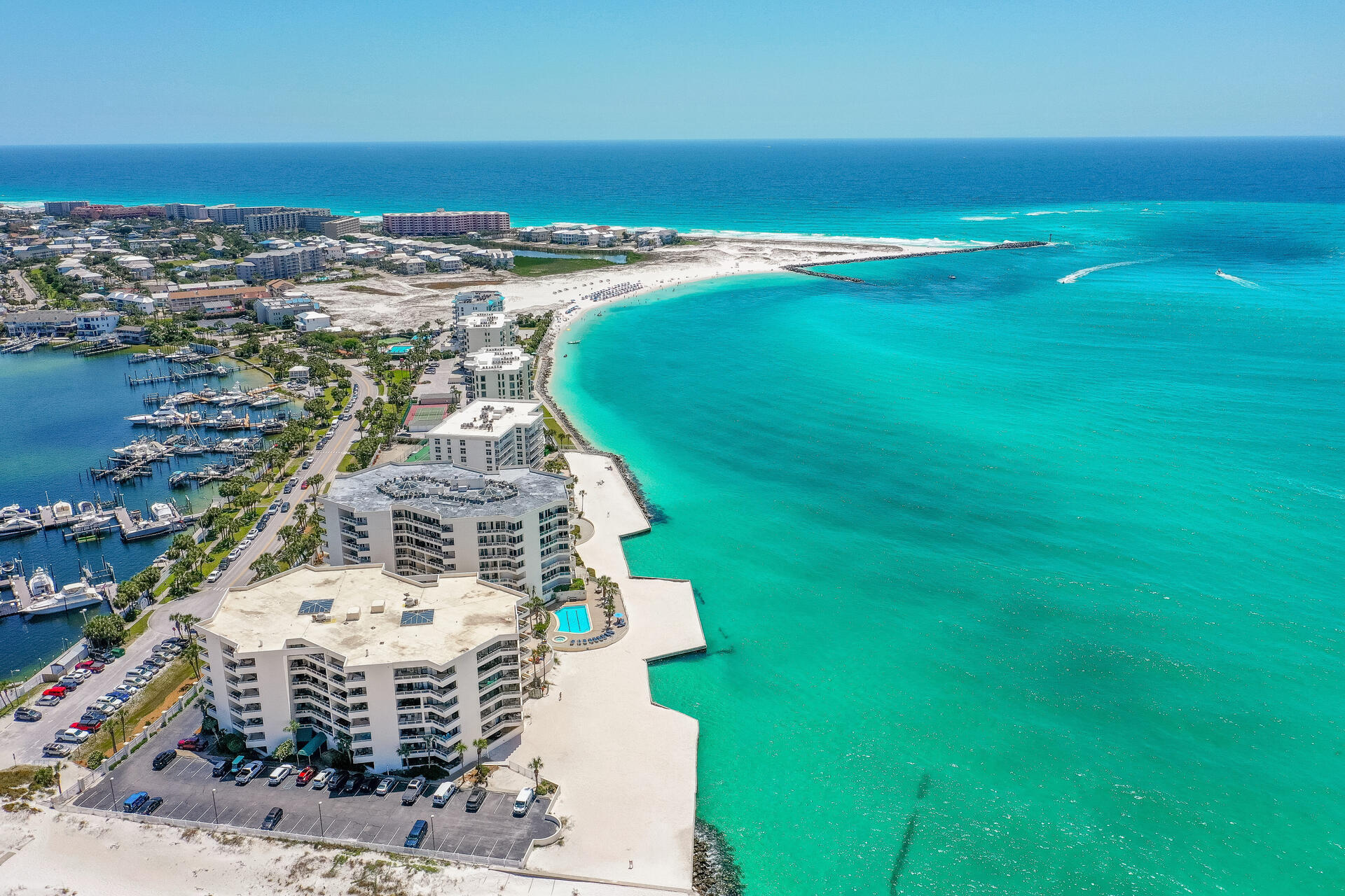 Welcome to East Pass Towers, Unit 403 with 2 bedrooms and 2 baths and 1500 sq ft. This unit has panoramic views of the Destin Harbor.  In addition, the NEW Norriego Point Park is nearby, Destin, Florida's newest public beachfront park! This park has soft white sandy beaches, extra parking, beach boat and jet ski parking, and is used by scuba divers! The park is beautiful and is a short distance from the condo. East Pass Towers is a gated community and is located at the end of Holiday Isle and offers Gulf, East Pass, and Harbor views! This condominium has one of the best locations for watching dolphins, boat traffic, and fireworks! There are not many condominiums that offer all three views! Also, there is a resort, style pool, hot tub, fitness center and community room. There is more! The condo has just refurbished the pool and hot tub and has remodeled the Club Room with a kitchen! The Fitness center is getting remodeled now! All assessments have been paid! The unit has a dedicated, garage parking spot! This is very important in the busy season! Park your vehicle or golf cart in this space. Every owner is allowed two parking spaces! There is a private marina with boat slips for sale across from the condominium! If you don't have a boat, don't worry! You can take a water taxi to dinner at popular restaurants such as Boshamps, Harbor Docks and AJs on the Harbor! Destin, Florida is a boat to table community! The unit is one of the largest 2 bedroom unit and offers a large living room space (30'x15') space with a built in office. The unit also has a balcony that (465 sq ft) provides breathtaking views of the Destin Harbor. There is an open floor plan with the kitchen opening to the dining area and living room. All of these areas plus the primary bedroom have waterfront views! The kitchen has a raised breakfast bar that seats 4, stainless appliances, built in microwave, slide in stove and oven. The dining room is spacious and overlooks the harbor! There is also a dedicated coffee or wine bar with cabinetry and a beverage refrigerator. There are two primary bedrooms with space for king sized beds. One primary bedroom has an ensuite bathroom. The primary bathroom has custom cabinetry with crown, a walk in shower, soaking tub, and spacious vanity. The guest bedroom is very spacious! This condo is being sold furnished. In addition there is a full guest bathroom and a laundry space. There is tiled flooring in all areas but the bedrooms. This unit is perfect for a primary home, second home or vacation rental. The condo association is well funded and managed! The assessments have been paid and the condo has already completed and past the SIRS inspection! Watch the sunrises from your condo, enjoy exciting evenings with fireworks over the harbor during the summer, relax on the dedicated white sandy beach of the condo, or take a boat to dinner! This condo offers water front living at it's finest! Come enjoy the beautiful, white sandy beaches of the Gulf, East Pass, and Harbor! Owners are allowed to have pets! There are several public beach access within minutes from East Pass Towers. Buyers to verify all information and dimensions.
