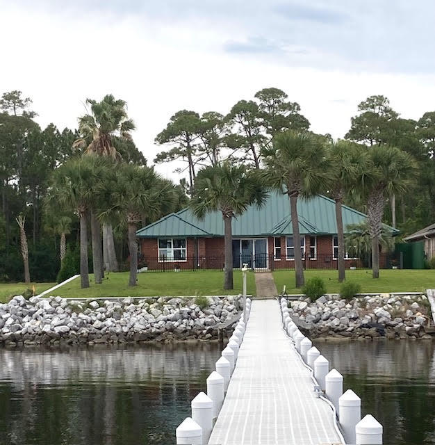 MILLION DOLLAR UNOBSTRUCTED WATERFRONT VIEWS on one level with Open floor plan, PIER, 2 Boat Lifts, Entertainment area on the pier.
Underground Utilities on Sewer.
QUICK CLOSING: INSPECTION, SURVEY & ELEVATION CERTIFICATECOMPLETED  . Under termite bond. 
All brick, metal roof, tiled floors, updated windows, guttering, outdoor shower, partial fenced yard, fresh paint, central heat & ac, multiple entrances. 
READY FOR MOVE IN.  NO Home Owners Association. 
FLOW THRU DECKING, above deck WATER AND POWER  with over 250 Feet 
BOAT LIFTS (rated 20,000 and 5,000 pounds.)

Public Water, GAS, Florida Power and Light, Private Well for Irrigation.

Electric Fireplace, Entertainment Room with Private Entrance. Possible 5th bedroom with DAIKEN heating/cooling, & cabinets,
GUEST ROOM with  Private entrance and bath.
Take your Pontoon Boat, Paddle Board or Jet Ski to the Island and walk to the GULF or catch dinner at Navarre Beach or Pensacola Beach. Great location with exits to the East  on Sound Retreat or West on Lighthouse Pointe. Lots of NATURAL LIGHTING THROUGHOUT.
TILED throughout, with ceiling fans, updated lighting, hardware, closet mirrors, windows installed 2005. NEW APPLIANCES, ELECTRIC FIREPLACE, AC UNITS garage & studio. 
IRRIGATION SYSTEM with Private
Well, Pump and Sprinklers, Outdoor Shower, Hurricane Shutters, Metal Roof, On Demand Hot Water Heater, Pella Windows in main portion of house South of Laundry Room.
HANDY MANS Wonderland
w/storage cabinets, 220, hot/cold running water, climate control and polyurea flooring
Boat or RV Parking in your driveway.
LOTS OF ROOM to PADDLE BOARD, CANOE or SAIL.
Termite Bond Transferable.  
DOCUMENTS SHOW County Flood Zone map.  Delineation of flood zone goes around the house. 
All BRICK HOME was rebuilt in early 2000's. METAL ROOF, GUTTERS, Fenced Patio, Fresh Paint, Knockdown Textured Ceilings,  attic duct work replaced, Windows replaced in 2005 & gas tankless water heater.   WEST WING has a guest room, bath and PRIVATE SUITE and ENTRANCE with BATH, handicap shower features, pet door leading to fenced patio with Water View. 
LARGE MASTER BEDROOM is on the EAST SIDE with WATER VIEWS from bath and bedroom.  Jetted Tub, Separate Shower, Double Vanities, Linen Closet and Private Commode. FOURTH BEDROOM IDEAL FOR a Private Office, Nursery, Library, Children's Area, Sewing Room or Guest Room.
KITCHEN has plenty of granite counter space, new back splashes, new Shaker Style cabinets and hardware. Wine glass rack, microwave, STAINLESS STEEL APPIANCES, NEW REFRIGERATOR and STOVE, accent lighting under the bar.  Kitchen overlooks the Bay Window Seating and into the Living Room with space for a formal dining suite.  
Motion Sensor exterior lights and accent lighting on the palms, Water shut off to the pier and Outdoor shower.  
Buy a lot in Holley by the Sea and utilize the Recreational Center with year-round  swimming in the enclosed lap pool, outdoor family pool, Million Dollar work out room, tennis courts, deeded water access, camping, social club and much more. (HOA DUES approximately $550 year plus property taxes).