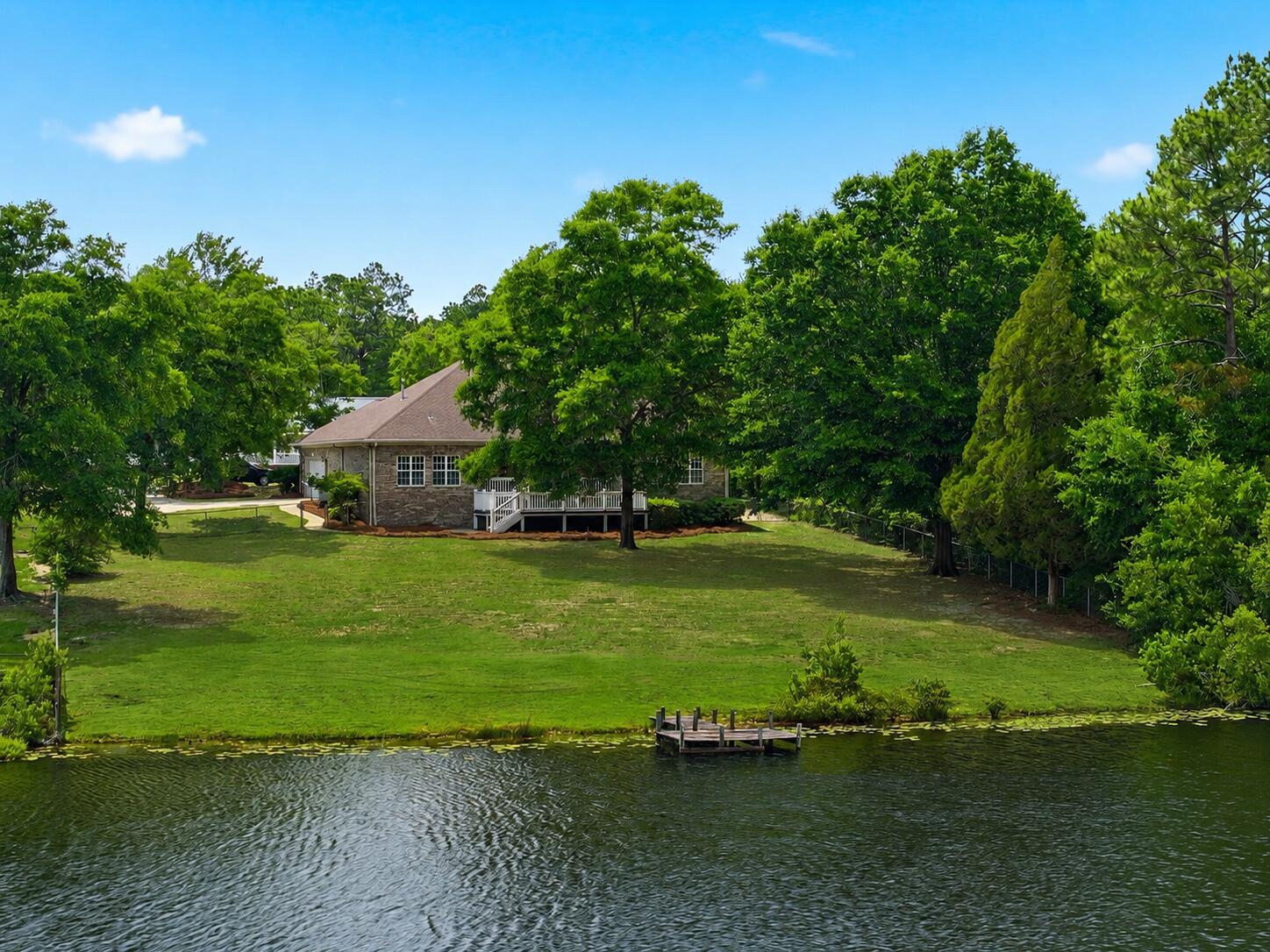 Custom built and thoughtfully designed, this 3 bedroom, 2 1/2 bathroom lakefront home offers over 2,200 square feet of comfortable living tucked away in the quiet Hidden Lakes community of DeFuniak Springs. Perfectly placed windows fill the home with natural light while capturing lake views from nearly every room. Situated on an oversized lot with a private dock, covered back porch, and extended outdoor entertaining area, this property was designed to enjoy the beauty of lakeside living.

Inside, you'll find fresh paint, new carpet in the bedrooms, and new refrigerator, as well as a new roof and water heater. The kitchen features custom cherry cabinetry, while the living room showcases natural hardwood flooring, a wood burning fireplace, and a custom built media center that creates a warm and inviting focal point. Additional details including custom trim work and crown molding add character throughout the home.

Whether enjoying your morning coffee overlooking the Lake or unwinding after dinner on the back porch, this home offers a peaceful setting that is hard to find.