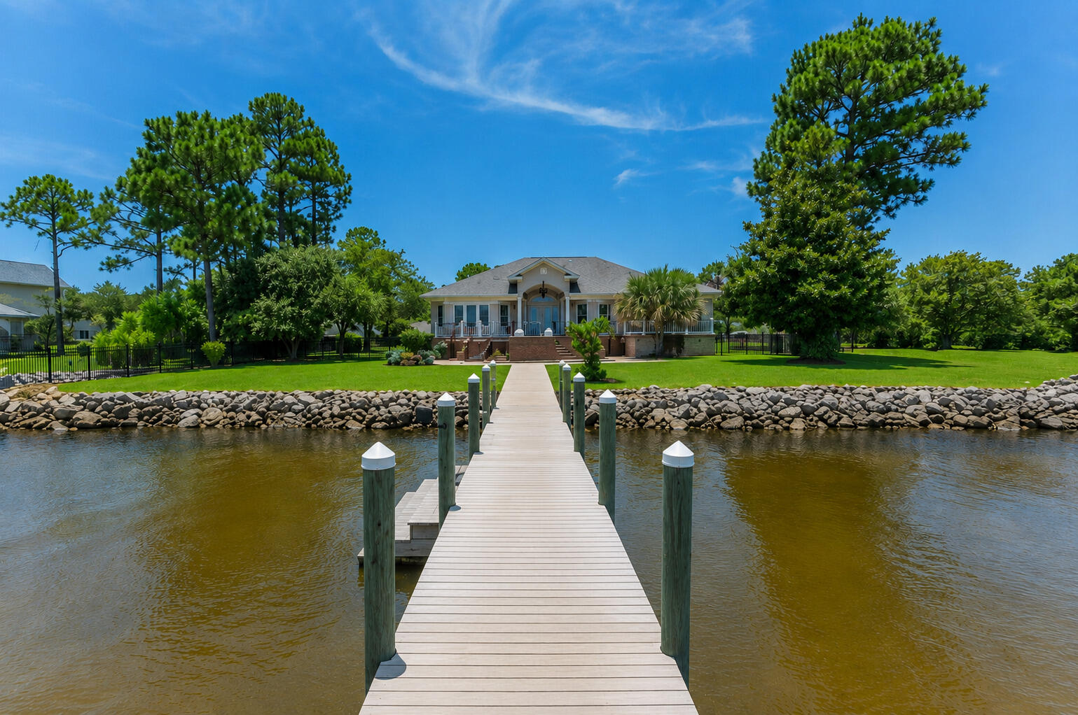 This pristine coastal retreat in Driftwood Estates is placed on the Bay of the Emerald Coast. The Gulf's beautiful beaches of 30A and Miramar Beach are a few minutes drive. This low maintenance, one story, southern home's outdoor living area boast a covered patio and deck with two oversized sitting areas to overlook the relaxing Bay and dock.  The lush grounds are perfect for lounging and entertaining in the firepit area, the grilling area, in the swim spa plus offering privacy with the enclosed fence. The welcoming front porch views the rose lined circular paver driveway with parking for up to 6 guest. Inside, the coastal elegant Foyer greets you with soaring ceilings, extensive molding, a gas fireplace surrounded by built-ins, a Formal Dining area, tasteful hardwood flooring and a tranquil view of the Bay!  There are 3 bedrooms, 3.5 baths and an office in this well-designed, split bedroom layout making it ideal for a primary or secondary home. The Master Suite wing of the home has an entry off of the Foyer that offers the privacy of a Master Bedroom with french doors to access the exterior Deck and Sitting Areas, the Dock, the Swim Spa and yard. The oversized shelved separate Master Closet is in the bedroom. The spa feel of the En Suite Master Bath gives a soaking tub for relaxation, an enclosed separate shower and a generous marble top double sink vanity. The privacy of a Home Office with a closet is convenient also. The Half Bath is close to the formal areas for guest. The character of the home includes a secondary dining area and expansive open kitchen with granite countertops, stainless appliances, gas cooking and a breakfast bar that offers easy acess to the relaxing living area while enjoying the view of the Bay. Walking from the kitchen area down the corridor there are 2 split bedrooms with en suites, a laundry room with folding area and the entry to the oversized garage with a yard access door.