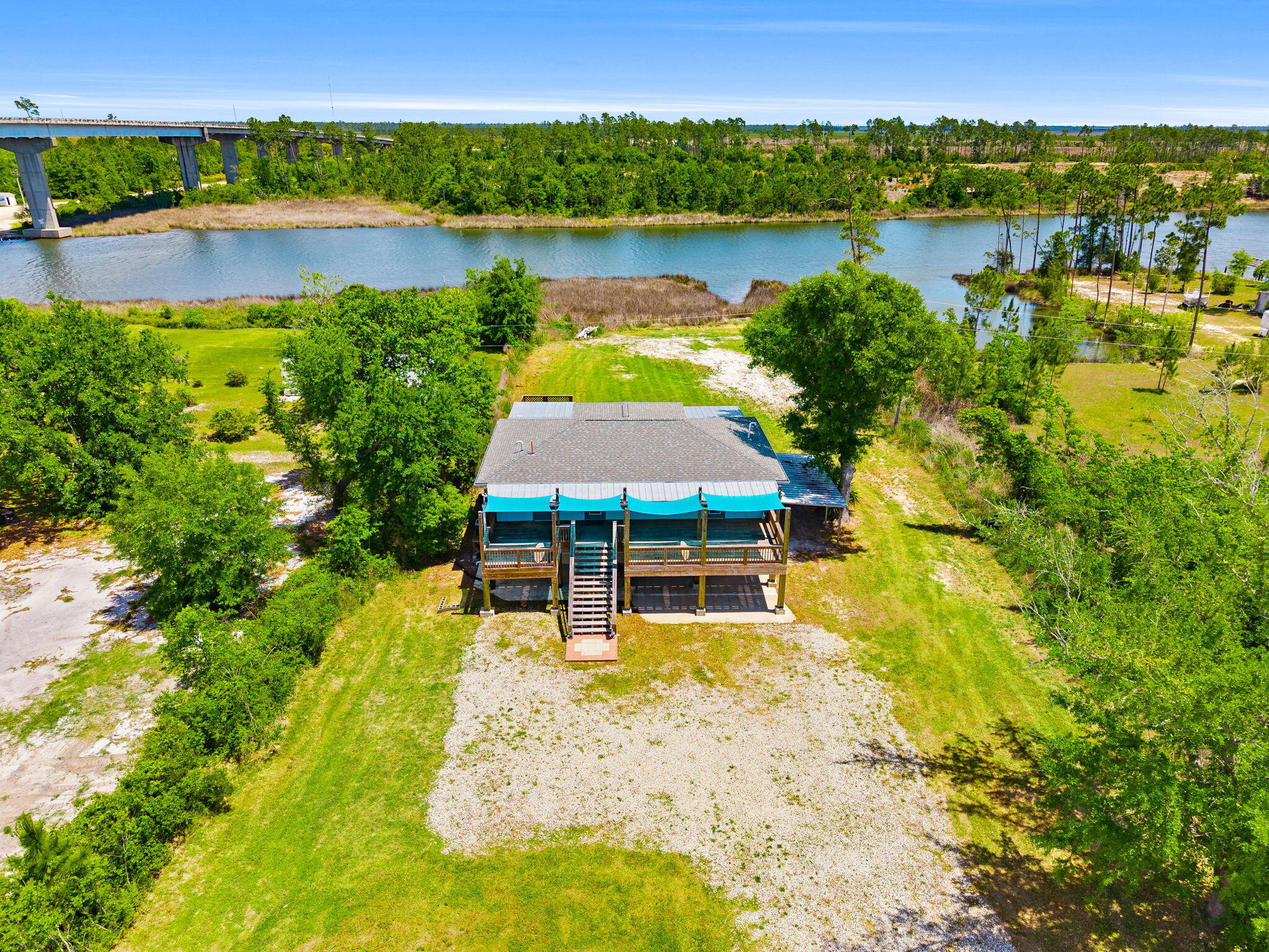 Welcome to your slice of waterfront paradise on the Intercoastal Waterway! This beautifully designed 3-bedroom, 2-bathroom home offers the perfect blend of comfort, natural light, and breathtaking views. Step inside to a bright and airy living space filled with tons of natural lighting, enhanced by light hard wood flooring that creates a warm and inviting coastal feel. A double set of large sliding glass doors draws your eyes straight to the water, seamlessly blending indoor and outdoor living while showcasing stunning, unobstructed views of the Intercoastal. The kitchen is both stylish and functional, featuring light wood cabinetry, bright countertops, and a spacious walk-in pantry--perfect for keeping everything organized while maintaining the home's clean, coastal aesthetic.