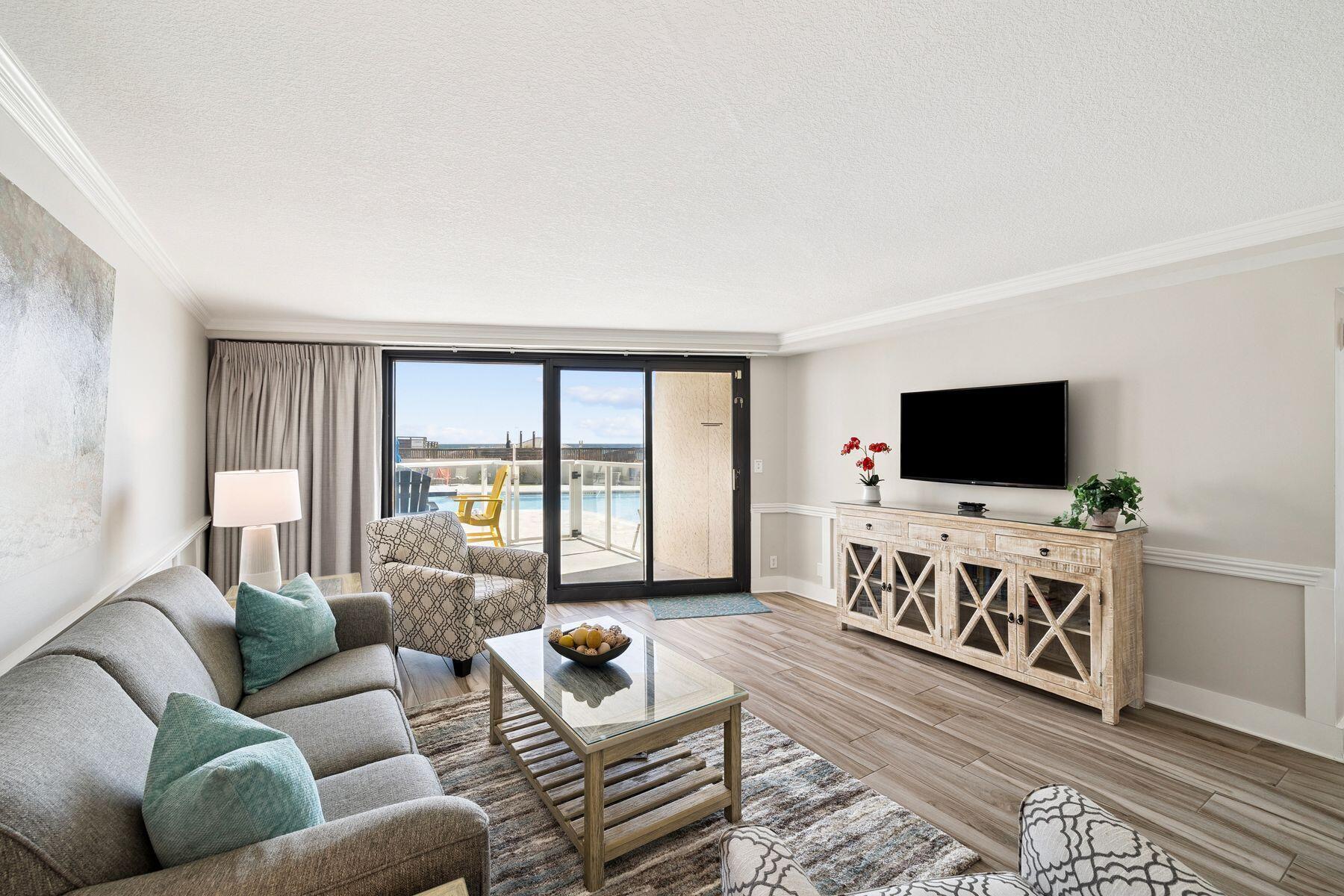 There is something undeniably indulgent about stepping off your patio and being poolside in seconds, with the gulf shimmering just beyond. Unit 4208 at Beachside II captures that effortless rhythm of coastal living, pairing elevated views with the rare convenience of first-floor access.
From the moment you enter, the interiors reflect a polished beach aesthetic. Plank tile flooring runs throughout, while a professionally designed palette of soft neutrals and coastal textures sets a relaxed yet refined tone. The living area offers generous seating, a large wall-mounted HDTV and an easy flow into the dining space and breakfast bar, creating an inviting setting for quiet evenings or hosting friends.
The kitchen is both stylish and functional, featuring white shaker cabinetry, stainless steel appliances, granite countertops and a mosaic glass tile backsplash. A spacious pantry conceals a stackable washer and dryer, keeping everyday living seamless and organized.
In the bedroom, newly installed picture windows frame views of the pool and gulf waters beyond. A king-sized bed with premium bedding anchors the space, complemented by generous storage and calming design details. The adjoining bath elevates daily routines with quartzite marble countertops, a double vanity and a sleek glass-enclosed tub and shower combination.
Step outside to your private patio overlooking the brand-new saltwater pool and hot tub, complete with sun deck and paver surround. This walkout location makes it exceptionally easy to carry in groceries from the covered parking garage or head straight to the sand with beach gear in hand. Ideal for families, it offers both accessibility and a surprisingly strong gulf view for a first-floor residence.
Beachside II enhances the experience with a redesigned lobby, gulf-front pool, fitness room and private beach walkover. Ownership also includes access to the expansive amenities of the resort, spanning 2,400 acres with championship golf courses, a full-service marina, tennis and pickleball courts, spa services, dining venues, entertainment and miles of biking and walking paths.
Whether envisioned as a primary residence, second home or income-producing retreat, this Gulf-view condominium offers a rare combination of comfort, convenience and resort-scale amenities just steps from the sand.