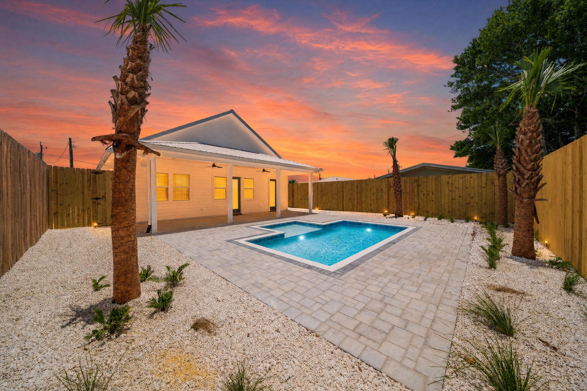 Welcome to 305 Tanaga Street, a stunning NEW construction (2026) coastal retreat on a quiet cul-de-sac in the highly desirable west end of PCB. This Pre-inspected 4-bedroom, 4-bathroom home plus a versatile flex room offers the perfect blend of luxury and comfort. The open-concept floor plan is designed for entertaining and everyday living with abundant natural light and seamless flow between the living, dining, and kitchen areas. The chef-inspired kitchen features quartz countertops, premium appliances, ample cabinetry, and generous workspace. Luxury vinyl plank flooring runs throughout the home. The spacious primary suite features a spa-inspired bath with a zero-entry walk-in shower. The flex room is ideal for a home office, bunk room, media room, gym, or additional guest space. Step outside to your private backyard oasis featuring a covered outdoor patio, heated saltwater pool, heated outdoor shower, artificial turf, and an 8-foot privacy fence.  Built with coastal resilience in mind, the home includes hurricane-rated windows and exterior doors, engineered roof anchors, and modern construction standards designed for peace of mind. With no HOA restrictions and convenient access to beaches, this exceptional property is ideal as a primary residence, second home, or investment property.