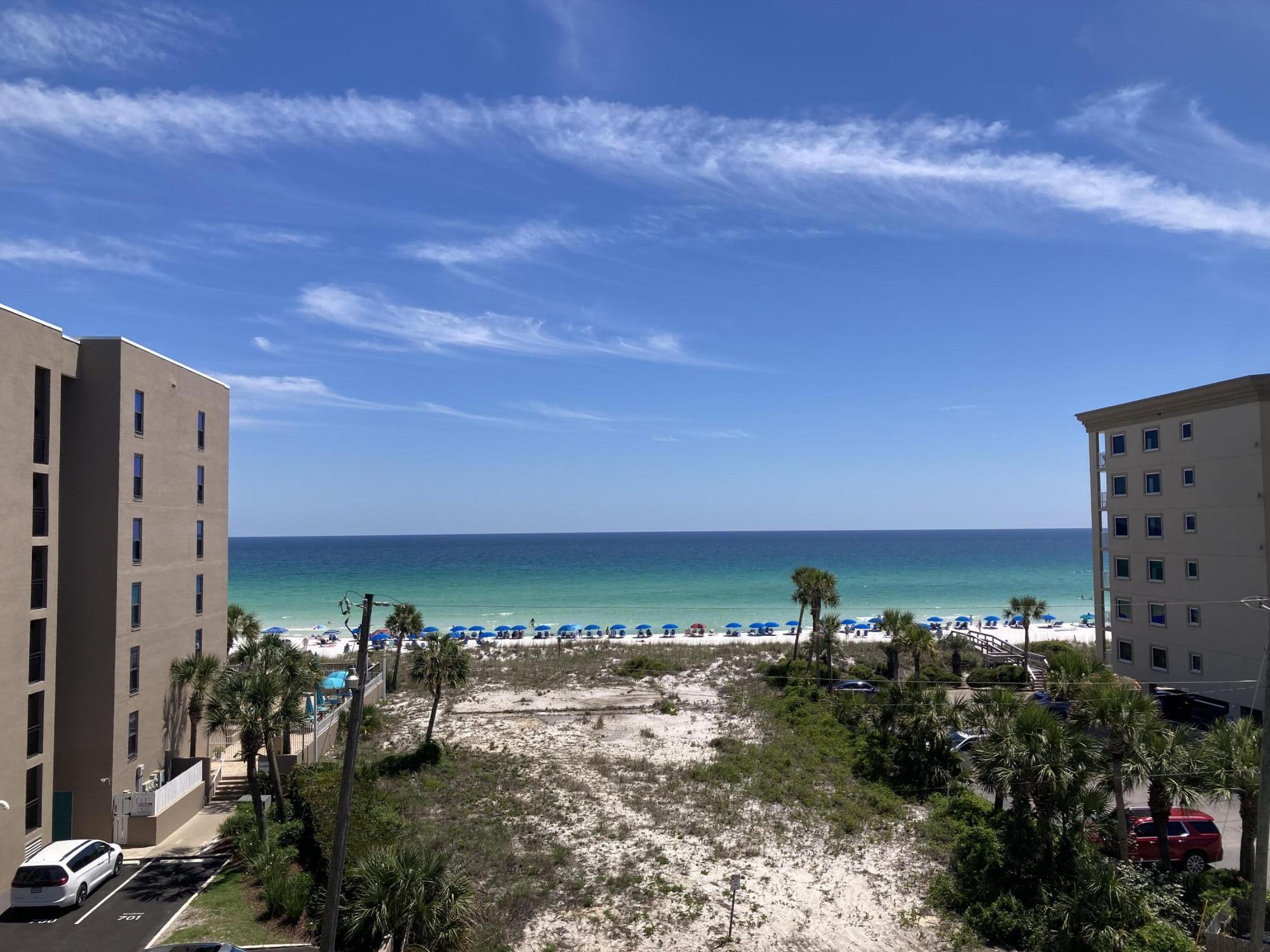 Check out this freshly painted, well maintained 5th floor unit that is beautifully decorated in a beachy vibe and has stunning views of the emerald green waters of the Gulf.  Emerald Isle is located on the white sand beaches of the Emerald Coast of Florida and offers not only the beautiful beach but also a Gulf front pool, BBQ area and a tennis/pickle ball court.  No need to bring your sandy beach equipment up to the unit. Instead, use the convenient storage cage on the ground floor that conveys with the unit. Emerald Isle Condominium recently completed a multimillion-dollar restoration to the building to include repairing concrete, waterproofing and painting the building, elevators, replacing railings and resurfacing the parking lot. Buyer to verify all dimensions and square footage.