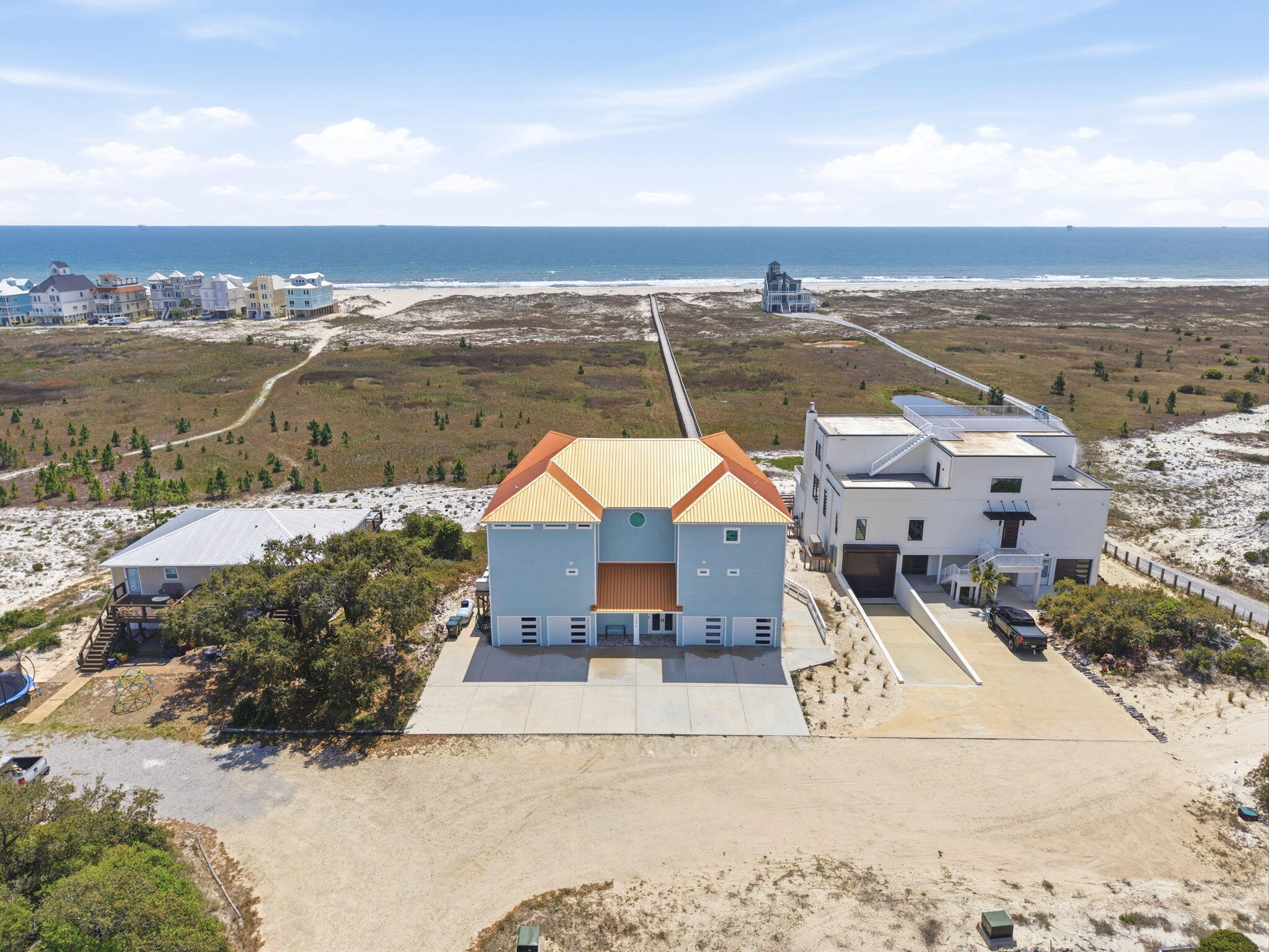 Built in 2023, this custom 5BR, 5.5BA Gulf-front residence offers 3,632sf of thoughtfully designed living space, with 2,200sf of screened porches that extend the living experience outdoors. Spanning approximately 4 acres with 100 feet of prime beachfront, this residence delivers a rare combination of artistry, privacy, & direct Gulf frontage. Every element of this home reflects intentional design & construction, from its trapezoid layout that maximizes views to the structural integrity of pilings driven approximately 20' deep. Kitchen is equipped with Sub-Zero freezer/refrigerator, double ovens, 2 Bosch dishwashers, convection/steam ovens & custom cabinetry paired with quartz surfaces, custom tile, & lighting selections unique to the custom build. An open living space features vaulted ceilings, while each bedroom offers its own private retreat. A work of art - a bedroom suite showcases a round soaking tub that is a statement piece with custom tile with artistic touches through out. Primary suite offers Gulf views, fireplace & spa-like tub with built-in heater & bubbler for luxury retreat! Highlights include 2 laundry rooms, self-flushing toilets, elevator servicing all levels, & 4-car garage. Outdoor living is just as impressive, designed for both relaxation & entertaining. Enjoy a chilled/heated 30x15 pool, separate hot tub, & a fully equipped outdoor kitchen with grill & cooktop. A private boardwalk, approximately 1,000' in length & 7' wide with 6' clearance, allows for golf cart access as it leads you directly to the Gulf, offering a seamless connection to the shoreline. Home features a whole-house generator & Gold Fortified designation, all working together to provide peace of mind. Here, the surroundings open up to uninterrupted Gulf views, wide stretches of sugar-white sand, & a sense of privacy that defines this stretch of coastline at the end of Fort Morgan just before the park, nearby boat ramps and miles of biking and walking trails.  Buyer to verify all i
