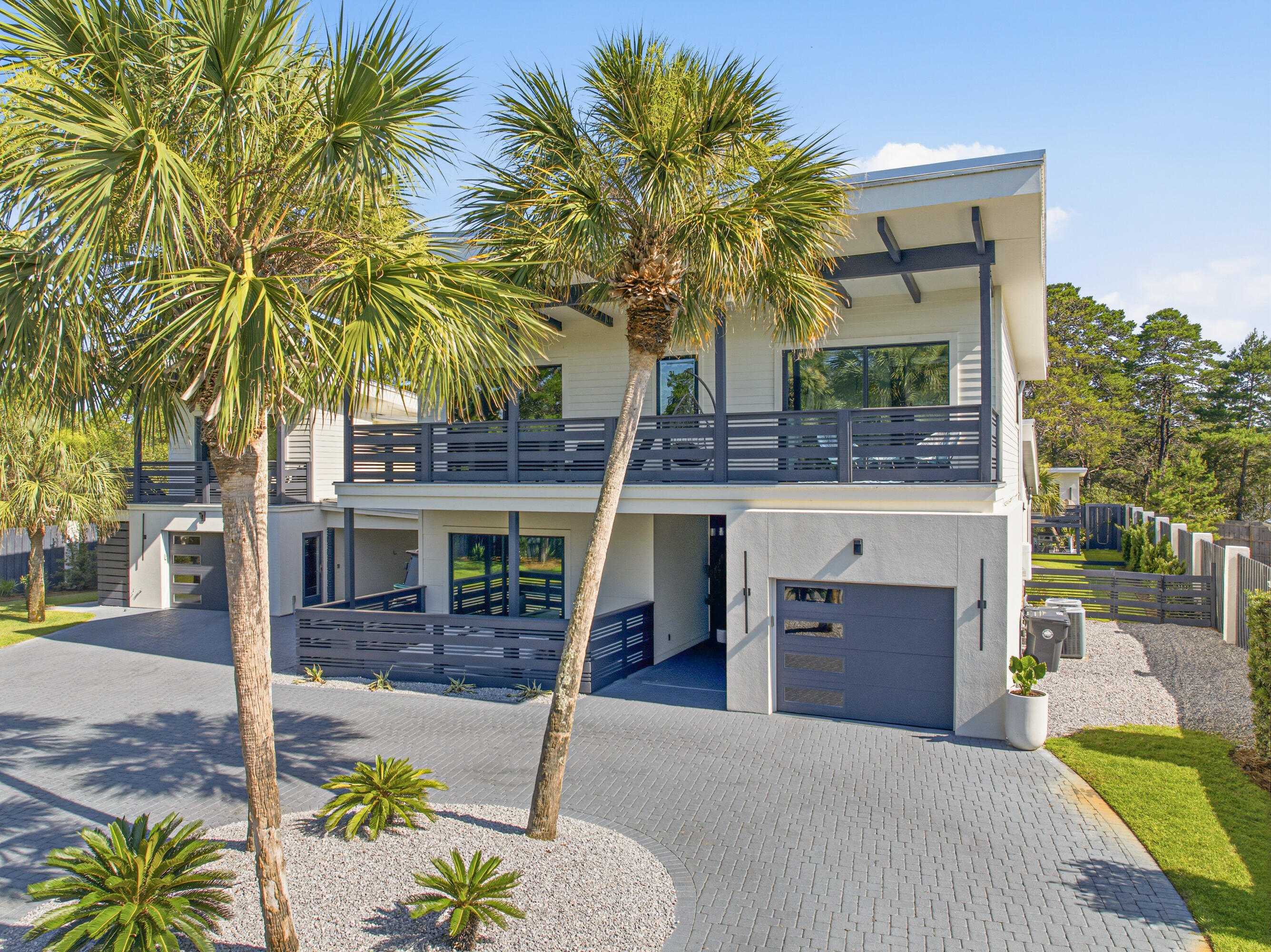 Set on just over half an acre in the heart of Blue Mountain Beach, this private estate offers a rare combination of space, privacy, and convenience just minutes from the beach.

Fully fenced and accessed through a private gated entrance, the property feels like it's own secluded compound. Mature landscaping, expansive outdoor living spaces, and a thoughtfully designed layout create an atmosphere that is both welcoming and relaxed. The estate is comprised of a spacious main residence and a separate carriage house, offering exceptional flexibility for family, guests, or multigenerational living.

Inside the main home, vaulted ceilings, white oak flooring, designer finishes, and expansive windows create bright, inviting living spaces that seamlessly connect to the outdoors. The chef's kitchen anchors the home and flows effortlessly into the dining and living areas, featuring premium appliances, ample storage, and a walk- in pantry. 

Privately situated on the first floor, the primary suite serves as it's own retreat. The spacious bedroom opens to a covered seating area overlooking the front yard, creating the perfect spot for your morning coffee. The spa-like primary bathroom features dual vanities, an oversized walk-in shower, and thoughtfully selected finishes throughout. Upstairs, you'll find three additional guest bedrooms. Two of the bedrooms feature en suite bathrooms and sliding glass doors that open to a balcony, while a third full bathroom serves the remaining guest bedroom. 

Complementing the main home is a detached carriage house complete with a kitchen, living area, bedroom, and a full bathroom, providing an ideal space for guests, extended family, or a private home office setup. A one-car garage adds additional convenience and storage. An additional bathroom is located off of the garage and provides added convenience for guests. 

The backyard is where this property truly shines. Centered around an oversized heated saltwater pool and spa, the outdoor spaces were designed to be enjoyed year-round. A screened porch, outdoor kitchen, poolside cabana, fireplace lounge, and multiple gathering areas provide the perfect setting for everything from quiet mornings to evenings spent hosting friends and family. Additional features, including an in-ground trampoline and charming two-story playhouse, add to the property's unique appeal.

Properties with this amount of land, privacy, and outdoor living space are becoming increasingly difficult to find on 30A. Located in the heart of Blue Mountain Beach and just minutes from the Gulf, local restaurants, shopping, and beach accesses, this home offers the best of coastal living while still feeling completely tucked away.