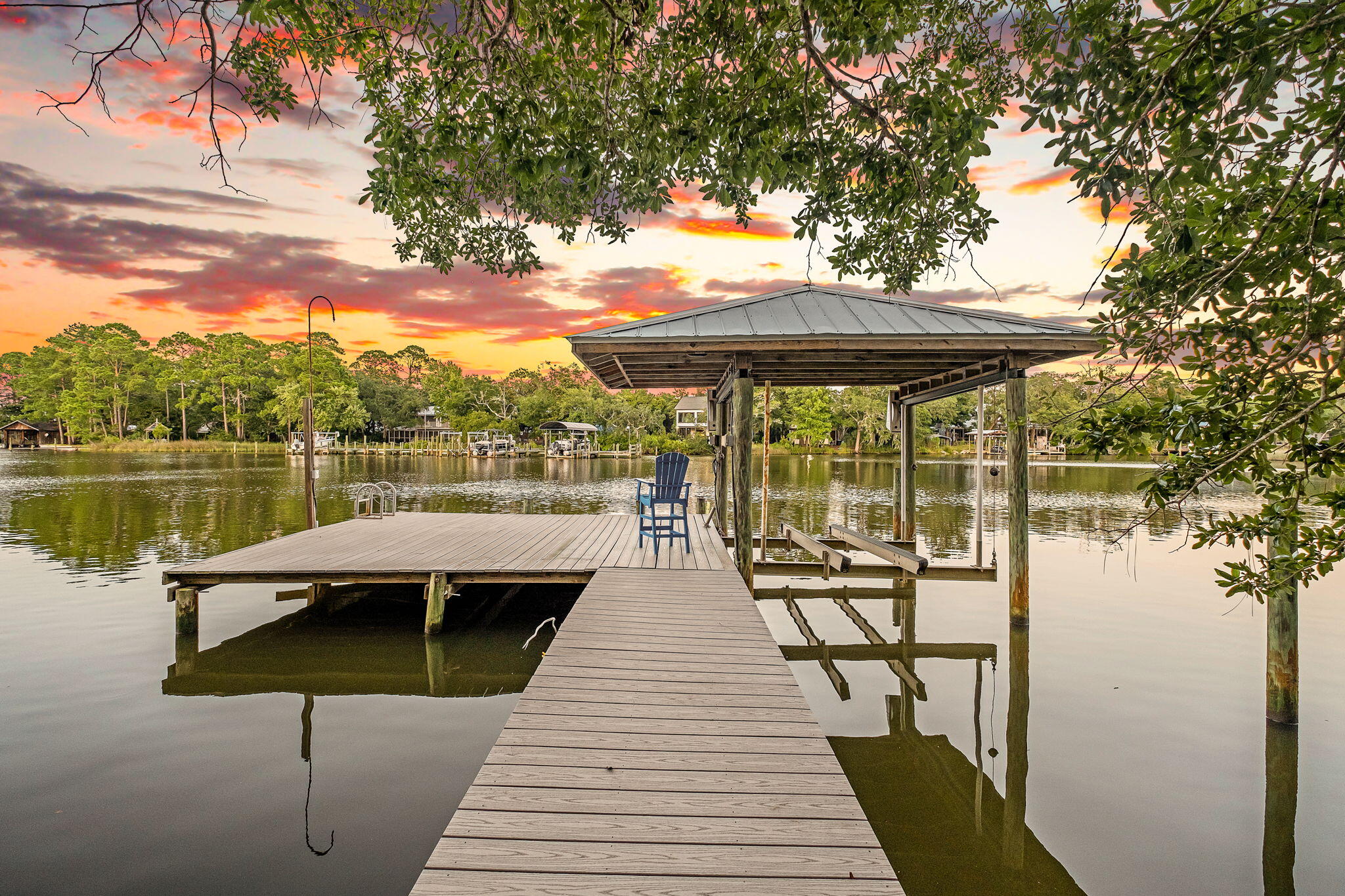 A rare waterfront retreat where privacy, panoramic bayou views, and timeless Mid-Century Modern architecture come together on 1.5 acres of pristine waterfront. Perfectly nestled among towering trees and fan palms, this exceptional bayou-front home offers a setting that is nearly impossible to replicate. According to the seller, current regulations no longer allow homes to be built this close to the water, preserving the spectacular views that stretch across the entire back of the property. Originally built by local builder Thomas Stoffels (builder of the Donut Hole), this thoughtfully designed home offers approximately 2,750 square feet with 4 bedrooms and 3 full bathrooms, including a private guest or in-law suite that can be separated from the main living area. Stunning bayou views fill the primary bedroom, great room, dining area, and the attached gazebo office/sitting area, creating a seamless connection between the home and its peaceful surroundings.

Extensively updated, the home features fresh interior and exterior paint, new luxury vinyl plank flooring, new carpet in two bedrooms, a newly added third full bathroom, second bathroom renovation, new pool screens, new sliding patio doors, a new electric pool heater, new privacy fencing, and an expanded dock with Trex decking and a covered boat lift.

Step outside and experience the waterfront lifestyle you've been dreaming of. Launch your paddle board or kayak from your private dock, spend the afternoon fishing, or enjoy an approximately 30-minute boat ride to Destin Harbor. Start your mornings watching dolphins swim by from the screened porch and end your evenings beneath brilliant star-filled skies from your own private retreat.

The attached garage includes a workbench, utility sink with hot and cold water, and attic storage, while the detached second garage provides abundant storage, shelving, and workshop space. A covered fish-cleaning or gardening station with a working sink adds even more convenience. The property is also zoned for a second story, offering future expansion opportunities on the main home or additional building options on the large piece of land.

With deep-water access, exceptional privacy, breathtaking views, and a location that cannot be duplicated, this is a truly one-of-a-kind waterfront property offering a lifestyle as remarkable as the home itself.