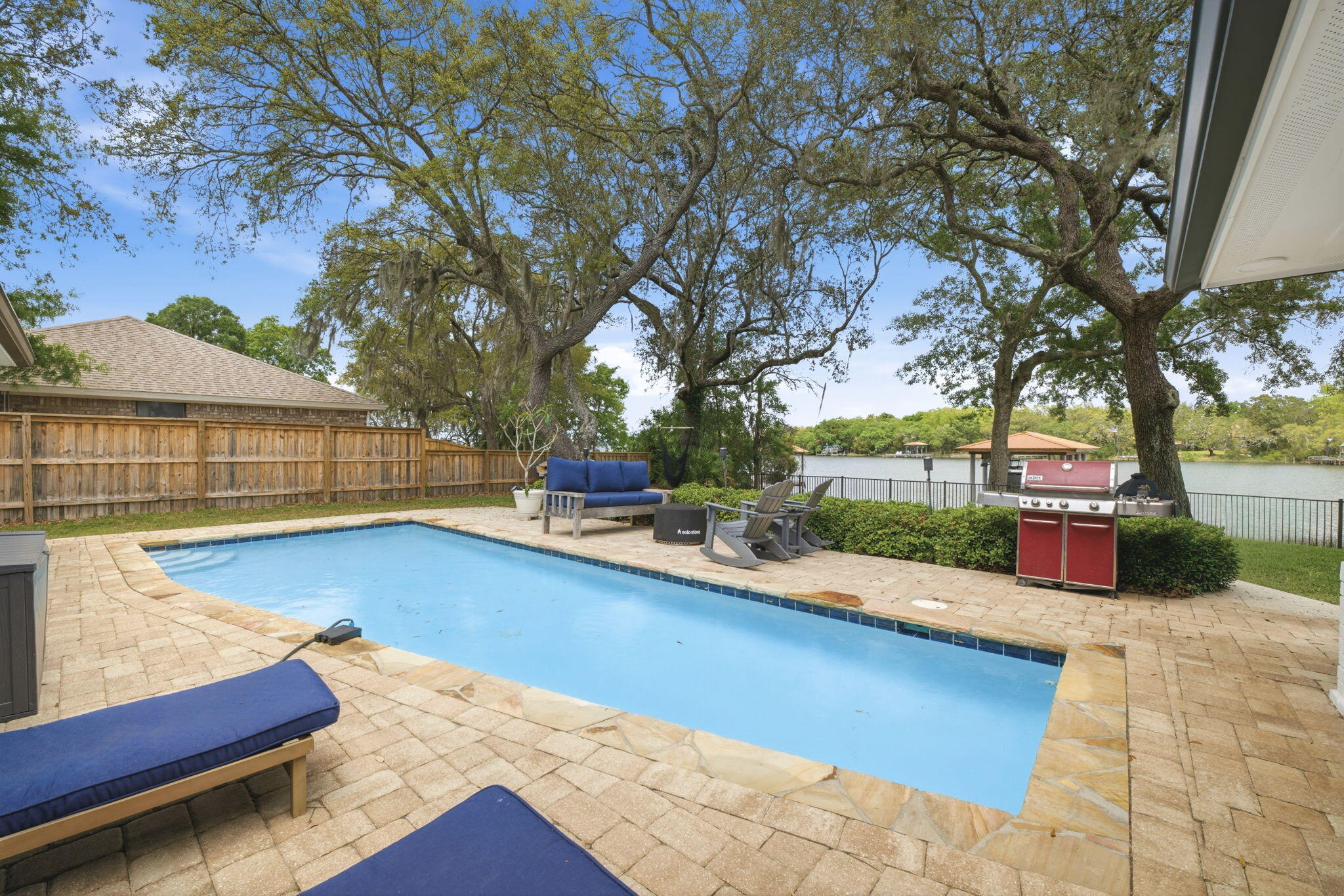 Tucked beneath a canopy of mature oak trees along the peaceful Bay location - this extraordinary waterfront residence is the definition of refined coastal living--where thoughtful design meets uncompromising quality and every detail has already been elevated for the next owner.

From the moment you arrive, the presence is undeniable. A newly completed driveway, sidewalk, and dedicated boat trailer parking pad (2023) set the tone, while the exterior showcases durable James Hardie board siding (2021), new gutters (2022), and a 30-year architectural roof (2022). Step inside and you'll immediately feel the care and craftsmanship poured into this home--every interior door, trim piece, and hardware selection has been completely updated, creating a cohesive and elevated aesthetic throughout. The heart of the home is a fully reimagined kitchen, taken down to the studs and expanded in 2022 to create a true gathering space. Outfitted with premium GE Café appliances, a Silgranite sink, soft-close cabinetry, granite surfaces, and stunning shiplap ceilings, this space seamlessly connects to a walk-in pantry and thoughtfully designed office (or optional 5th bedroom) with its own walk-in closet. The adjacent laundry room was also relocated and redesigned for maximum functionality.

Designed with flexibility in mind, the home features two luxurious primary suites--including a private upstairs retreat added in 2022 above the newly constructed garage. This suite is a sanctuary of its own, complete with a dedicated HVAC system, 50-gallon water heater, and the ability to be fully isolated from the rest of the home--perfect for guests, multigenerational living, or ultimate privacy.

Step outside and experience true waterfront living. The backyard is fully fenced (2025) with convenient dog door access, leading you to a beautifully maintained outdoor space complete with a resurfaced pool (2025), upgraded multi-stage pump, and saltwater system (2022). The composite dock (2021) and professionally constructed boathouse by Northwest Marine (2022) are nothing short of exceptional--featuring ECO piles, power and water, and a 12,000 lb lift, all set on deep water capable of accommodating larger vessels. This is a rare opportunity for boating enthusiasts seeking both function and durability.

Every major system in this home has been addressed with intention and longevity in mind. Highlights include:

High-impact hurricane windows (2022)
Complete HVAC replacement with insulated ductwork to current code (2022)
Additional 100-amp electrical service, new panels, and EV charging readiness in the garage (2022)
Full PEX plumbing conversion and new water main with protective sleeve (2022)
Whole-home water filtration system (2022)
R38 blown-in insulation for enhanced efficiency
4-zone irrigation system with private well
Additional recent updates include fresh carpet (2026), updated secondary bathroom fixtures (2026), regrouted shower (2026), upgraded sunroom ceiling (2025), and continued pest protection with a transferable termite bond through Arrow Exterminators.

Beyond the home itself, the location is equally compelling. Centrally positioned for easy access to Pensacola, Fort Walton Beach, and Highway 87 for quick interstate travel--this property offers both convenience and tranquility. With no HOA, a setting rich in natural beauty, and deep-water access that's increasingly difficult to find, this is truly a standout offering along the Emerald Coast.

This is more than a home--it's a meticulously upgraded waterfront retreat where every improvement has already been made, allowing you to simply arrive, exhale, and enjoy the lifestyle.