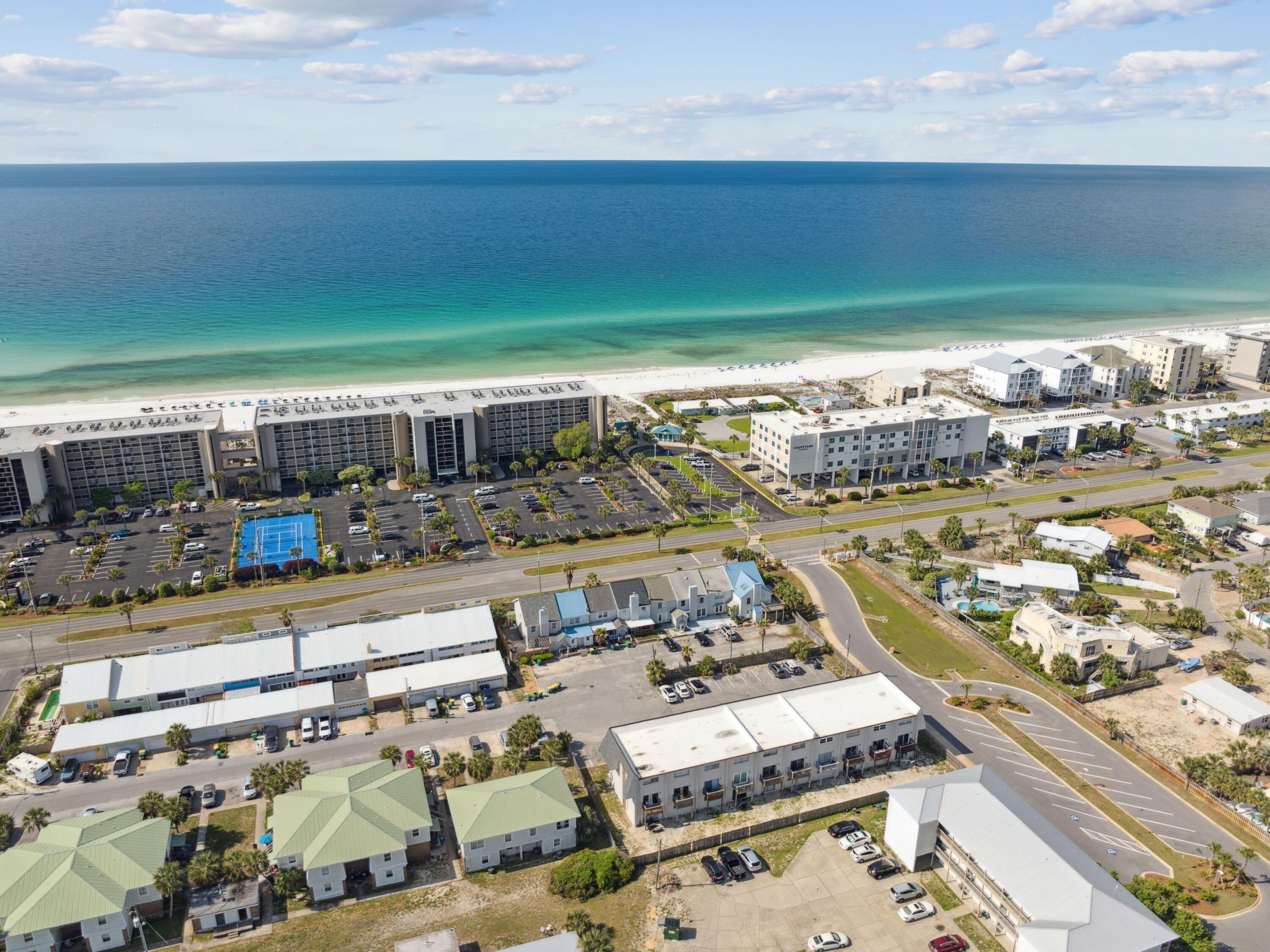 Located less than 200 feet from the sugar-white sands of the Gulf and moments from a public boat dock, this beautifully updated townhome on Okaloosa Island presents a rare opportunity to enjoy refined coastal living with exceptional investment appeal. Thoughtfully renovated throughout, the residence pairs timeless beachside charm with modern functionality in one of the Emerald Coast's most desirable waterfront communities.

Inside, a freshly painted interior introduces a bright and inviting atmosphere, enhanced by coastal-inspired tones, shiplap detailing, and durable luxury vinyl plank flooring that extends throughout the main living spaces. The open-concept design seamlessly connects the living, dining, and kitchen areas, creating an effortless setting for gathering and entertaining. The kitchen is well-appointed with white cabinetry, generous prep space, and a full suite of appliances designed to support both everyday living and extended beach stays. Upstairs, three spacious bedrooms and two full baths offer comfortable accommodations for residents and guests alike. The private primary suite serves as a peaceful retreat, complete with tranquil water views and a beautifully updated ensuite bath. Additional shiplap accents and calming coastal finishes continue throughout the upper level, reinforcing the home's relaxed yet elevated aesthetic.

Outdoors, a private fenced courtyard extends the living experience with a spacious deck, cozy fire pit area, and newly planted palm tree that creates a lush, welcoming backdrop for outdoor dining or evenings under the stars. Recently repainted front and rear decks further enhance the property's curb appeal.

Recent improvements include a new shingle roof, coastal-grade HVAC system, updated electrical panel, renovated bathrooms, and modern fixtures throughout. Offered fully furnished with smart TVs in every room, private parking, and no HOA fees, the property is positioned for immediate enjoyment and strong rental performance.

With unmatched proximity to the beach, boating access, local dining, shopping, and transit, this turnkey residence offers the ideal combination of lifestyle, convenience, and long-term value on Okaloosa Island.