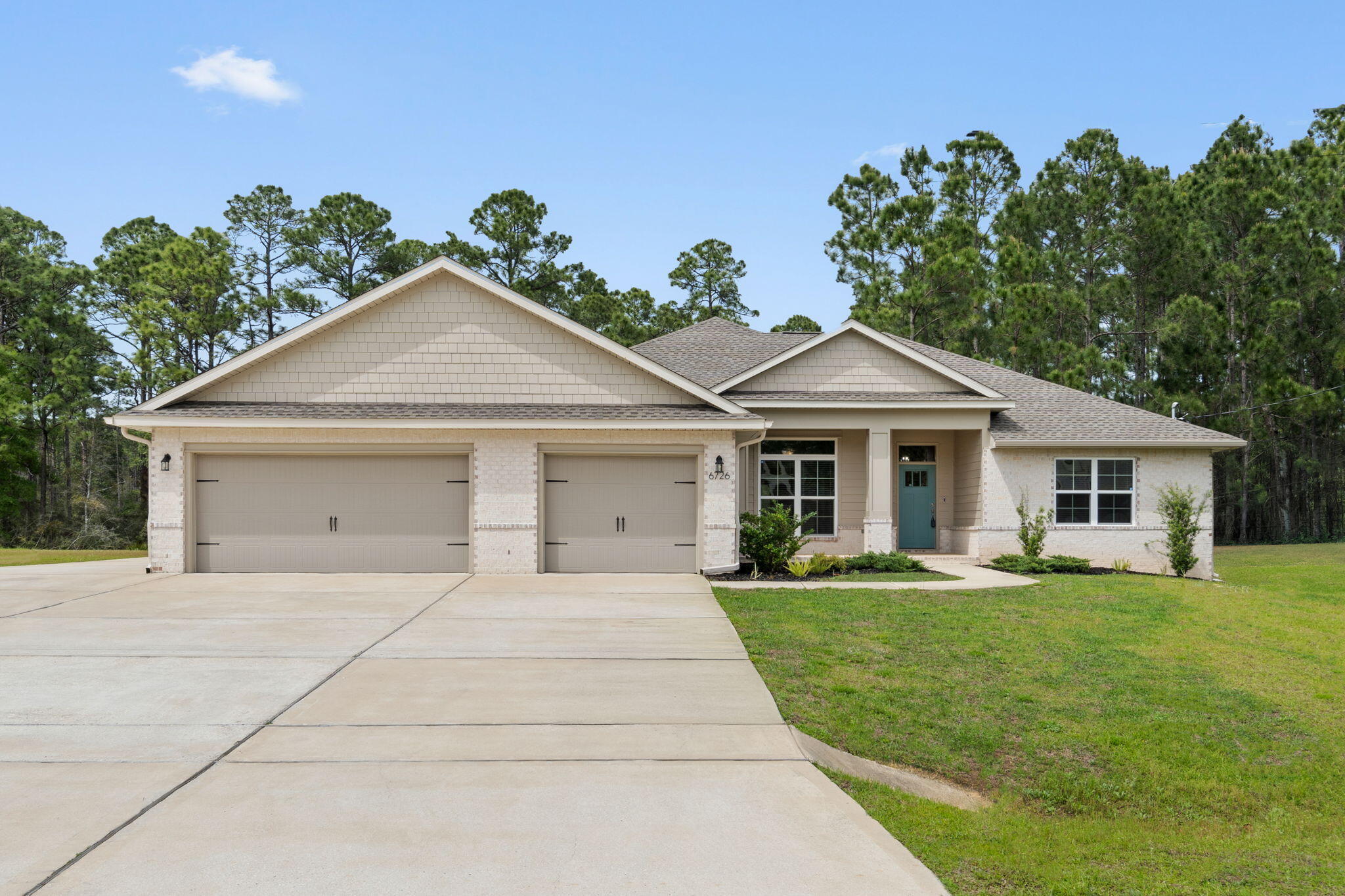 Stunning Craftsman-style custom home by Robbins Builders offering 4 bedrooms, 2 bathrooms, a versatile office/playroom, and a 3-car garage with extended driveway. Centrally located with easy access to Navarre Beach, Navarre Park, shopping, schools, and Hwy 98 to Hurlburt Field. This thoughtfully designed open floor plan welcomes you with a foyer leading into a spacious family room and dining area. The gourmet kitchen features shaker cabinetry with crown molding, granite countertops, stainless steel appliances, undermount sink, two pantries, and a large center island with breakfast bar. Beautiful wood-look plank tile flooring flows throughout the home, offering durability and style.The primary suite offers a trey ceiling, ceiling fan, and a beautifully appointed en suite  bath with dual walk-in closets conveniently located within the bathroom, an oversized tiled walk-in shower with seamless glass door, and a granite double vanity separated by a functional linen/storage closet, complemented by picture framed mirrors and brushed nickel finishes. Additional bedrooms are generously sized with ceiling fans and ample closet space. The secondary bath includes a granite vanity, tub/shower combo, and adjacent linen closet. A flexible office or playroom adds functionality. Enjoy outdoor living with covered front and rear porches. The north-facing backyard provides evening shade to enjoy those wonderful Florida evenings and includes an irrigation well and timed sprinkler system. Additional features include hurricane protection, dimensional shingle roof, crown molding, recessed lighting, deluxe lighting package, attic drop-down stairs, and garage door openers.