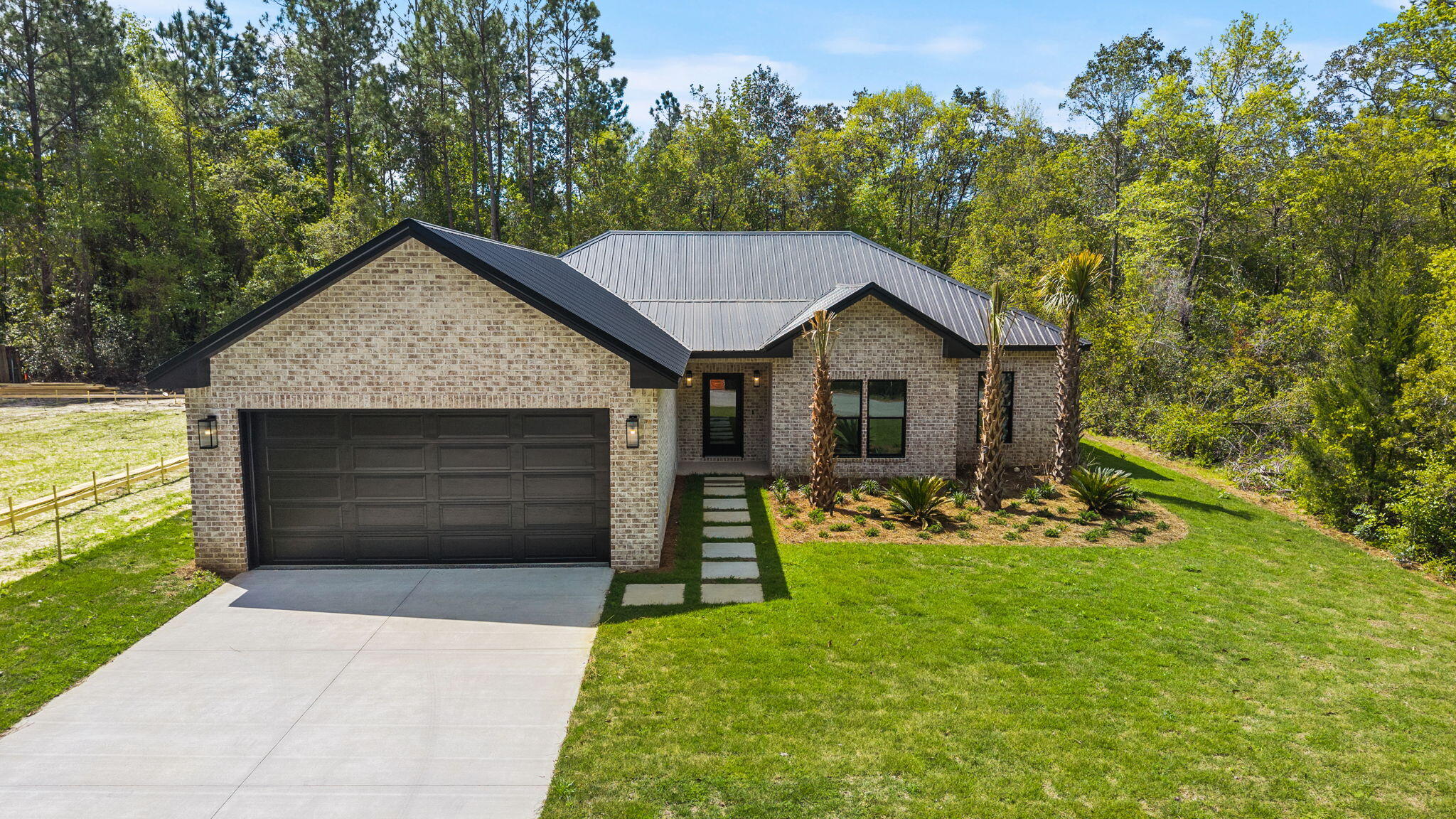 Welcome to 57 Village Court, a custom new construction home in the heart of Freeport, where modern design, quality craftsmanship, and everyday functionality come together just a short drive from 30A's beautiful white-sand beaches and amenities.

This thoughtfully designed 4-bedroom, 2.5-bathroom residence spans approximately 1,928 square feet, offering a seamless blend of modern luxury and livability. From the moment you step inside, you're greeted by elevated finishes including custom trim work, LED tray ceilings, and a light-filled open-concept layout that effortlessly connects the living, dining, and kitchen spaces. The living room is open and inviting, featuring double doors that lead to a covered back porch overlooking a lush, spacious backyard. With ample room for a future pool, garden, or outdoor kitchen, the outdoor space is ready to become your own private retreat.
At the center of the home, the designer kitchen balances both beauty and function. It features upgraded Bosch appliances, an extended waterfall quartz island with a built-in cordless charging hub, fluted island detailing, gold hardware and fixtures, complemented by an upgraded lighting package. This space also offers a walk-in pantry with built-ins, along with soft-close cabinetry and drawers, which add both convenience and thoughtful organization.

The primary suite serves as a private retreat, complete with LED tray ceilings and peaceful backyard views. The spa-inspired bathroom showcases a fully tiled floor-to-ceiling walk-in wet room with three showerheads (rain, handheld, and wall-mounted) alongside an oversized freestanding soaking 72" tub. This sanctuary also features floating dual vanities with a Taj Mahal countertop, modern backlit mirrors, and dual arched linen niches for storage yet adding to the overall design aesthetic. A custom walk-in closet with built-ins completes the space.

Three additional bedrooms are tucked away in their own separate hallway, offering privacy for guests, a home office, or additional family members. The secondary bathroom continues the home's elevated design with a dual floating vanity, light-up mirror, and a fully tiled walk-in wet room. Linen closets in both the hallway and bathroom, along with built-ins in every closet, provide abundant storage throughout.

Just off the entry, a stylish half bath curates an artistic accent with full floral wallpaper and a Taj Mahal floating sink, adding a distinctive designer touch.

Designed with both comfort and efficiency in mind, the home includes many premium upgrades including impact-rated doors and windows, instant heat electric water heater, a whole-home water filtration system and an irrigation system. The two-car garage features durable epoxy flooring and a side door providing easy access to the side of the house dedicated to the utility systems.

57 Village Court offers a unique luxury of living in the Freeport area with intentional design and everyday livability with its prime location in no HOA. Start living the lifestyle you deserve and schedule your private viewing today!
