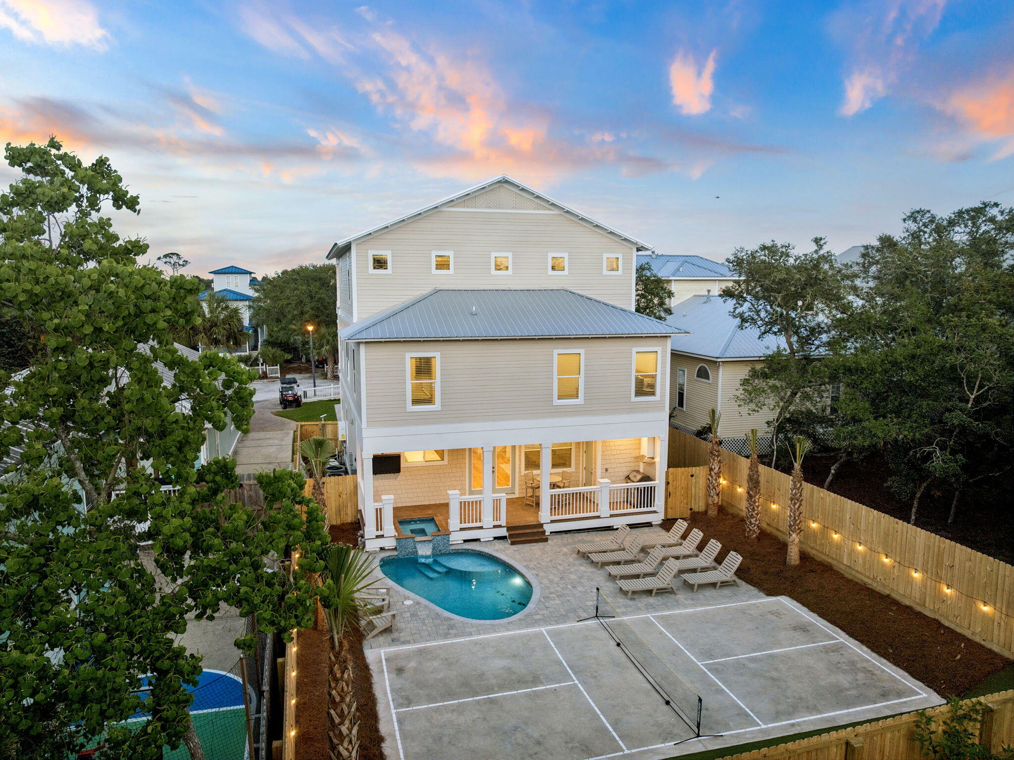 Welcome to 86 Sunfish Street, a brand new 2026 construction masterpiece in Destin's coveted Kokomo Kove community, one of the few neighborhoods in Crystal Beach with private deeded beach access right at the end of the street. This three-story coastal retreat delivers 8 bedrooms, 9.5 bathrooms, and 4,227 square feet of thoughtfully designed living space, making it an exceptional primary residence, second home, or premier vacation rental investment.

From the moment you arrive, the curb appeal sets the tone: a paver driveway leads to a striking HardiePlank and shake-siding exterior topped with a standing-seam metal roof, with three levels of covered porches and balconies that glow beautifully at sunset.
The open-concept first floor flows seamlessly from the living room through the dining area to a chef's kitchen featuring white shaker cabinetry, a professional gas range, dual dishwashers, and a sprawling quartz island dressed in wicker pendant lights. Each of the eight bedrooms has been designed as its own retreat, with en-suite or private baths featuring quartz vanities, arched brass-framed mirrors, and designer lighting throughout. The third floor functions as a self-contained suite, featuring a private bedroom with bathroom, a bunk room with its own bathroom, and a kitchenette with stainless appliances - perfect for multi-family stays or maximizing rental flexibility.

Outside, a private pool and built-in spa, seamlessly integrated into the first-floor deck, anchor a paver courtyard within a fully fenced, private yard. A regulation pickleball court gives guests of all ages something to enjoy, while the sweeping third-floor covered porch with vaulted ceiling and treetop views is the kind of retreat that makes a beach house legendary.

Short-term rental-friendly with the established charm of Crystal Beach right outside your door. This is Emerald Coast living at its finest.