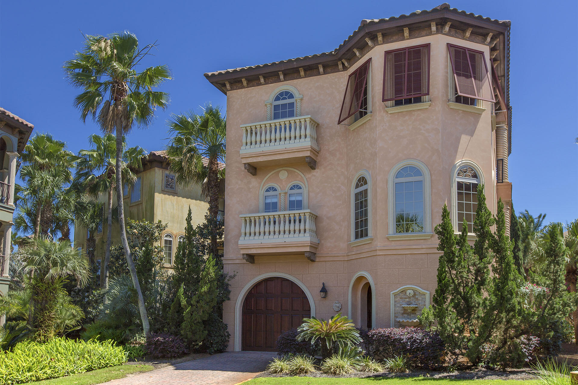 Named the Emerald Palazzo this home and neighborhood are fashioned after the villas on the French Riveria. This exceedingly gracious three-story vacation home exudes elegance and has 4 bedrooms & 2.5 baths. The home overlooks the lavish community lagoon pool with fountains and a bubbling hot tub, plus lush landscaping. An opulent spiraling staircase tower leads to the giant Master Suite with a romantic balcony.  All the guest bedrooms have access to poolside patios or balconies.  Stamped concrete floors, a spacious open living area and a fourth bedroom on the third floor that could be an office make this home perfect for the owner who wants to live in the home or rent. Perfect location just a few min walk to the beach, local restaurants and shopping. This is a must see!
