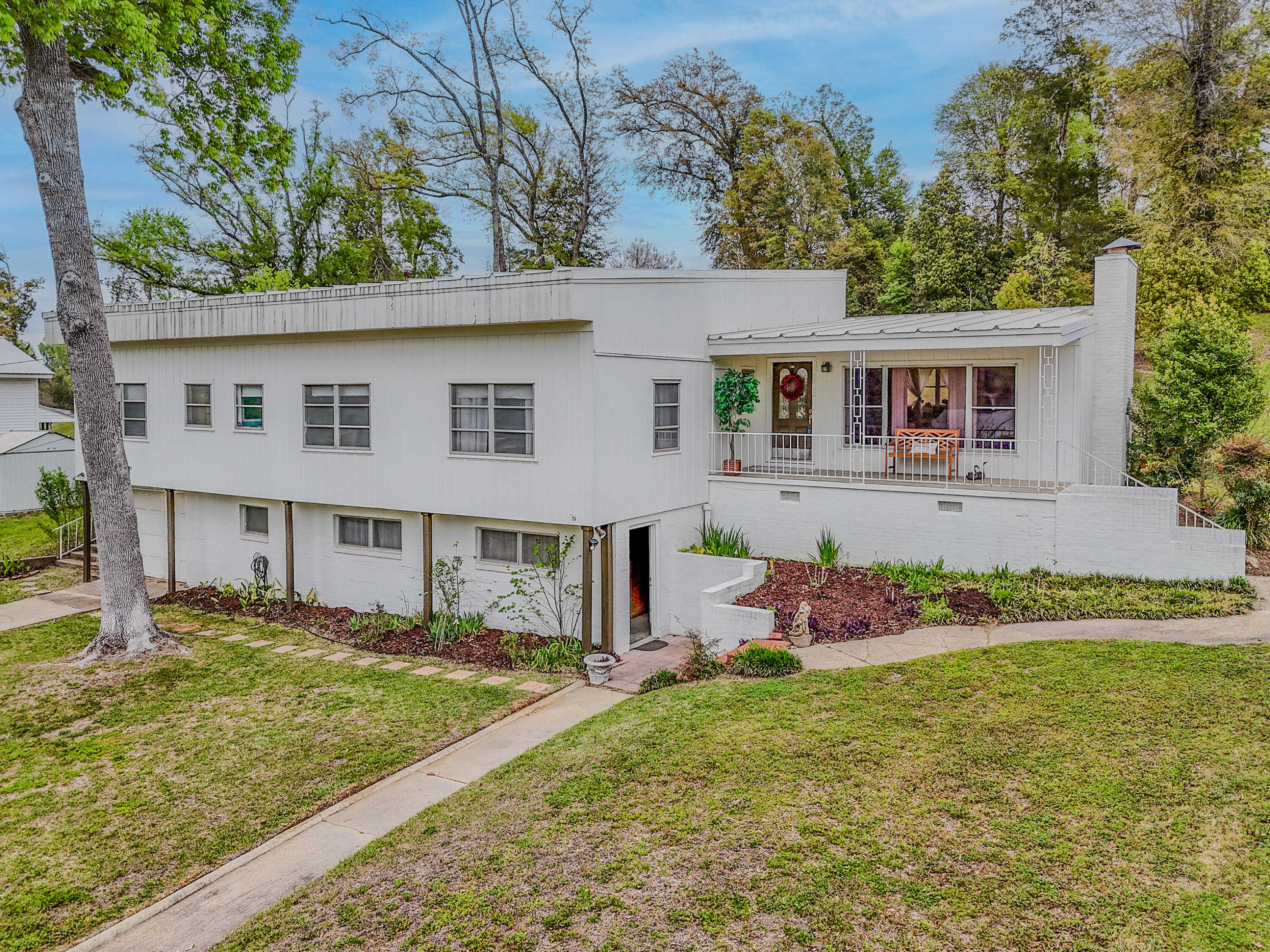 Seller is having a new roof installed! Discover this beautifully updated mid-century modern home in a desirable, established neighborhood of Marianna. Set on a spacious 0.42-acre lot with mature trees and lush landscaping, this 3-bedroom, 2-bath residence (approximately 1,870 sq ft) with a total SqFt of 2,794SqFt offers timeless appeal with thoughtful modern renovations.
Step inside to find an open, light-filled layout with fresh finishes throughout. The expansive living area features warm wood tones, built-in shelving around the cozy brick fireplace, and abundant natural light from large windows overlooking the serene, tree-shaded yard. The kitchen boasts crisp white cabinetry, ample counter space, a double sink, stainless steel appliances, and charming decorative touches that make it both functional and inviting.
The primary living spaces flow effortlessly, including a generously sized family room perfect for gatherings. The bedrooms are comfortable and well-proportioned, while the bathrooms have been nicely refreshed--one featuring a classic Jack-and-Jill configuration for added convenience.
Outside, the home shines with multiple outdoor living areas: a large wooden deck with dining space and seating, a covered front porch with a welcoming bench, and an expansive backyard offering privacy and room to roam. Enjoy peaceful views of the surrounding greenery, established trees, and natural elevation.
Additional highlights include a one-car garage, practical storage throughout, and a prime location near local amenities, schools, and conveniences while retaining a quiet, country-like feel.
Whether you're looking for a move-in-ready family home or a peaceful retreat with room to entertain and relax outdoors, this charming property on Dogwood Street delivers character, updates, and Florida living at its best. Don't miss the opportunity to make it yours! Property listed in Emerald Coast Association of Realtors.