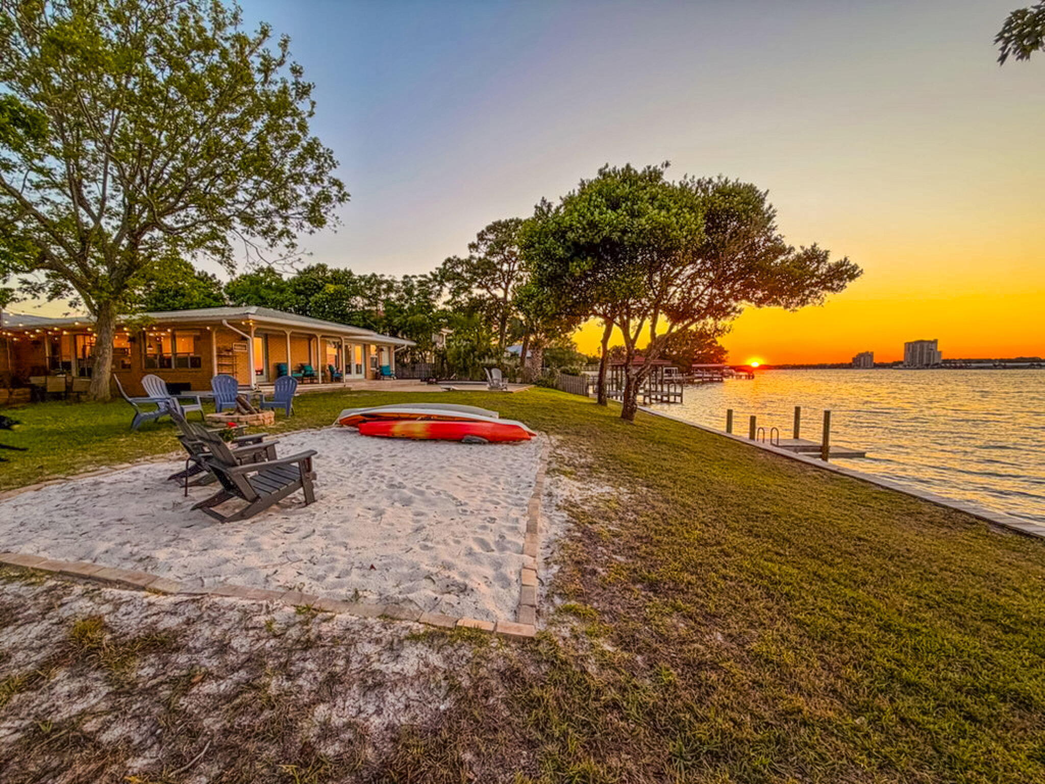 Sound Front Serenity meets Gulf Coast Living. This charming, mid-century modern home with 4 bedrooms, 3 full bathrooms, and 2502 sq ft offers 147 feet of water frontage and .39 acres on the Santa Rosa Sound! Enjoy endless water views and sunsets from the comfort of your home. The Sound is located on one side of the barrier island and offers boating, fishing, swimming, canoeing, paddle boarding, and water sports while the Gulf and white sandy beaches are on the other side of the island and only 4 minutes away. The exterior of the home has a metal roof, gutters, a paver parking pad, an extended driveway lined with pavers and plenty of parking for a boat and multiple vehicles. There is no HOA and golf carts are allowed. The home is perfect for entertaining with covered patios overlooking the water to a patio connecting both sides of the home. Enter the foyer and immediately there are views of the Sound! A large living room is located to the right of the foyer through a case opening and a home office is located to the left of the foyer through French Doors. The living room has built in, custom cabinetry and a large picturesque window allowing views of the palm trees and natural light to abound. The front room is perfect for a home office or a fourth bedroom. The kitchen is updated to include a large, 6 ft island that seats 6, pendant island lighting, white shaker, custom cabinetry to the ceiling with crown, stainless appliances to include a French Door refrigerator, built in microwave, dishwasher, and a five burner gas slide in oven and stove.  There are also granite counter tops, a tiled back splash and recessed lighting. Classic elements of the home such as the terrazzo flooring blends with the modern finishes to create a custom, luxury retreat. The home has both an open and split floor plan. The update kitchen opens to the dining room and a second living room with all boasting water views of the Sound! The spacious primary bedroom overlooks the Sound and has French doors leading to the covered patio. There is an ensuite bathroom completely updated to include a large double vanity with plenty of storage space, a large, tiled walk in shower with floor to ceiling tile and a frameless glass divider, a soaking tub, tiled floors, new mirrors, sconce lighting, faucets and fixtures. The primary bedroom also offers a large walk in closet with shelving. On the other side of the home there is a guest bedroom overlooking the Sound! An additional guest bedroom with views of the palm trees and a full bathroom. The Bathroom has an extra-long single vanity, tub shower surround and white tiled walls. There is a third bathroom near the kitchen and a laundry room. Exit sliding glass doors from either side of the home and relax on multiple patios! The upper patio is tiled and the lower patio is spacious and allows for a large table for outdoor dining. The back yard has a recreation area for corn hole, basketball, or pickle ball, fire pit, and a sandy area for lounging in the sun. Several covered patios allow for breathtaking views of the Sound while relaxing in the shade. The seawall that spans approximately 147 feet was replaced in 2018 and there is a short dock with stairs to enter the sandy bottom, shallow water. Pride of ownership shows and many features of the home have been updated. For example, the homeowner upgraded to a Rinnai tankless hot water heater (2018), replaced a second hot water heater in 2023, replaced an HVAC in 2025, maintains a termite bond with Sentricon termite protection, completely refurbished the sprinkler system in 2024, replaced the kitchen appliances in 2018 and replaced the corrugated sea wall in 2018. This home is perfect for a primary home, second home, or investment property. This well designed mid century modern home provides exceptional coastal charm on a lot with one of the longest seawalls on the island! Buyer to verify all dimensions and information.