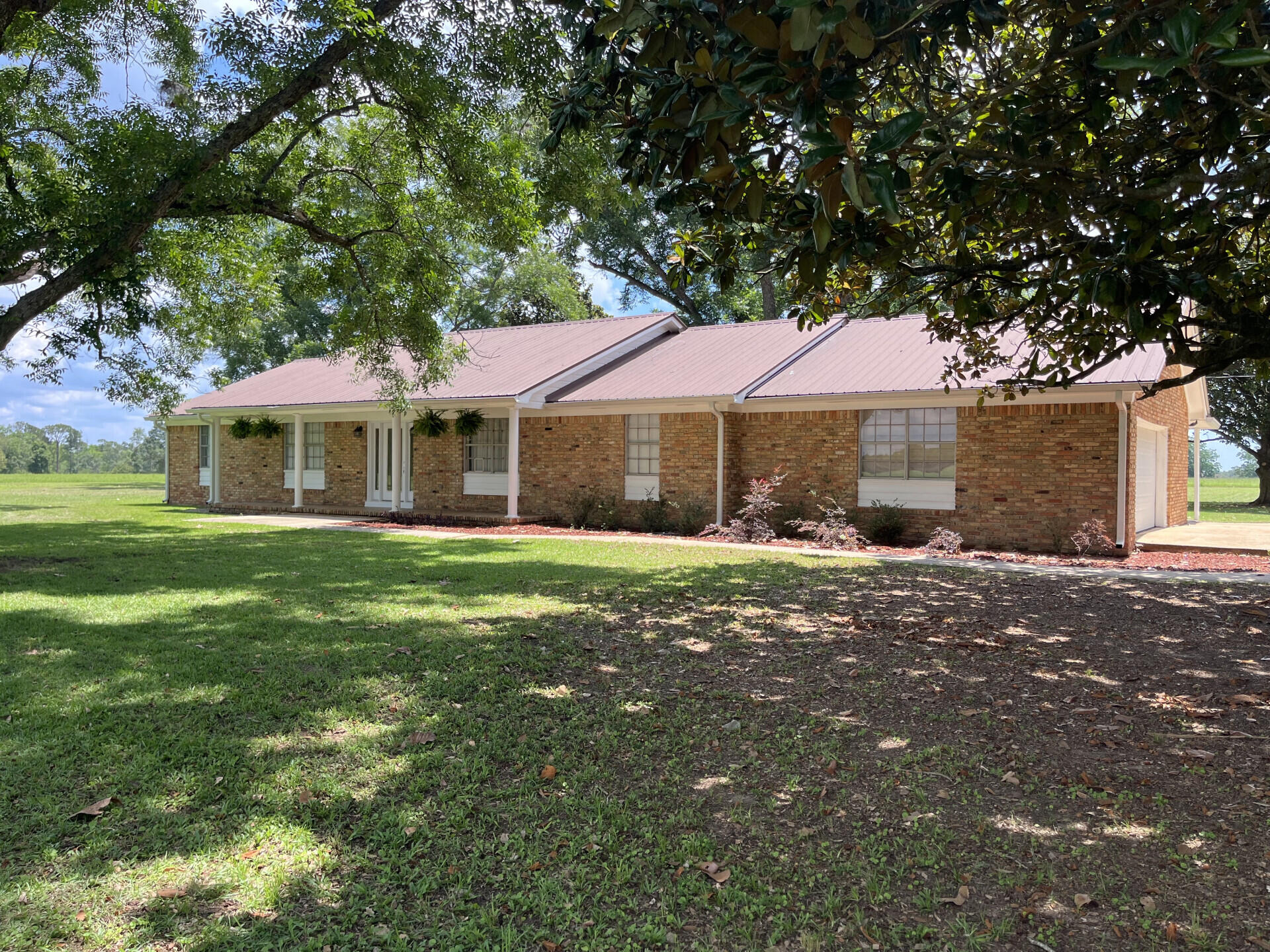 Set on 5 private acres in Baker, FL, this 3,417 sq ft brick home pairs solid 1967 construction with room to breathe. Four bedrooms, three full baths, plus a separate office, formal living room, and family room. The standout: a massive 30'×28' sunroom with wet bar, built-in tub, and walls of windows. An attached two-car garage completes the main house. A two-story brick barn with animal stalls offers serious potential--an unfinished upstairs apartment and unfinished downstairs bath make a blank canvas for guest quarters, a studio, or income suite. Mature pecan and magnolia trees, a huge driveway, and a durable metal roof frame the grounds. Hobby farm, space for animals, or simply privacy and elbow room -- this property delivers. Priced as-is to leave room for your own updates. Under an hour to the beaches of Okaloosa Island and minutes from Blackwater State Forest and its endless outdoor activities. True country living, with the coast within reach.