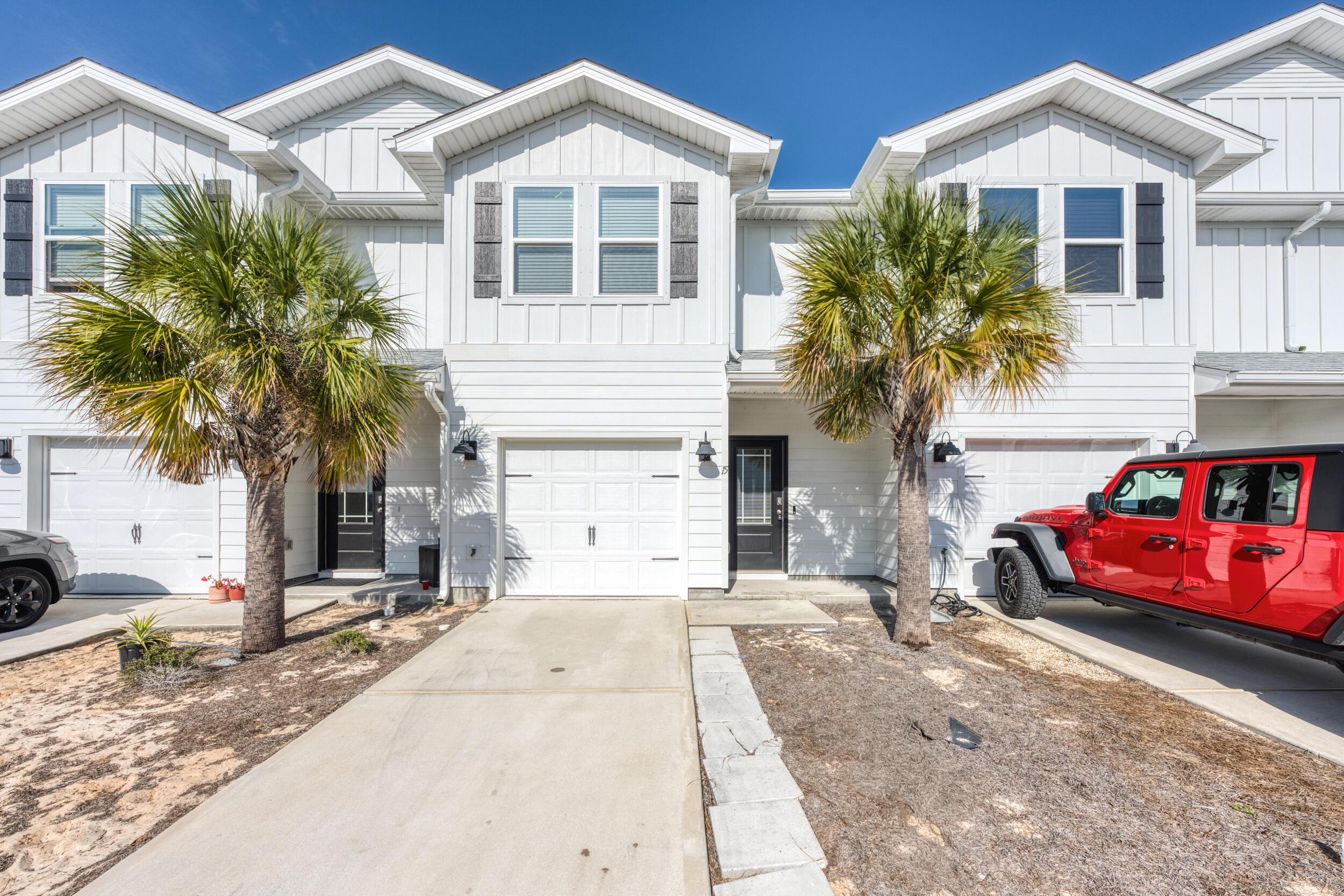 Step into this practically brand-new 3-bedroom, 2.5-bath townhome, nestled just minutes from Harbor Walk Village and all that Destin has to offer. With easy access to iconic restaurants, vibrant cafes, stunning beaches, and outdoor activities like boating and walking paths, this home provides the perfect blend of coastal living and modern convenience. Inside, you'll be greeted by an open floor plan that boasts an oversized kitchen with a large breakfast bar, stunning farmhouse sink, quartz countertops, crisp white cabinetry, and sleek stainless steel appliances. The home's bright and airy ambiance is complemented by raised ceilings and premium vinyl plank flooring throughout, ensuring easy maintenance and a modern feel. Upstairs, the spacious primary bedroom offers a private