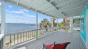UNDER CONTRACT WITH CONTINGENCIES; SELLER ACCEPTING BACKUP OFFERS. 
One of the best-priced bayfront properties with direct Gulf access in Bay County, this beautifully updated three-story East Bay townhome delivers deep-water access, stunning views, and exceptional versatility--including a fully independent 1 bed / 1 bath ground-floor apartment. Whether you're seeking a primary residence, second home, VRBO/Airbnb investment, or a live-upstairs/rent-downstairs setup, this property checks every box. NO HOA. 
SHORT TERM RENTAL ARE ALLOWED!
Located just 5.5 miles from Tyndall AFB and minutes from Sacred Heart Hospital, this home offers convenience paired with true Old Florida charm. The exposed beam ceilings create a warm, heritage feel, while numerous modern upgrades make the home move-in ready. Recent improvements include a brand-new seawall, new porch decking, new fencing, new windows on the 3rd floor and master suite, new LVP flooring, new cabinets with quartz countertops, new bathroom tile, a newer metal roof, a 5-year-old HVAC, and a 3-year-old water heater.

Step inside the main level and enjoy a spacious great room and kitchen that open to a 22' x 10' covered waterfront balcony--perfect for hosting, relaxing, and taking in the breathtaking sunsets over East Bay. The middle level features the master suite with its own private 22' x 10' balcony, offering peaceful sunrise and sunset views. This floor also includes a large guest bedroom capable of accommodating two beds, along with a full guest bath.

The ground-floor apartment is a standout feature: a complete 1 bed / 1 bath unit with full kitchen, separate entrance, and its own A/C. It functions as a true lockout unit, ideal for rental income, guests, or multigenerational living. The occupant can enter through the backyard and walk around the side of the home to their vehicle without accessing the main residence.

Every floor of this home offers beautiful bay views. Step outside to your private beach with seawall, just steps from your door. Ownership also includes 1/11 interest in the 90+ ft ''Pitts Row'' dock, where you can park your boat, jet skis, or other watercraft--or build your own private dock if desired. With deep water and easy access to East Bay, Shell Island, and the Gulf of Mexico, this is a boater's dream.

This rare waterfront opportunity blends charm, upgrades, income potential, and unbeatable access to the Gulf. Schedule your showing today and experience the best of East Bay living.